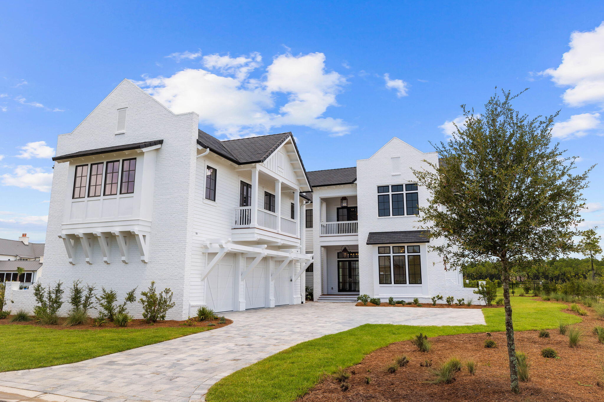 This stunning new construction home in WaterSound combines a luxurious lifestyle with the joys of lakefront living. Designed by renowned architect Chris Stoyles of Archiscapes and showcasing stunning furnishings and interiors by Bontemps Interiors, this 5,600-sq.-ft. residence includes a spacious carriage house above the three-car garage. Two living areas with floor-to-ceiling windows frame serene water views to the rear of the home. Completed in 2024, everything is pristine, from the contemporary chef's kitchen to the bubbling waters of the private pool. With its retractable NanaWalls, the sitting room invites you to put your feet up in front of the floor-to-ceiling fireplace and savor contentment. Shiplap walls and hardwood plank flooring continue through the open kitchen to the dining room with lake views on two sides. The gourmet kitchen is avant-garde, with a textured tile backsplash and a dining island wrapped in Calacatta veined quartz. Veneered Milano doors add a contemporary touch to the cabinetry and extractor hood. Wolf and Sub-Zero appliances include a wine cooler and a six-burner gas stove with a double oven beneath. The butler's pantry has a second refrigerator, freezer drawers, a dishwasher, a Wolf warming oven, an ice maker and additional storage. Doors open onto the decked porch with a cozy outdoor fireplace. Beyond that, a verandah provides the perfect alfresco dining setting. Take a morning dip in your oversized private pool, relax in the spa and watch herons and wildlife just beyond the fence. A cabana with a fully equipped summer kitchen makes entertaining easy with its dedicated sink, grill and built-in refrigerator. The pool house includes an outdoor shower. The first-floor master suite has multiple windows surrounding a tranquil view. The customized walk-in closet/dressing room will indeed create home envy, along with the spacious master bathroom. It has a stunning tiled shower and an oval garden tub, creating a holistic escape from everyday stress. The second floor is uplifting with a den, office and three more bedrooms, all with private baths. There's also a covered porch for sunset views. Honored guests can stay in the 1,000-sq.-ft. carriage house. It has a private sitting room, bedroom, bathroom and laundry. The full kitchen is equipped with Fisher & Paykel appliances. This lavishly appointed home is pre-wired for home automation system and has a DaVinci roof with 50-year warranty. It includes a WaterSound Club membership, guard-gated security and a host of lake, beach, golf and sporting amenities.