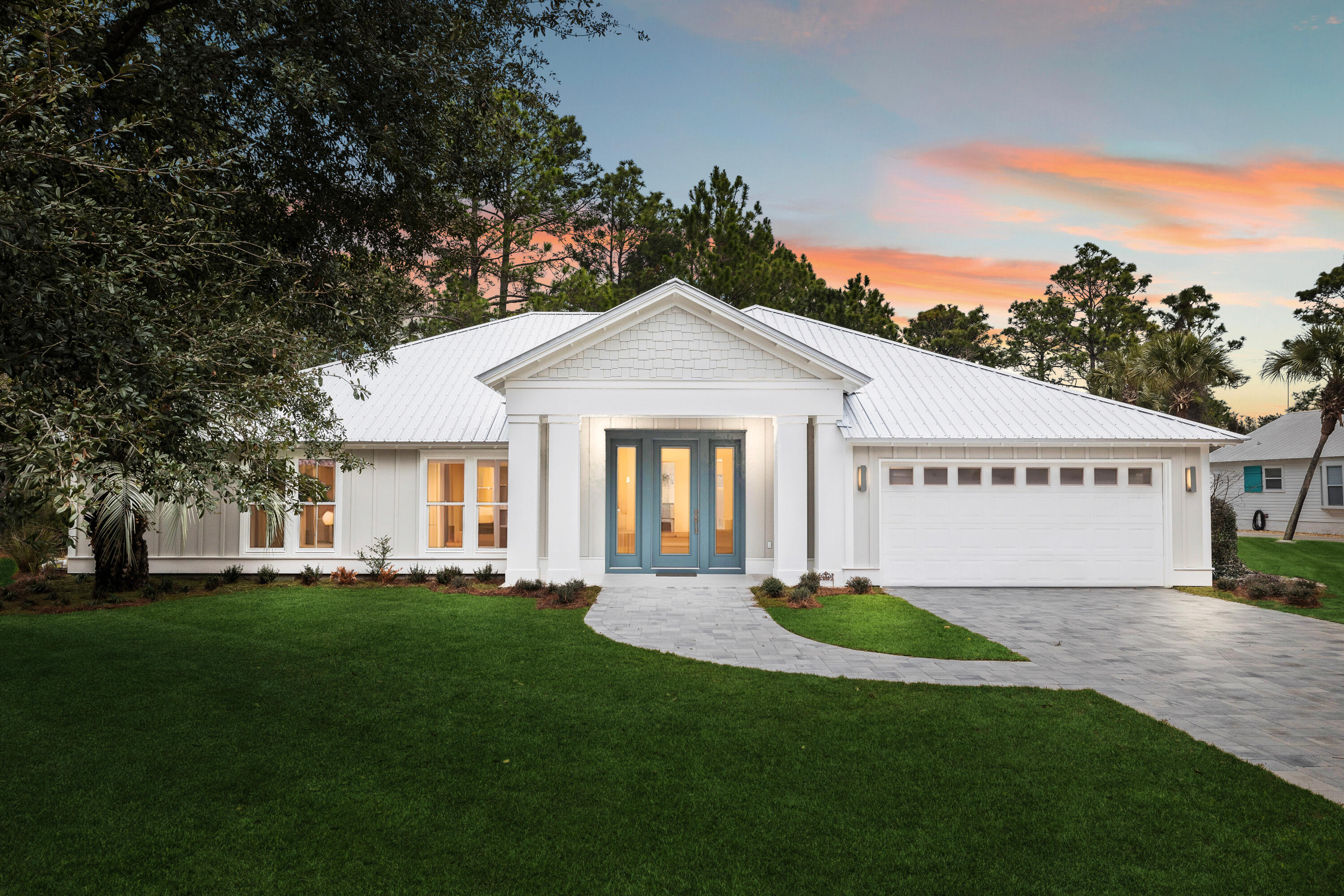 Tucked within the enchanting Sugarwood Beach community, this newly built coastal retreat offers over 3,200 square feet of refined, single-level living. Designed with effortless flow and coastal elegance in mind, it welcomes you with an open-concept layout where natural light, designer touches, and thoughtful finishes abound. The living room is warm and inviting, with a glowing fireplace and large windows that capture coastal breezes. Whether you're entertaining guests or savoring quiet moments, the space feels both sophisticated and serene. The kitchen is a true standout--anchored by a grand island, quartz countertops, mosaic tile, and top-tier Frigidaire professional appliances. It's a place made for gathering, cooking, and creating memories.