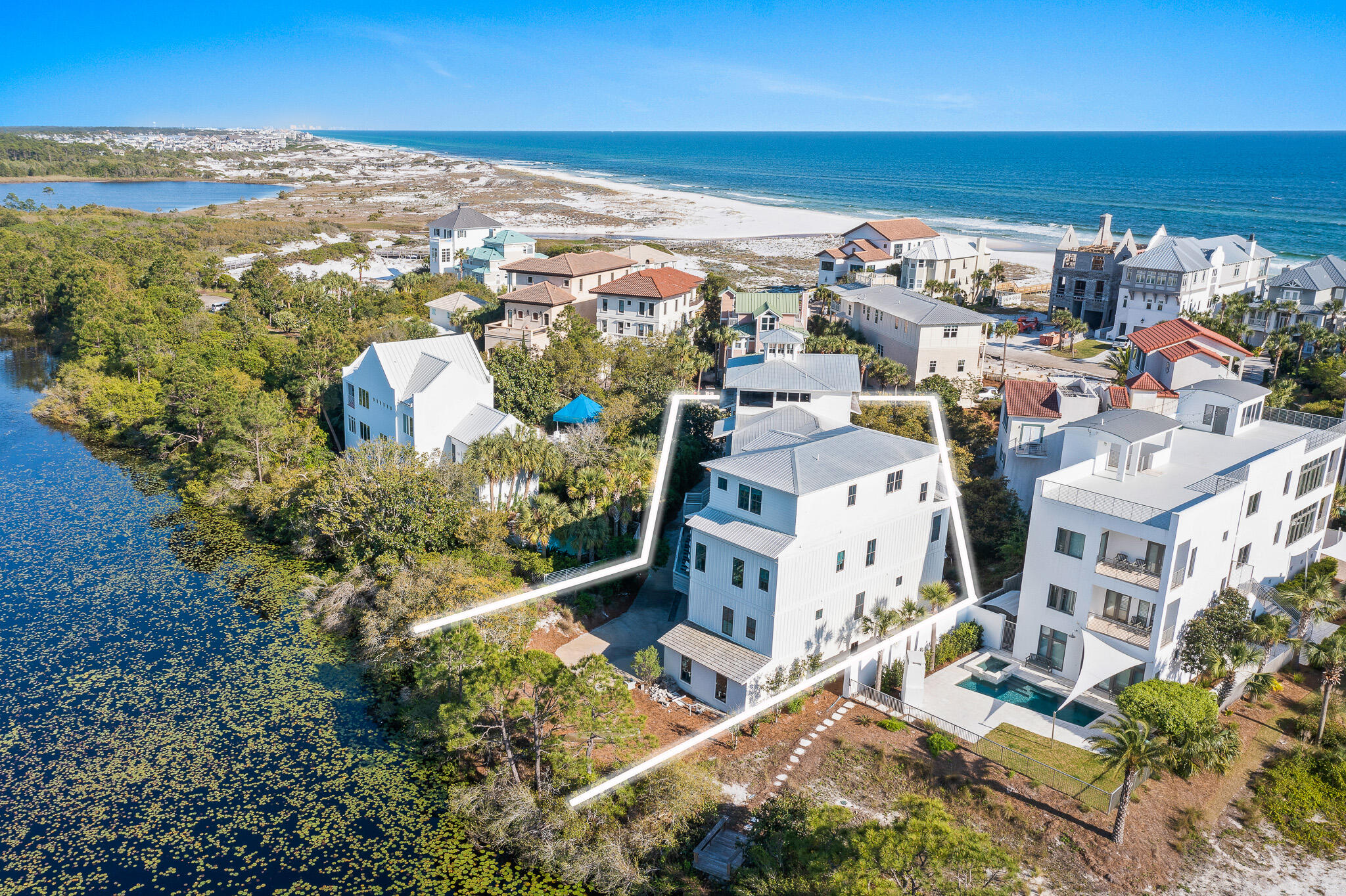 30A RENTAL REVENUE GIANT! A prime south of 30A location in the gated community of Seclusion Dunes, bordering the rare and special Gulf-front preserve lands of Deer Lake State Park. With established rental revenue of +$343,000, trending to exceed $370,000, this is a strong vacation rental performer.  Situated with the lake along the rear and just steps to the beach, this incredible coastal retreat boasts stunning Gulf and lake views and has enough space to accommodate up to 35 people. The custom designed outdoor living of this residence is impressive and unsurpassed, with multiple decks, an elevated pool deck thoughtfully positioned overlooking the lake, and two separate wet bars.
The first level houses a massive bunk room with bath, generous entry space and the garage space.