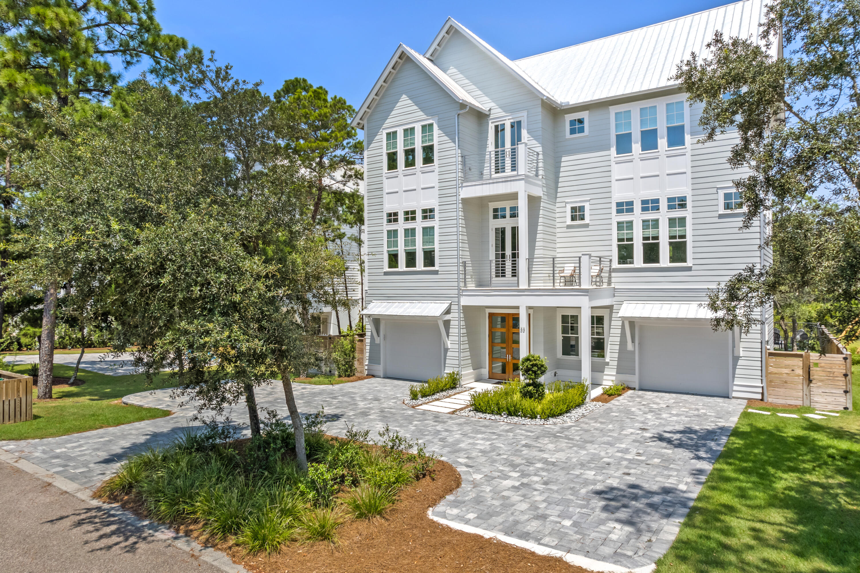 This exceptional 5-bedroom, 5-full-bath, 2-half-bath custom-built home offers the perfect blend of luxury, comfort, and flexibility. Completed in 2022, this 4,823 sq ft residence is ideally suited for a family home, second retreat, or investment property. This home is FULLY FURNISHED and includes modern upgrades such as a new roof, HVAC, and water heater. Upon entering, you are welcomed by a grand foyer that opens to an expansive 1,400 sq ft outdoor living area which features a saltwater in-ground pool, outdoor kitchen, fireplace, firepit, and serene pond views. On the second floor you'll find an open-concept kitchen, living, and dining area. The chef's kitchen is a standout, featuring a marble waterfall countertop, a large island, integrated refrigerator, walk-in pantry, lighted cabinetr y, and a double oven. The living area flows out to a nearly 450 sq ft covered patio, complete with a TV and fireplace, creating the perfect space for unwinding. The second floor also includes a luxurious primary bedroom suite, offering a balcony with peaceful pond views. The spa-like bath features a garden tub, separate shower, double vanities, and a spacious walk-in closet. The office on this floor is ideal for work or study and can comfortably sleep two guests. On the third floor, you'll find four additional bedrooms, including a bunk room, and a cozy family room. Four of the five bedrooms in this home feature ensuite bathrooms, providing privacy and convenience. High ceilings, intricate millwork, crown molding, wood accent walls, built-ins, and an elevator elevate the home's design, enhancing the luxurious atmosphere. For added convenience, the property includes three laundry rooms, two wet bars, six balconies, two separate garages, and three owners closets. Whether you're looking for a tranquil family haven, a vacation getaway, or a prime investment opportunity with high rental potential, this home delivers. With no HOA and a quiet street, it's the ultimate in coastal living.