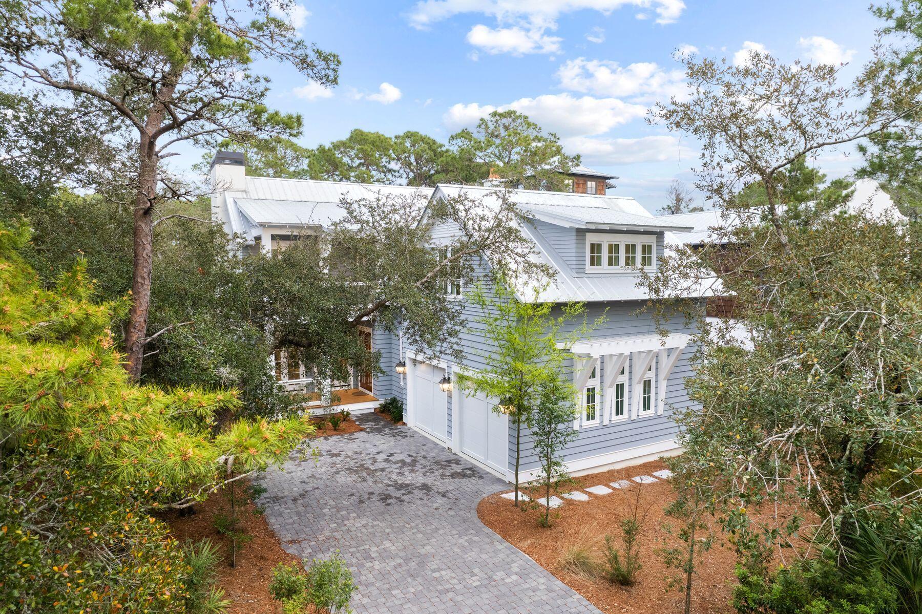 Relish peaceful serenity and nearby beach access in this beautifully redecorated Geoff Chick home positioned behind the gates of Wilderness Way. This four-bed, five-bath home spans nearly 3,500 square feet across two levels in a Hamptons-inspired package that offers unparalleled amenities and a coastal lifestyle in Grayton Beach. Backing up to the 2,000-acre Grayton Beach State Park, this home boasts a community pool and community dock on Western Lake in a non-rental neighborhood. The interiors of the home are open and spacious with soaring ceilings, open-concept living, fresh paint, new stone fireplace and sparkling hardwood floors. The chef's kitchen is outfitted with Sub-Zero appliances and an oversized quartz island. A bedroom on this floor offers an en suite bath; a laundry room with built-in storage and new half-bath offer additional conveniences. The second floor is home to a spacious owner's retreat with soaking tub and walk-in closet as well as additional bedrooms including a flex space with four bunks that could be used as a bedroom or transitioned to a living area, office or game room with half bath. New light fixtures throughout have been added. The outdoor areas are as exquisite as the interiors with 1,100 square feet of outdoor decking that leads to covered outdoor living in the fenced backyard, a pool, spa and sunning deck. Enjoy a generous two-car garage with storage and parking for up to six vehicles. Paddle to the nation's No. 1 beach, take a quick golf cart ride to the boutiques and dining and relax inside the eclectic community known as Grayton Beach.