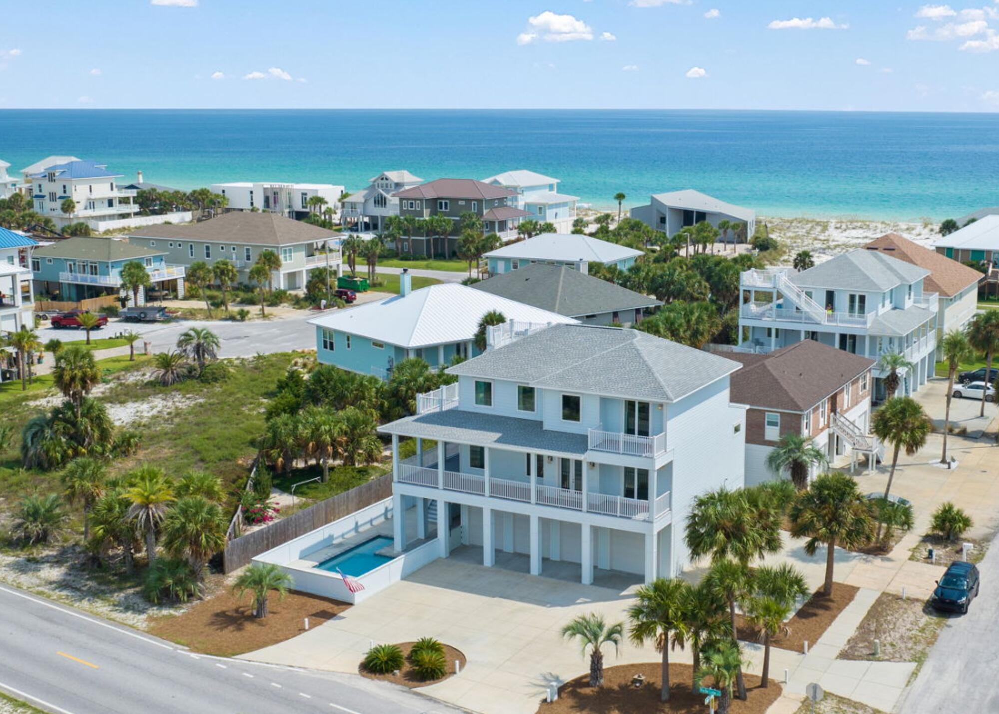 Step into a life of comfort and opportunity with this luxurious retreat, just steps from the Gulf of Mexico. Not only does this home offer a cozy, welcoming atmosphere, but it also presents a prime investment opportunity. The in-ground pool, expansive balconies, and rooftop deck provide perfect spaces for relaxation and entertaining, all with breathtaking views of the emerald Gulf waters.
As you enter, you'll be greeted by an open floor plan filled with natural light, creating a bright and airy ambiance that instantly feels like the dreamy vacation home you have envisioned. The spacious living room is ideal for gatherings and seamlessly connects to the dining area, making it easy to host family and friends.  The thoughtfully designed chef's kitchen is both beautiful and functional, featuring a large island, stainless steel appliances, and elegant countertops with a white subway tile backsplash, all complemented by charming beach-white cabinets.
On the main floor, the master suite offers a private retreat with a spa-like en suite bathroom, double vanities, a large walk-in closet, and a garden tub perfect for unwinding after a day at the beach. Upstairs, you'll find five additional spacious bedrooms, including two connected by a Jack and Jill bathroom. One bedroom offers direct access to a large balcony, and the hallway leads to another balcony with access to the rooftop deckperfect for savoring sunrises and sunsets.
The home's elevator provides easy access to all levels, starting from the oversized garage, which has ample space for storing beach gear and water toys. Whether you're envisioning a family home that doubles as a rental property or a cozy retreat that generates income, this property offers the best of both worlds.
Embrace the relaxed beachside lifestyle while making a smart investment in this charming Pensacola Beach home, where every day feels like a getaway.
