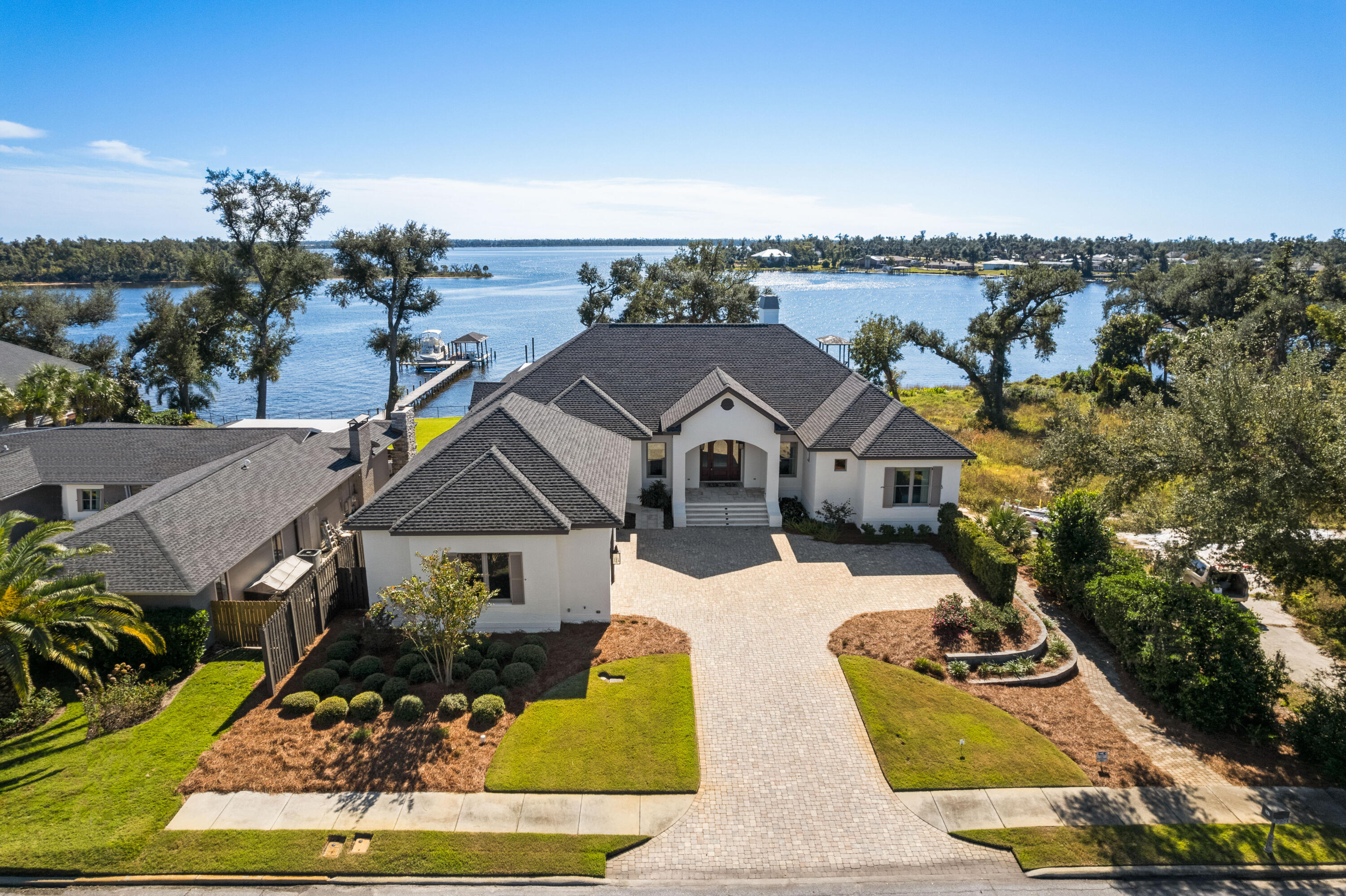 This modern, transitional waterfront masterpiece 6,700 SF residence takes full advantage of its bayfront location, blurring the lines between indoors and out while allowing for the most pleasurable resort-like lifestyle. The breezy outdoor spaces and light-filled, view-focused interiors offer relaxed and refined modern living. With over 100 feet of water frontage on St. Andrews Bay, this home boasts a private boat lift, boat house and dock leading from the water to the estate's lavish amenities which include a pool, hot tub, screened-in outdoor kitchen, pool, hot tub and accordion doors that lead to an exceptional family room and wet bar. A generous green space offers additional room for family games, entertaining and capturing the best views that waterfront living can afford, with no HOA. The outdoor space includes a full bath and climate-controlled bonus room, both adjacent to the pool. An expansive pool deck for large gatherings is perfect! 

Beyond the mahogany French doors, an open floor plan reveals pure Bay views, tongue and groove ceilings and expansive light-filled living spaces. Rich details throughout including stunning hardwood floors, vaulted ceilings, custom millwork covering the television and a gas fireplace. Meticulously designed window seats and an abundance of windows showing stunning views of the Bay, pool, and dock. The chef-style kitchen has custom cabinetry with a suite of professional grade appliances and a butler's pantry with additional sub-zero refrigerator, dishwasher and more that was designed to be open or closed to your liking. Among the mix of formal and casual spaces, the family room is adjacent to the kitchen and dining room, but all designed to ensure the Bay views are preserved. The main level Master bedroom includes oversized, customized walk-in closets and spa-like en suite, featuring a walk-in shower, soaking tub, dual vanities, and separate water closet room. Four additional bedrooms and three additional bathrooms along with a large mudroom and laundry complete the main level. The lower level of the home offers the greatest entertaining space you've ever seen. This open space includes high ceilings, wet bar complete with a thick honed granite, wine fridge, mini fridge, icemaker and dishwasher and the ability to capture the indoor-outdoor living desired. This level also offers a large bonus room with custom built-in tree houses for the kids, an abundance of storage closets and a private guest room with en suite. A fitness room and safe room/vault also complete the lower level of this home. This waterfront estate offers a whole-home generator ensuring the comfort of its owners and guests as well as a customizable security system, sound system, and lighting system. Notable features of the home include: three-car garage with epoxy flooring and dumbwaiter for storage, hardwood flooring and travertine, custom drapery, custom crown molding, designer lighting and A/C in the attic for maximum climate control and lush landscaping.

Poised within proximity to the famed Shell Island and only 7 miles to the emerald waters of the Gulf of Mexico pass, you'll see why the Cove is truly a boater's paradise. This home offers deep water and perfect for your center-console or sportfishing boat. Adjacent to the home is the neighborhood park where friends and neighbors gather as it is the heart of the community. Located just 2 miles from flourishing Downtown Panama City, you're within a short golf cart ride away from enjoying local brews, live music daily, boutique shopping, a farmers market and more. Along with the world's most beautiful beaches just minutes away, world-class dining on the 30A corridor and welcoming Southern hospitality, you'll be ready to call this your home immediately. *Buyer to verify all measurements, if important.*