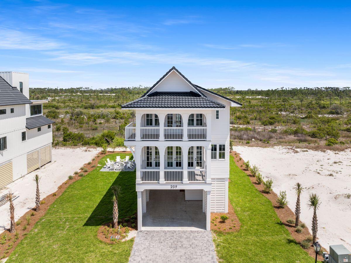 This thoughtfully crafted coastal haven rises just moments from the quiet shoreline, offering sunlit interiors, refined finishes, and outdoor spaces that turn evenings into memories. With multiple king suites, generous gathering areas, and breezy upper-level porches that catch soft gulf views, the home is designed to host large families and groups with comfort and style.

A spacious fire pit anchors the backyard for starlit nights and relaxed conversation, while the chef-inspired kitchen, butler's pantry, and open living room set the stage for effortless entertaining. Across three beautifully planned levels, every detail invites unwinding, reconnecting, and savoring the slower rhythm of the coast. On the entry level, a welcoming foyer leads to ample under-house parking, ideal for guests arriving with beach gear or carts. The main living floor unfolds with an expansive gathering space, anchored by a polished kitchen with high-end appliances, a beverage cooler, a wet bar, and island seating for five. A dining area for 10 keeps everyone connected during meals, and a serene king suite completes this level.

Upstairs, two primary suites offer private balconies and spa-like baths with walk-in showers and double vanities. Another king bedroom and a bunk room with twin-over-twin bunks share a hall bath with a tub and shower combination. A dedicated laundry room with a soaking sink adds convenience for extended stays.

Outdoor living is every bit as inviting as the interiors. Covered porches offer shaded spots for morning coffee or afternoon reading, and the large custom fire pit creates an intimate focal point for gathering after sunset. High-speed Wi-Fi, smart TVs, and thoughtful touches throughout ensure comfort for every guest.

Parking is generous, with room for four to five vehicles in the driveway and access to abundant overflow parking nearby. Electric golf carts are permitted, making it easy to reach the beach and explore the surrounding area.

Set within a private, gated coastal enclave, the home enjoys walkability to quiet gulf-front sand, future community amenities, and the conveniences of nearby shops and dining. With new-construction craftsmanship, multiple king suites, peek-a-boo gulf views, and a layout perfectly suited for groups, this exceptional retreat pairs modern comfort with a relaxed coastal spirit.
