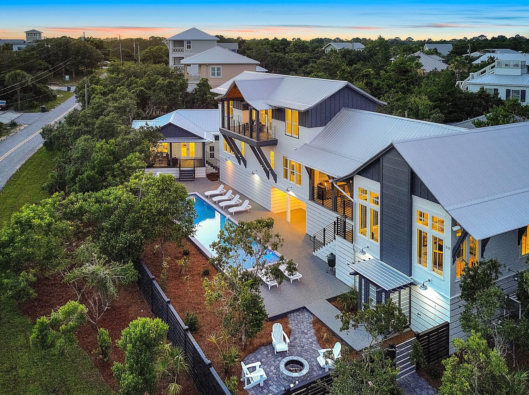 This unique urban designed home is a rental machine. This 30A custom home begins at 5,093 sq ft with gulf views from many rooms of the house! The incredible homes architect is Tyler Doin. The 5 bedroom/5.5 bath home w/ stand out exterior features makes this design a ''one of kind'' along 30A. No corner, trim, wall, or any other building detail was left untouched by Limbach Developments. This homes layout flows from room to room w/ details such as antique chestnut cabinets, copper niche and sinks, cantilevered streamlined bunk beds, waterfall silestone counters, and modern industrial concrete lighting. The large and inviting outdoor space includes a 12x50 ft. heated pool w/ a sun shelf. firepit, outdoor shower and large outdoor kitchen area and grill. The incredible outdoor space has several balconies and porches to enjoy the breeze or take a peak at the Gulf. 
The large kitchen area boasts all wolf and subzero appliances, wetbar and adjoins a well appointed living area with a sonos surround system.
The homes urban interior design was done by Kimberly Tipton. She definitely outdid herself on this one!