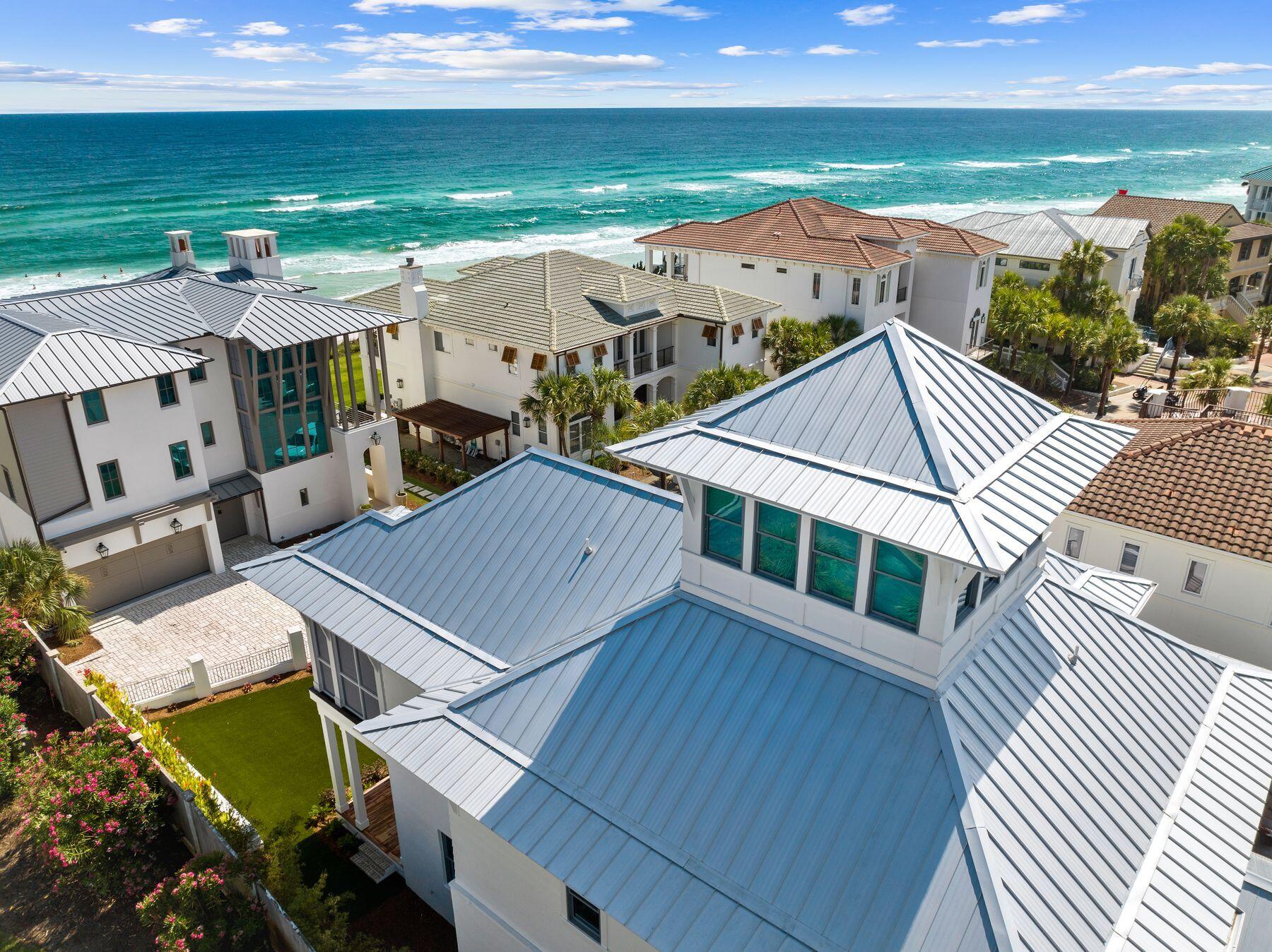 Welcome to this meticulously crafted coastal-contemporary retreat nestled in The Village of White Cliffs along Scenic Highway 30A. Designed by renowned architect Chris Stoyles of Archiscapes and built by Grand Bay Construction in 2023, this luxurious four-bedroom home is situated just steps away from the Gulf of Mexico, boasting an array of modern amenities and breathtaking second-row views. Upon entering, you are greeted by spacious interiors featuring 12-foot ceilings, engineered hardwood floors with a custom finish, and Sierra Pacific FeelSafe Double Hung Windows that are tinted for privacy and safe for local wildlife. The expansive guest bedrooms, each complete with en-suite bathrooms and walk-in closets, offer unparalleled comfort and privacy. The first level offers an oversized one-car garage with custom storage solutions, a spacious laundry room and a private elevator. Located on the second-level, the primary suite offers comfort and privacy with a spacious en-suite bathroom with dual vanities, a soaking tub and large walk-in shower. The heart of the home is the chef's kitchen, equipped with KitchenAid commercial appliances, a wine fridge, drawer microwave and quartz countertops throughout. A custom wall pantry with soft-close shelves complements the sleek design, ideal for culinary enthusiasts. The expansive kitchen seamlessly flows into the dining and living areas opening up to the wraparound deck with impressive views of the gulf. Additionally, a third-level offers a flex space for use as an office, crafting space, or exercise room along with unfinished storage areas. For relaxation and entertainment, the home features a conditioned cupola providing 180-degree views of the Gulf, a perfect setting for enjoying sunsets. Outdoor living is enhanced by wrap-around Cumaru wood decks with ceiling fans and custom horizontal railings, creating inviting spaces to enjoy the coastal climate. A large artificial turf front yard and a seven-person hot tub complete the outdoor experience. Residents of The Village of White Cliffs enjoy a rental-restricted environment with a gated entry and access to exclusive amenities including a private beach, clubhouse with a full kitchen, lounge area, billiards room, fitness center, tennis and pickleball court, and a community pool. This coastal sanctuary offers the ultimate blend of luxury, tranquility and community, making it a rare find along Scenic Highway 30A.