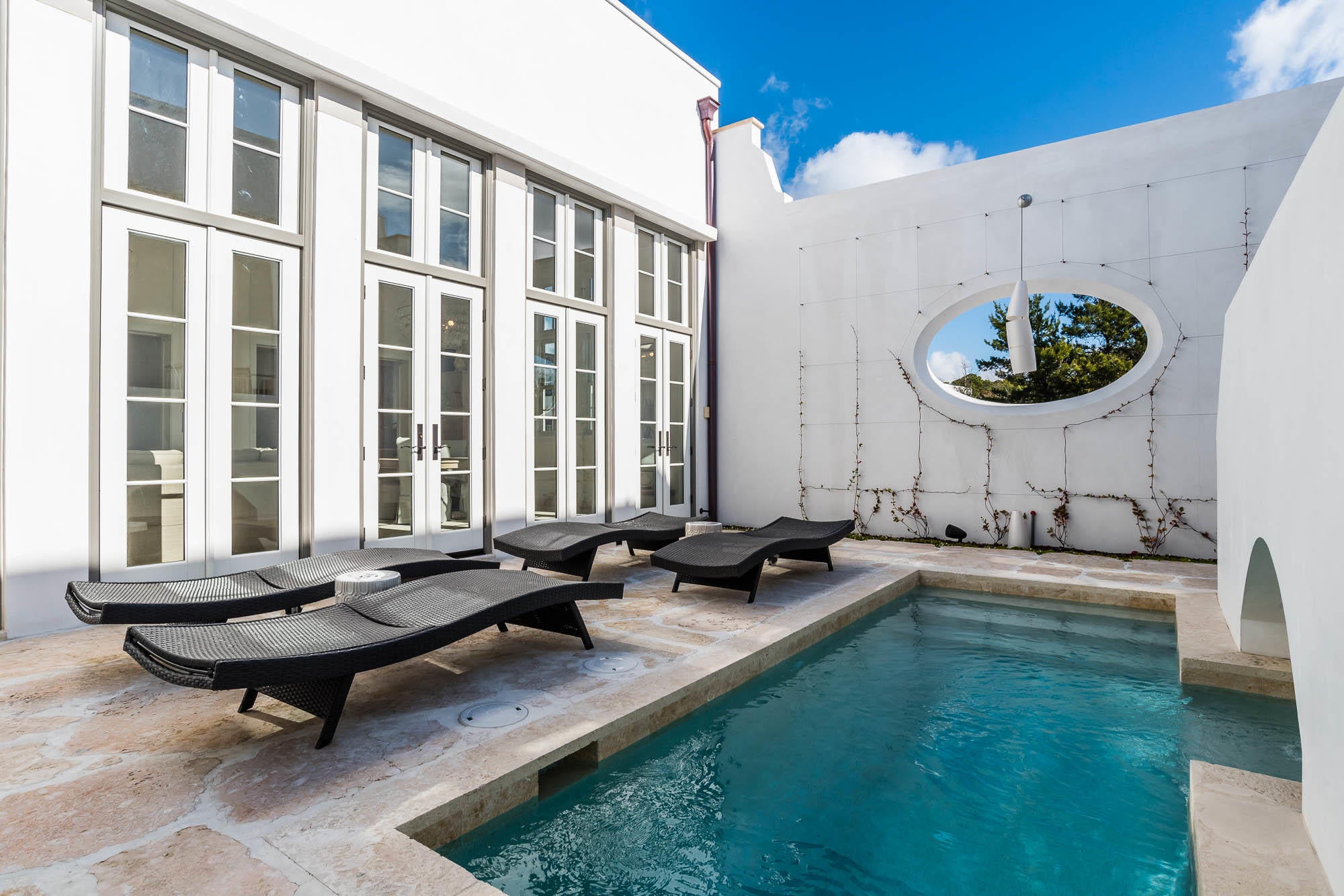 Exceptional location and beautiful architectural details woven into every space of this 4 Bedroom, 4.5 Bath home make this a rare find. Fall under the spell of sophisticated coastal living in a corner situated light-filled private oasis. Caliza Courts rowhomes are designed by the renowned Khoury-Vogt Architecture team and form a welcome addition to the breathtaking Caliza Pool location.
Impressive scale of the great room awes with 16-foot ceiling,12-foot tall French doors and windows opening to a private courtyard complete with private heated pool, and guest suite beyond. Floor plan offers the utmost in comfort to accommodate friends and families. Venetian Plaster reflects the elegance of the surroundings. The open concept kitchen offers top of the line Thermador appliances, oak cabinetry, and quartz tile accented walls.
The main level Master Suite creates an expansive feel as it occupies the northwest corner above the iconic streetscape.  An elegant soaking tub, shower with Dominican Shellstone tile-surround floor to ceiling and twin vanities complete the Master Bath. Two Guest Suites, each with private baths are perched on the second floor, and enjoy a private Cuban tile accented west facing porch.
Breezes enhance the private courtyard, accentuated by a serene, heated dipping pool, dining area, Dominican Shellstone paving, and easy to maintain espalier landscaping. Across the court, a covered, open-air loggia fronts a much-desired private guest suite (fourth bedroom), both raised above a two-car garage. Adding to the private experience, this suite has the midnight kitchen feature. The loggia offers another area for lounging, watching TV and dining.
Excellent rental history, available upon request. Furnishings and electronics are not included in the price, but may be purchased.