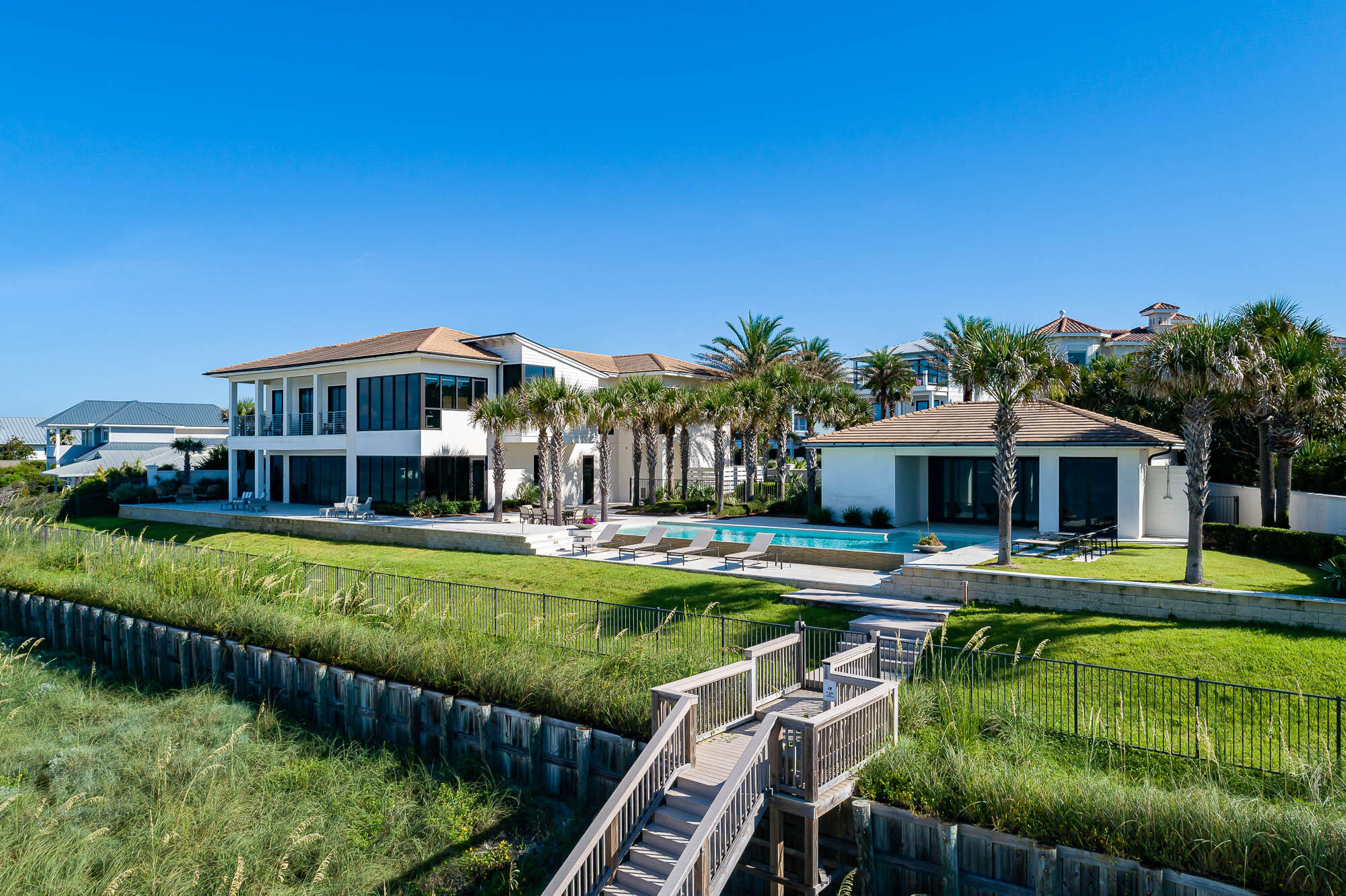 A notably rare opportunity to purchase a sprawling beach estate spanning 220 feet on the Gulf, on 30A's prime east end. This sale includes two Gulf-front lots. Exclusive and private, this waterfront estate is the largest gulf-front home site available along Scenic Highway 30A. Enjoy your home, guest home, and pool on 220 feet of pristine white beaches on the Emerald Coast. This beachside home is solidly built, and secure with gated entry, surrounded by a 6-foot privacy wall, and has an approved seawall that is deemed permanent by the Florida Department of Environmental Protection. Located in the gated community of Pelican Pointe, this prominent location is on 30A's east end, adjacent to the coastal dune lake of Camp Creek Lake, lending a quiet serenity, while also close to the lively neighboring planned communities of Alys Beach, Rosemary Beach and Watersound.  Northwest Florida Beaches International Airport is a convenient 30-minute drive. Entirely renovated in 2015, prominent architect Geoff Chick and reputable builder Richard Swift collaborated to create a custom modern design that showcased the elements of the expansive waterfrontage.  The home has never been rented and is impeccably maintained. 
The property is ideally designed for comfortable coastal living, with the main residence of two stories lending 4 bedrooms and an additional 5th bedroom in the fully-appointed detached guest house, located poolside. Discover the luxury of a coastal estate with the largest amount of waterfrontage available on the market.