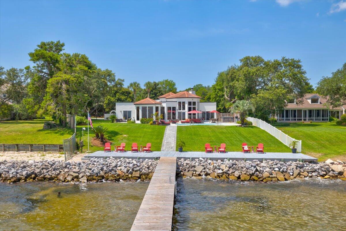 One of A Kind, Incredible, Panoramic VIEWS from the living area of this home ....unprecedented, spacious, Lot/Home that not only allows for real enjoyment & entertaining, but is also centrally located in the heart of Destin! Secluded, while convenient, all at the same time.  Located on an acre waterfront is this contemporary but warm 4bed 4bath home, with a beautifully finished winding, paver drive that leads you to a grand entrance and 3 car garage! From the foyer, you're instantly drawn to the back of the home  and the water with almost 180 degree views of the water through the floor to ceiling windows that bring the outside in, by allowing a full view of the pool, immense, green lawn, clear bay waters, dock/boat lift, with sun deck above.  You will never tire of enjoying the views!! Single story home , gated entrance with stone wall border.  This home had extensive renovation prior to this owners purchase and since the current owners have added paver driveway, patios and path to water, renovated guest baths, interior and exterior paint, new dock and extra rip rap at seawall and an epoxy coated pool deck.  New carpet was just installed in the master suite. Flat roof was recoated with a TPO  membrane in 2017 with a 10 year warranty. 
This lot has one the highest elevations along the bay in Destin - 13-15ft  above sea level, flood zone x.   Easy and quick access to shopping and dining  thru back streets without fighting traffic on 98. Just 10 minutes to Destin Executive Airport.   Boating access to the bay, Crab Island and the Gulf can be spur of the moment as you are just 10 minutes to Crab island and Destin's East Pass.
Water depth at the end of the Dock is approx 3.5 to 4 ft and even in the winter time there is not an issue with putting the boat in the water .  Dock is over 3,000 sq ft with an upper deck covering the boat and lift . Upland deck along seawall was just rebuilt and has all new pressure treated decking for an additional  1000 sq + of outdoor entertainment space along the water 
There is room on this almost 1 acre lot to add additional space to home as well as a detached guest house

The water quality at the dock is usually crystal clear with a blue hue because we are located so close to the gulf.  The clear water allows you to see what is in the water when you are enjoying playing or paddle boarding. You can also "sight fish" for speckled trout, redfish and flounder. Lots of crabs to be caught around the dock.  See sealife to include Dolphin feeding on bait fish, a rare manatee or sea turtle can also be seen.
You even have your own pet Blue Heron   "Harriett"    She has been part of the past 2 owners family.  Per the owner " She will come to the bedroom door and quietly wait for you to wake if you sleep too late in the morning and then follow you to the kitchen. She will stand and wait patiently while you are cleaning fish for you to throw her some scraps.

The owner says "This home is about fun, boating, fishing, relaxing, entertaining, seclusion and quality of Life !!"