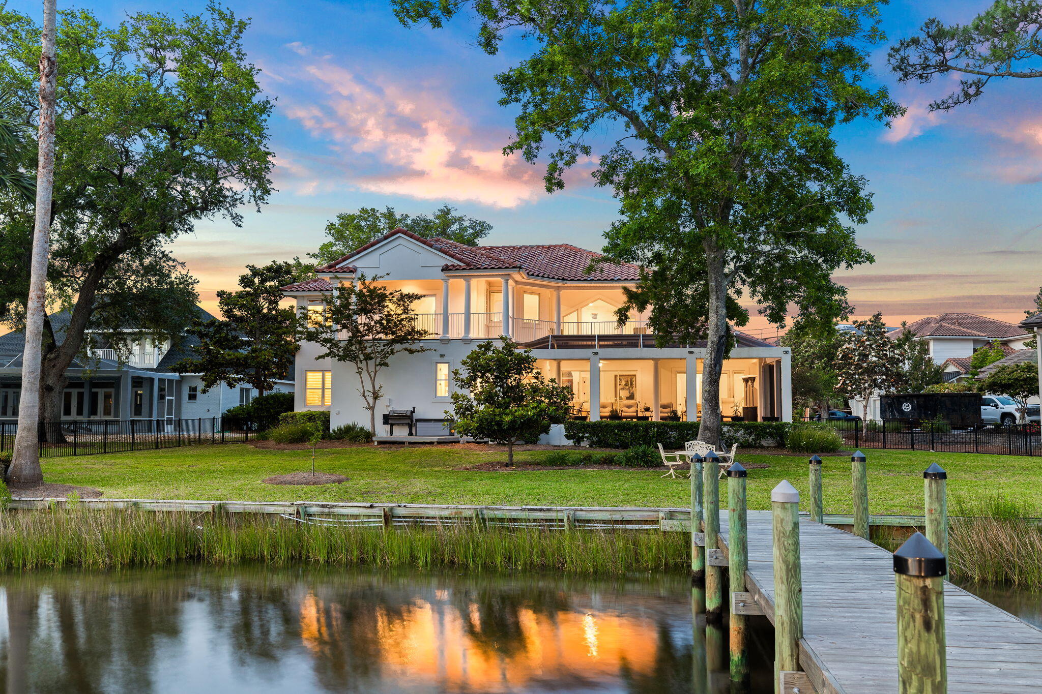 Welcome to your sanctuary nestled along the serene shores of Honeymoon Cove, a deep water bayou. This stately residence boasts 150 feet of water frontage on over 1//2 an acre in the gated and serene community of Grand Cove, offering the ultimate in exclusivity and privacy. Majestic, lumbering Oak trees frame the landscape of this picturesque home, providing a stately backdrop to this elegant estate. A new dock and boat lift beckon boating and fishing enthusiasts,