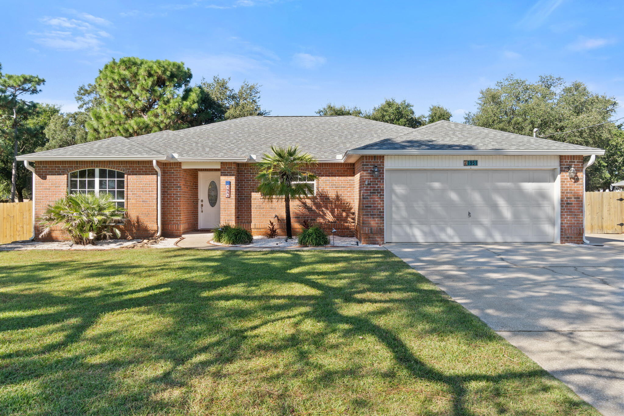 Welcome to this well-maintained, brick home in Holley By The Sea! This spacious property features 3 bedrooms, 2 full bathrooms & a bonus room. Situated on a 0.45 acre lot with a fully fenced backyard, a large yard building equipped with electricity & heating and air, & a carport in the backyard -  perfect for parking your RV or boat. You'll find tons of updates throughout the home, including a beautifully updated kitchen with new countertops & backsplash, painted cabinets, & new stainless steel refrigerator & microwave! 2022 HVAC and 2022 Gas Water Heater! New LVP flooring was installed throughout the living room & additional bedrooms! Outside you'll find, a new fire pit, and the updated yard building with new vinyl flooring, new interior and exterior paint, & a 2021 A/C unit!