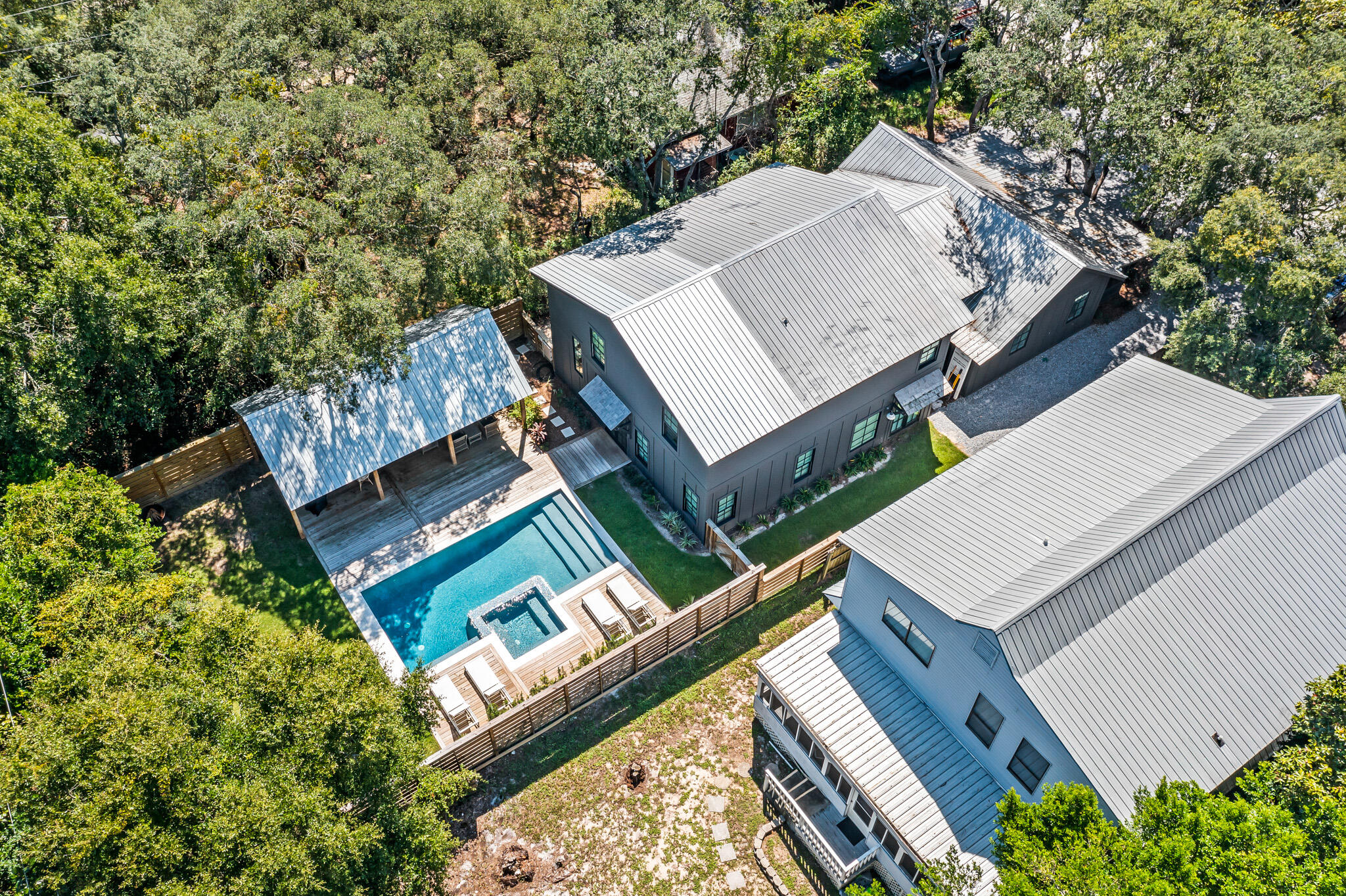 Welcome to 375 DeFuniak Street, offering the best of Grayton Beach. Just steps from the beach and popular dining options, and sheltered behind massive live oaks, sits an original 1953 Grayton Beach Cottage that has been expertly remodeled and expanded, preserving its Old Florida charm with modern luxury finishes. Upon entering this 6 bedroom, 4.5 bath home, you are greeted by 15-foot vaulted ceilings defining a large open kitchen on one end and a comfortable great room on the other end. The kitchen is outfitted with top-of-the-line appliances, including a six-burner Wolf Range, custom cypress cabinets, an under-counter ice maker, and a dramatic oversized range hood. The large kitchen island has ample seating for 6, and a side pantry nook houses small kitchen appliances and dry goods.

Across from the kitchen, the great room is anchored by a custom gas fireplace and is outfitted with comfortable furniture that invites relaxation.

The remainder of the downstairs features a charming dining nook, a large laundry/mud room with extensive storage and an additional full-size refrigerator, a powder bath, and 2 king master suites, each with their own bathroom.

Upstairs, 3 queen bedrooms and a bunk room share 2 generously size bathrooms and an upstairs laundry room.

Now let's talk about the back yard! The generously-sized fenced backyard highlights a substantial resort-style heated saltwater pool with hot tub. The custom outdoor pool pavilion was built with vaulted ceilings to shelter comfortable seating and dining areas, as well as a gas grill, making outdoor living a delight.

Throughout the home you will find handmade Moroccan Zellige tile, reclaimed oak floors, and custom lighting and accents. The doors and windows have all been replaced and upgraded to meet current Hurricane standards. There is a side storage room to house all your beach equipment and bicycles, and the front of the house has ample parking for 7 vehicles. Come take a look and see what the best of Grayton has to offer.