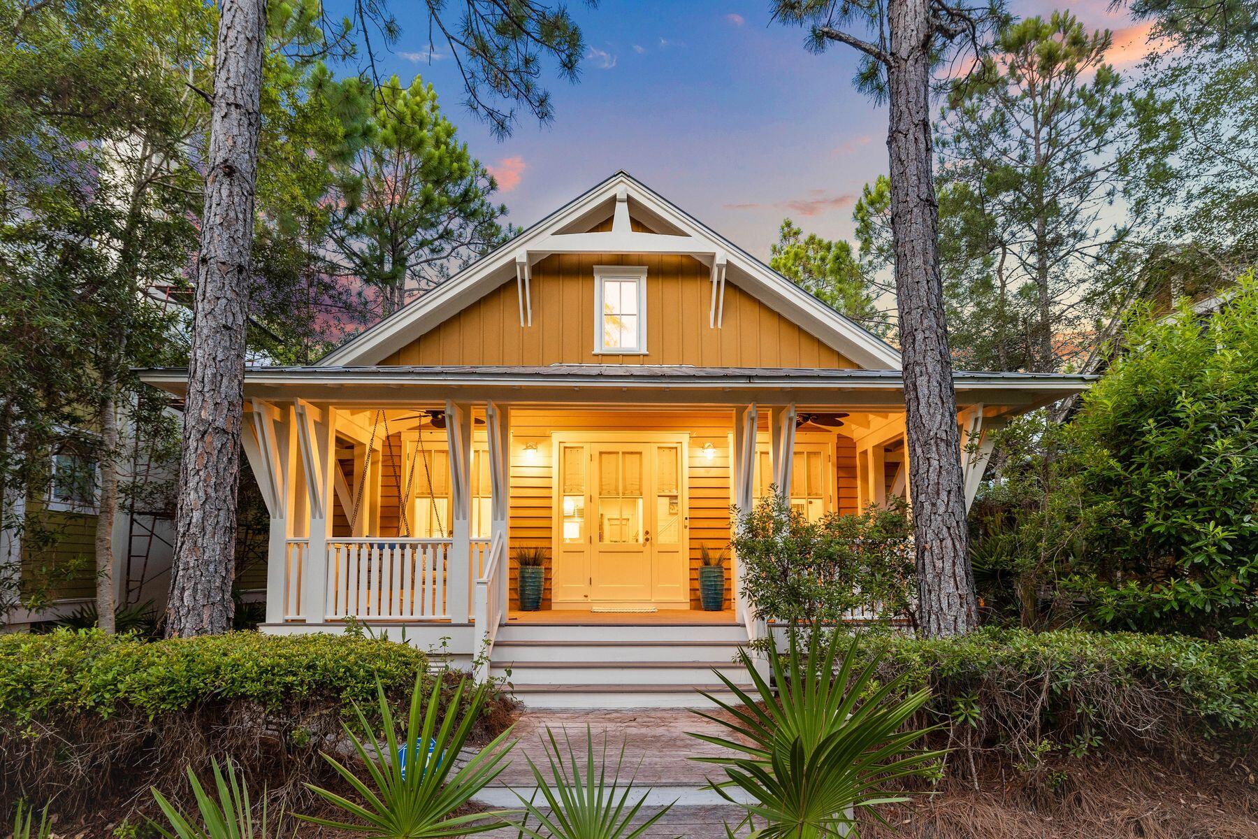Discover the allure of this delightful Florida cottage with carriage house nestled naturally in tree-lined surroundings. To the front, this charming home has a large front porch overlooking a green pocket park. To the rear, a paved driveway provides access to a detached carriage house above the two-car garage. Step inside to find a light and open great room with soaring ceilings and multiple windows enhancing this well-planned space. Hardwood flooring flows through the sitting room and kitchen into the dining room, easily seating eight people for dinner. The kitchen is well-appointed with crisp white cabinets, veined granite countertops and glass wall tiles. Wolf and Sub-Zero stainless appliances and a twin butler's sink make this an area of culinary creativity. The first-floor master includes a generously sized bathroom with a twin vanity and a large walk-in shower. Stairs lead up to a loft/sitting area with custom built in bunk beds and additional guest bedroom and bath. Independent family members and guests can enjoy their own privacy in the well-appointed carriage house. As well as a bedroom and bathroom, it has a fully equipped kitchenette with everything you need to prepare breakfast, drinks and snacks. Outdoor living can be enjoyed on the screened back porch, leading to a deck perfect for barbecuing and alfresco dining.  It complements the large front porch where you can enjoy your morning coffee in a very peaceful setting. WaterColor amenities are hard to beat, with nine community pools, pocket parks, shops, restaurants, walking/biking trails, and tennis and pickleball courts. Kids will love the lazy river and water-based fun at Camp WaterColor. There's even a fully stocked boathouse on the 220-acre Western Lake. Try your hand at kayaking and paddleboarding surrounded by nature on this remarkable coastal dune lake. The nearby beach offers sunning, swimming, and sunset strolls, or you can use the excellent facilities at the private beach club. It's all part of the idyllic WaterColor lifestyle.