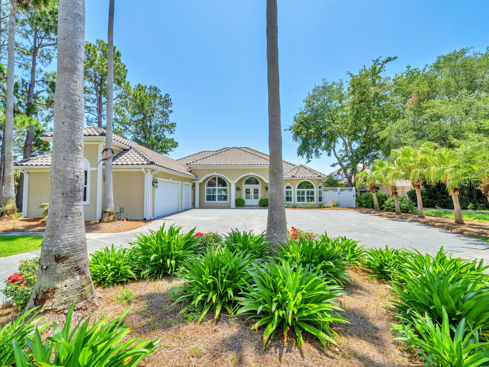 ATTENTION BOATERS! GORGEOUS WATERFRONT ESTATE 5 MINUTES TO THE BEACH or GULF! With almost an acre of land, this property is the epitome of coastal living! This gorgeous one story pool home, designed with an open layout, consists of 3636sf, 4 beds/3.5 baths, oversized 3 car garage, and premium outdoor living with pool, spa, outdoor kitchen, boat dock, boat house, and a spectacular view of the deep blue waters of Grand Lagoon! 

As you drive through the columns and up the 500' circle drive lined with lush, tropical palm trees, you will begin to appreciate this beautiful home! Upon entering, you will love the spacious feel, accentuated by the 10ft - 12ft ceilings showcased in the formal living and dining areas, which are situated in the center of the home and perfect for entertaining! The dining area invites even the largest of dining sets, as well as a formal seating area with large double doors that open up to the covered patio and pool area. 

As you continue through this custom home, you will appreciate the dream kitchen with its optimal amount of cabinet space, island with a second kitchen sink, breakfast bar to seat 4-5, and darling breakfast nook tucked inside a bay window that overlooks the pool area. Recent upgrades to the kitchen include new quartz kitchen countertops, new sinks & faucets and all new stainless appliances, including a double oven & wine refrigerator! The kitchen's full breakfast bar was designed to tie into the adjoining informal living space with gas fireplace, cozy reading nook with window seat with special lighting. The living areas are located in the center of the home, with two full bedrooms and bathrooms located on one side, and the master suite and 4th bedroom/office located on the the opposite side of the home. It is the ideal layout. The enormous master suite boasts it's own marble fireplace, 2 separate sitting areas, with plenty of room for extra large furniture, 2 walk in closets, and a renovated master bath with walk in shower and separate whirlpool tub. 

As you proceed through one of the 3 separate sets of French doors, you will fall in love with this backyard oasis! There is more than enough space to accommodate everything from making memories with your family to entertaining even the largest group of guests! Whether you are cooking for the kids, or hiring a catering company for parties, the summer kitchen is the perfect place for preparation. It has everything you need - refrigerator, sink, gas stovetop, and full bar to the outside. There is an automated enclosure to roll down when the kitchen is not in use, or for inclement weather. Another ingredient creating the perfect outdoor experience for all occasions, is he heated pool & spa. Its customized lighting adds the perfect ambiance to your evenings by the pool.

Just beyond the pool & patios is the ideal amount of green space, all sitting on almost an acre of land, beautifully landscaped with a large custom shed and 90' of waterfront along a 1000' wide, beautiful stretch of Grand Lagoon. Stroll down your private dock and enjoy all that living on the water has to offer! Park your boat right in your own back yard, and get ready to enjoy fishing, boating, and all your favorite water activities like never before! 

The list of upgrades and extras goes on and on - hookups to accommodate any size RV, a custom shed, new tile roof, new storm windows & doors, renovated baths, Rinnai tankless water heater, plantation shutters, wireless home security system, whole lawn irrigation system with well, and no HOA. That means you have options you won't find in restricted subdivisions, from raising chickens for fresh eggs, to boat and RV parking, to adding an additional structure. It's time to make this one of a kind property your own perfect paradise!

 All information is approximate and should be verified by buyer.