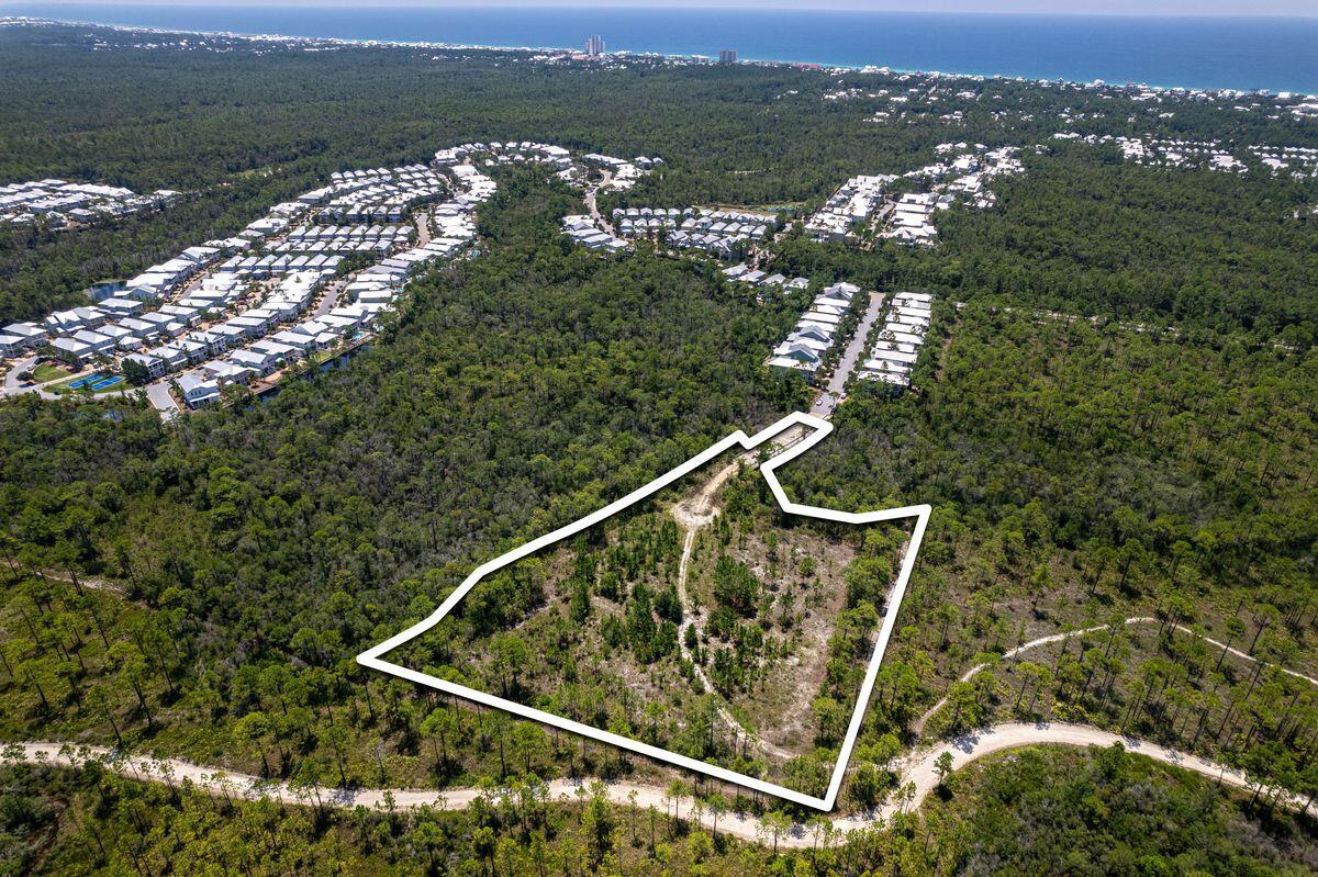 Presenting a remarkable opportunity within the esteemed NatureWalk Community Development District, this 3.2-acre parcel of land unveils a world of potential. While distinct from the NatureWalk HOA, this developable expanse bears its own exceptional character. Conveying with a collection of 24 townhome units in a pre-approved development order, it stands poised to grace Walton County with an embodiment of sophisticated living. The pièce de résistance of this community will be the splendid neighborhood pool, a captivating focal point that will elevate the living experience. Each townhome unit will boast a view that encapsulates the allure of Point Washington State Forest or the tranquil embrace of the pond and pool.. With the notion of opulent living in mind, the floor plans unveil an intuitive arrangement. The primary living spaces flourish on the first floor, designed to cater to modern sensibilities. Transitioning to the second floor introduces a haven of luxury, featuring three bedrooms, two baths and a versatile bonus room. Elegance is intertwined with convenience. A full side-by-side laundry, along with a discreet powder bath on the first floor, attests to the thoughtful craftsmanship that defines these homes. Each dwelling is a testament to tasteful design, spanning two stories and embracing 1,750 square feet of refined living. Furthermore, discerning homeowners have the option to transcend the ordinary. The possibility of an additional third story awaits, allowing for an expansion of 550 square feet per townhome. This can bring the total square footage to 2300 square feet.  Beargrass Way, the premiere street within NatureWalk, cradles this distinguished development. With its coveted position near the front of the community, seamless accessibility to WaterColor and Seaside, Florida, is a given, whether by golf cart or leisurely bike ride. Overall, this opportunity is a testament to sophisticated living, where architectural brilliance converges with the tranquility of nature. Engineering site plan, townhome floor plans and Letter of Agreement with the Naturewalk CDD are uploaded into the Documents section of this listing..