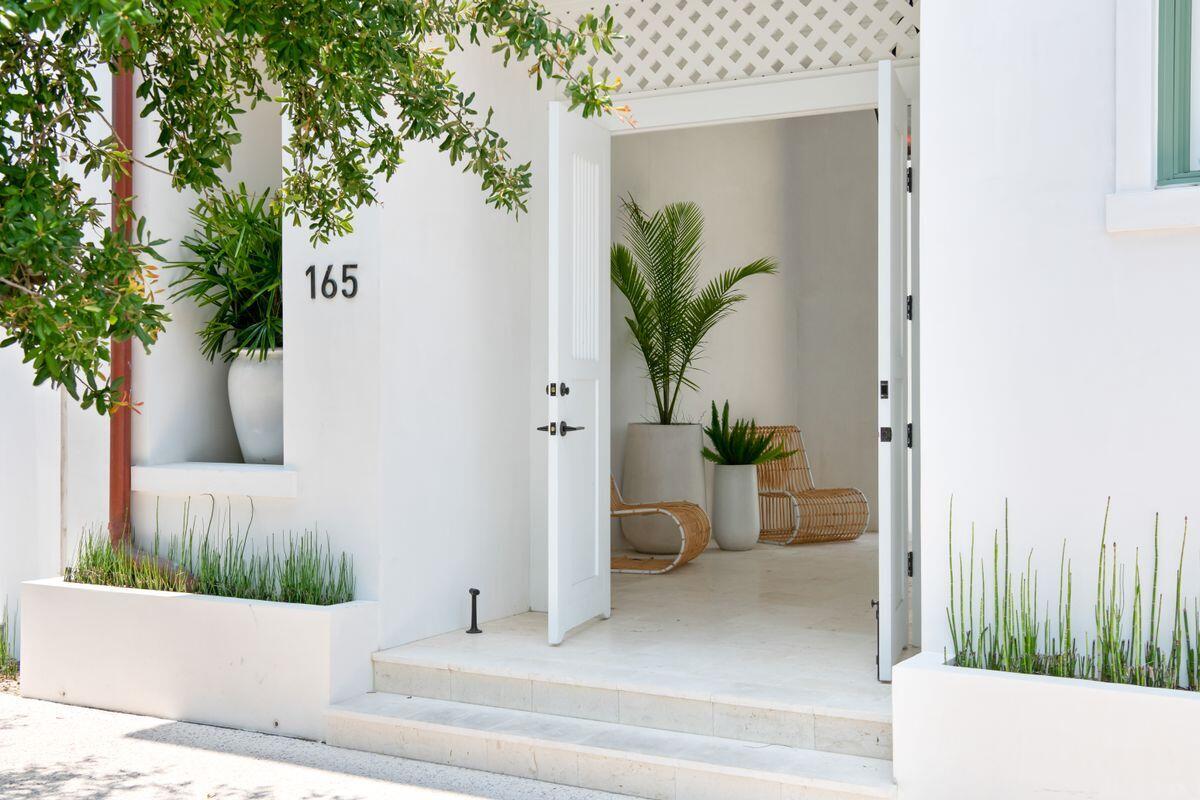 Creatively designed for those who appreciate the finer things in life, this noteworthy home by Brian Stackable is arranged around a private courtyard pool with a stunning waterfall feature. Ideal for laid-back entertaining, this pristine new build has multiple outdoor living spaces including a large rooftop terrace for enjoying sunset drinks. Tucked behind a privacy wall with an artisan-inspired gateway, this elegant retreat showcases the highest standards of quality with thick-cut marble and bronze hardware throughout. It offers alluring views of the aquamarine plunge pool from most rooms. The social kitchen has a wealth of appliances including a 60-inch Wolf range, a full-height wine cooler and a butler's pantry for entertaining in style. Multiple tall windows reach up to the oak-beamed ceiling, introducing an abundance of natural light. The all-white decor creates a bright open living space beyond the lengthy island bar. There are defined areas for conversation and an intimate dining nook overlooking the pool. The first-floor primary suite has French doors opening onto the courtyard for peaceful morning views enhanced by a shady Washingtonian Palm. Fashionistas will appreciate the spacious walk-in closet with pocket doors and built-ins designed by California Closets. Three additional guest bedrooms are on the second floor, all with luxury ensuite bathrooms. The upper floor also has a spacious entertainment room for gatherings, complete with a built-in beverage station. Doors open onto a balcony for guests to enjoy cool breezes and stunning pool views. The home has its own whole-home generator and the two-car garage takes care of vehicles, bicycles, golf carts and beach gear. Set in the heart of Alys Beach, this magnificent home is positioned on a picturesque, tree-lined street facing Papilio Park with a nature preserve nearby. Caliza pool, local cafes, restaurants and shops are a short walk or bike ride away and the stunning white sandy beach is a five-minute stroll from the door. Renderings are conceptual for representational purposes only and subject to variances.