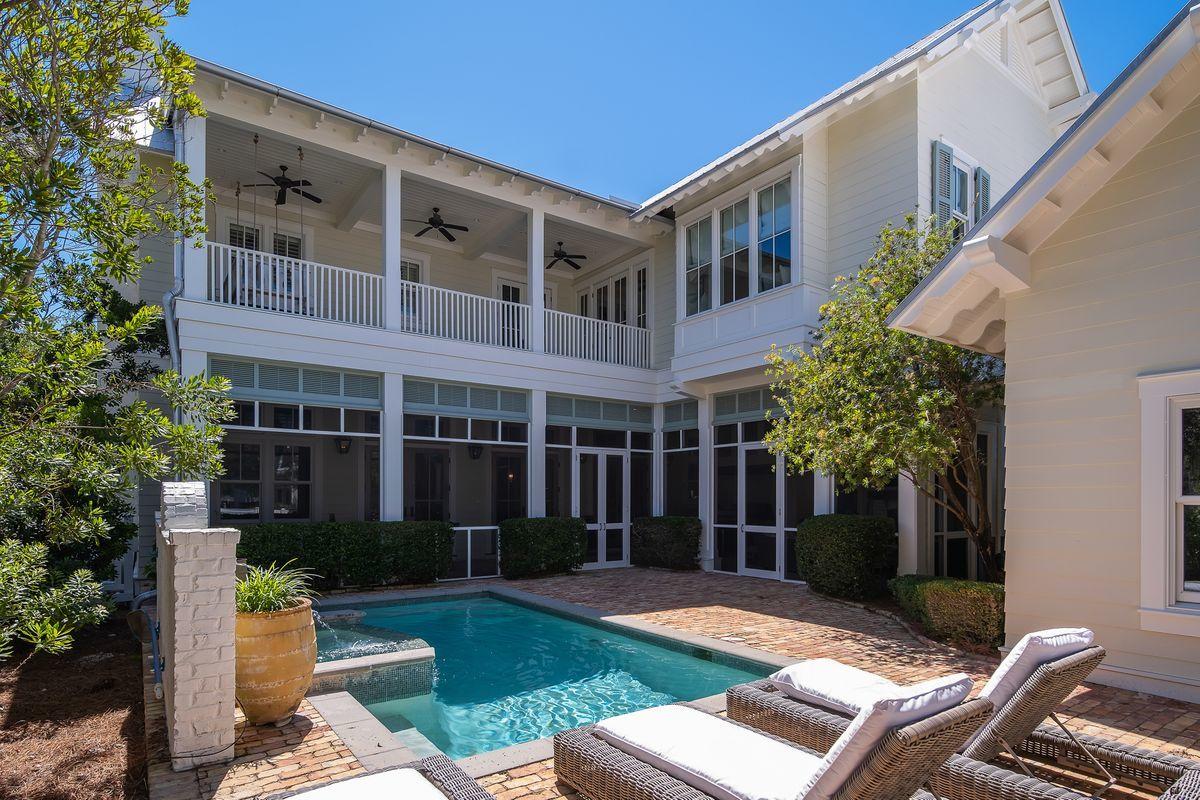 Come see what happens in the rare instance of when luxury, elegance, sophistication, class and location meet at the beach. Seeing is believing and you should see this stunning home in the coveted community of WaterColor just across from an expansive wooded open space! This beautifully crafted home features several thoughtful touches and custom details that are apparent from the moment you enter this home. Including sunken cypress wood for the French door entry way and living room doors adds to the beauty and sophistication. An arched white Chicago brick foyer with antique oak beams over the doorway greets you. There are additional beams in the first-floor family gathering room along with an antique ceiling of poplar and pine that are all estimated to be over 150 years old.
CONTINUED: As you pass through the foyer you pass a spiral staircase and one of four Master bedrooms on the right. The arched foyer leads you into the large yet warm first floor-family gathering room with a white brick fireplace on your right and an open gourmet kitchen all with high-end appliances on your left. The outdoor living space is off these rooms.

This 5,529-square-foot exquisite and immaculately maintained home includes a two-car garage with additional parking space for 3 more cars off of the alley in the back. Enjoy your private pool with a Chicago brick deck, as well as the large inviting screened outdoor family gathering room complete with an outdoor kitchen, dining area, and living area  including a large TV over this fireplace. This home has so many extras, this is why you have to see this house including four bedrooms on the second floor along with a Masters Suite that takes up most of the back half of the second floor with a sitting area and deck, large master bath and that has a his and hers walk-in closet at the end of the bath. The third floor has yet another warm family gathering room that has 6 bunks off to the right with a hand painted floor with the 6th large bedroom off to the left and is easily accessed by the elevator.

This elegant home is well-maintained and has never been rented, making it the perfect home or investment property and the owner has already prepaid all Beach Club and Camp WaterColor homeowner assessment.

Take advantage of several coveted WaterColor amenities, including the recently-renovated WaterColor Beach Club, which now offers three pools and three separate restaurants and two outdoor bars. This home is also conveniently located near one of now 9 community pools.