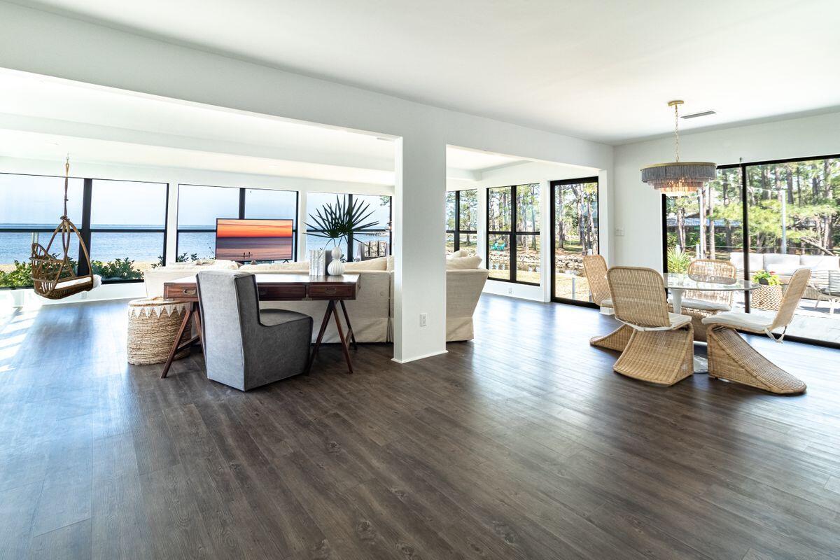 Contemporary coastal living on the bay seldom comes in a total package that includes a canopy of mature foliage, 400 feet of water frontage and a lovingly-restored bungalow with input from renowned architect Geoff Chick. Today's discerning buyer will appreciate a five-bedroom main home and artistic carriage home situated on nearly one acre on Choctawhatchee Bay, the perfect embodiment of privacy, luxury and Southern charm. Inspired by mid-century design, this elegantly furnished home offers luxury plank flooring throughout the living areas and hand-painted tile in each of its three baths. Timeless finishes in the kitchen and bath spaces are accented with custom lighting, classic fixtures and endless views of the bay from each of the home's four bedrooms.  Gated entry into the freshly-graded private drive creates a sense of arrival at this quintessential bay- and canal-front home, offering two boat slips, one of which offers covered storage as well as a lift. The impressive exposed-rafter carport showcases timeless Chick design, while the multi-room carriage house with covered parking provides additional storage, workspaces or accommodations. Located at the most northern peak of Hewett Point Road, this perfectly manicured compound offers easy access to the amenities of Grand Boulevard and is just moments away from the sugar-sand beaches of 30A.