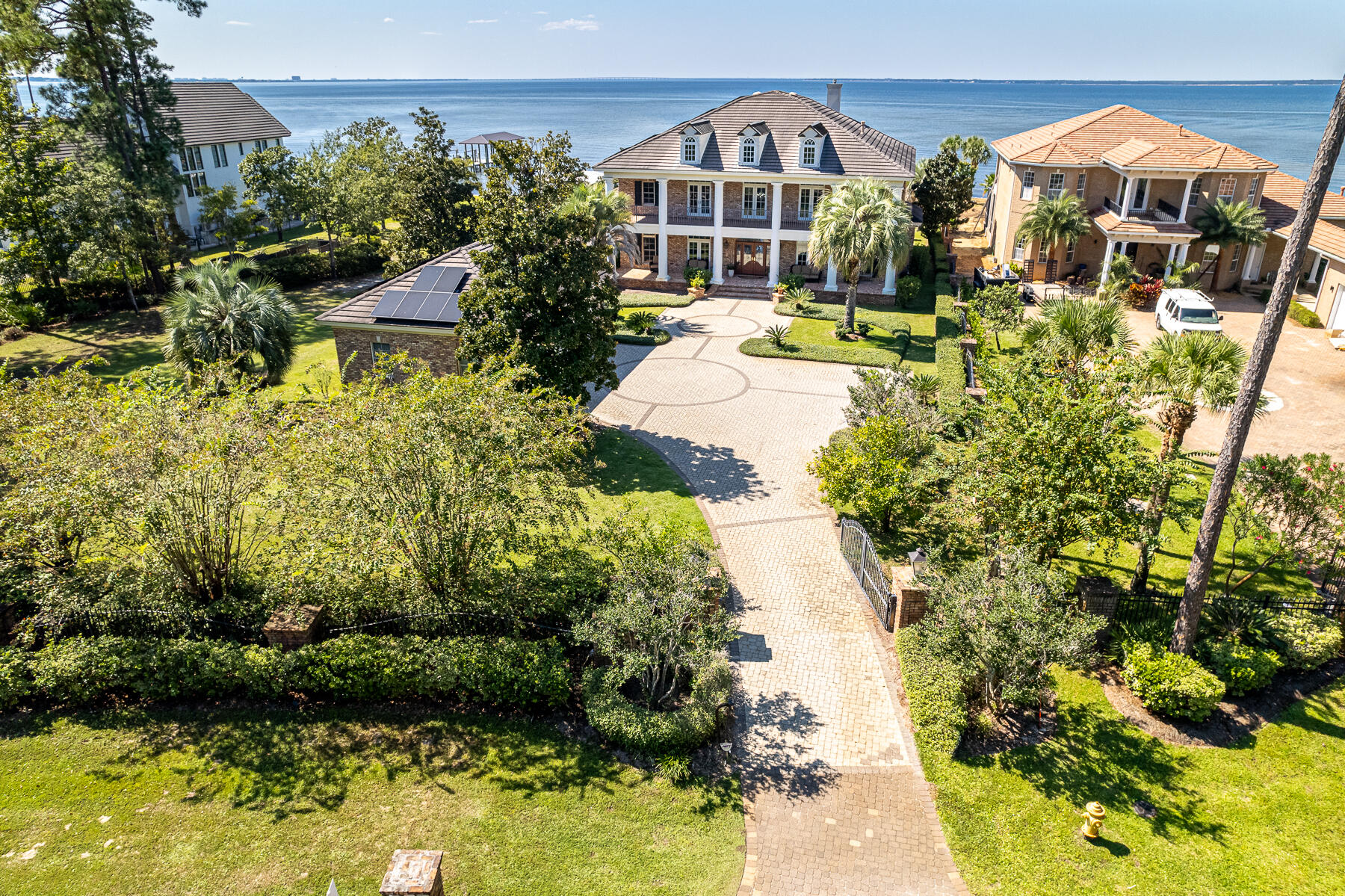 Majestic Bayfront estate with custom impressive details and an open floor plan where relaxed
living and southern hospitality flawlessly weave. Perfectly situated on nearly an acre on the Choctawhatchee Bay, this home boasts a gorgeous pool with a spacious patio, boat dock with lift, outdoor kitchen and bar area, private theater, gleaming hardwood flooring, and thoughtful details in every room. Double covered porches offer a shady place to unwind and enjoy year-round sunsets. Enter the gated driveway to lush landscaped grounds, complete with bountiful citrus trees and palms. The extra-large three car garage allows room for your leisure vehicle. Inside, a grand foyer opens to a sitting room and formal dining room with a butlers pantry leading to the kitchen. Majestic Bayfront estate with custom impressive details and an open floor plan where relaxed living and southern hospitality flawlessly weave. Perfectly situated on nearly an acre on the Choctawhatchee Bay, this home boasts a gorgeous pool with a spacious patio, boat dock with lift, outdoor kitchen and bar area, private theater, gleaming hardwood flooring, and thoughtful details in every room. Double covered porches offer a shady place to unwind and enjoy year-round sunsets. Enter the gated driveway to lush landscaped grounds, complete with bountiful citrus trees and palms. The extra-large three car garage allows room for your leisure vehicle. Inside, a grand foyer opens to a sitting room and formal dining room with a butlers pantry leading to the kitchen. The media closet is cleverly hidden in the hallway arches. Bay views are the star of the show and maximized by the large windows and porch access from the living room, kitchen, master suite, pool table room, and two upstairs guest suites. The spacious living room offers surround sound, a gas fireplace, and gorgeous wooden beams. A gourmet kitchen features an extra-large island, gas range, double ovens, wraparound bar with seating for six, and a walk-in pantry. The first-floor master wing is a serene escape with a fireplace, large bathroom with an appliance cabinet containing refrigerator drawers and a coffee maker, and a walk-in closet with a built-in vanity. An office, flex room with a full bath, laundry room, full pool bathroom and powder bath off the living room are also on the main level. Everyone gathers in the second level game room for pool and revelry after a day on the bay or around the pool. Watch the games from a recliner in the private theater. Four corner guest suites with full bathrooms ensure privacy and comfort. This west-facing lot along Driftwood road joins very few bayfront homes in enjoying year-round sunsets, expanded bay frontage, and estate-sized living. Please call for your private showing.