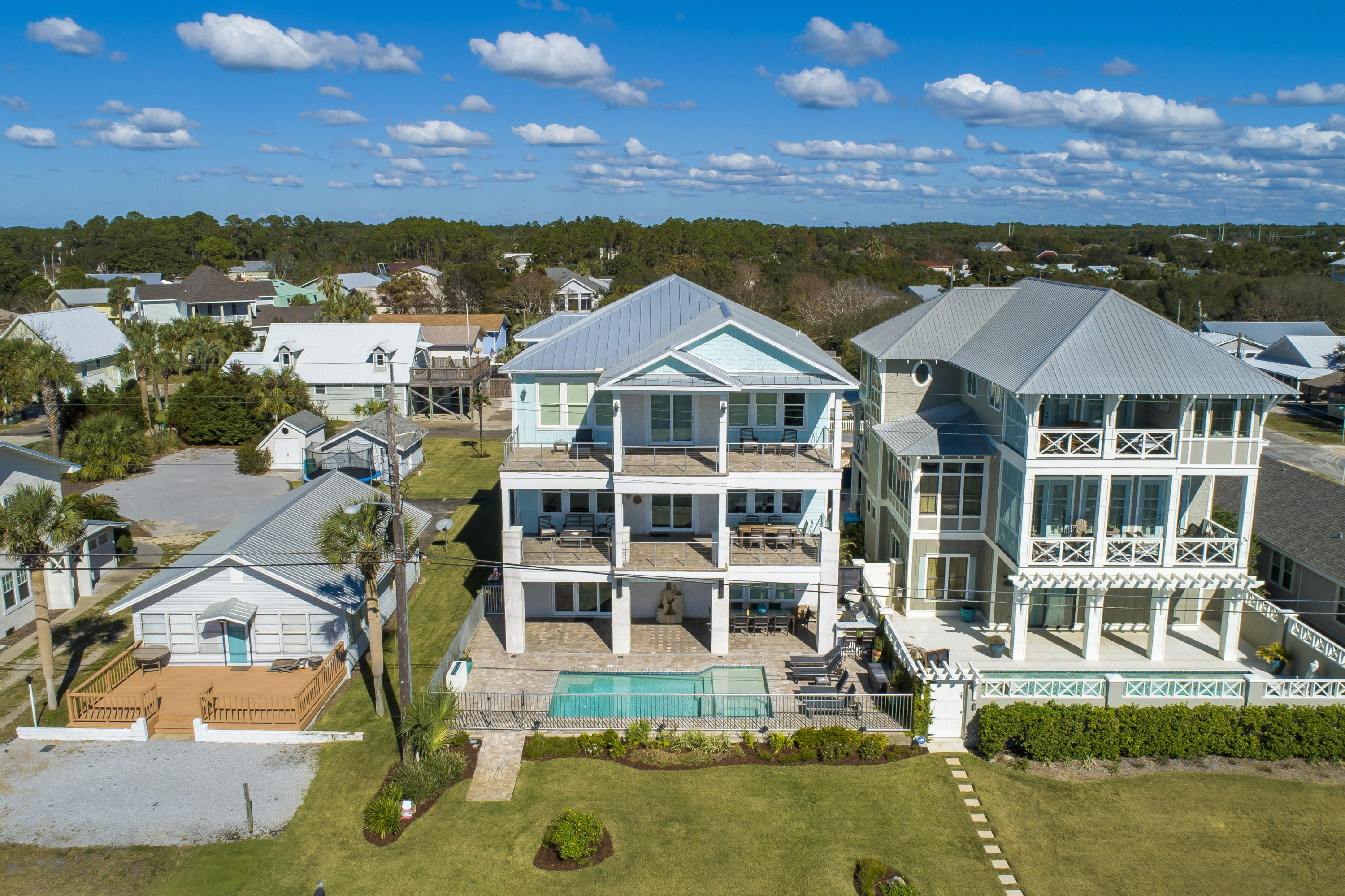 An absolute stunner of a CUSTOM built home with upgrades and views galore. This 5 bedroom, 4.5 bathroom home with over 4,800 square feet is perfectly located in Sunnyside featuring forever gulf views overlooking 10 acres of private beach that will never be developed. The construction details are endless including a solid concrete 1st floor, zip system waterproof construction, anodized aluminum pool & balcony railings and a standing seam aluminum roof with straps and roof deck in excess of what code required.  Enjoy the phenomenal custom upgrades in the home including custom solid wood cabinets throughout, a private pool, 1st floor game room, elevator, quartz countertops, tricked out 3 car garage with enough driveway space for all of your toys. We even have master bath barn doors and a custom mahogany table reclaimed from Jimmy Buffet's West Palm Beach Estate. One bedroom and bath along with the game room are located on the 1st floor. A very spacious open floor plan on the 2nd floor features incredible views, two bedrooms, living room, dining room and kitchen. The master suite on the 3rd floor covers every detail from forever gulf views to a custom MTI spa tub with aromatherapy and self drying system. Almost all of the furniture will remain including all TVs and teak outdoor furniture. This home is truly one of a kind when it comes to location, views, construction, and the list goes on.