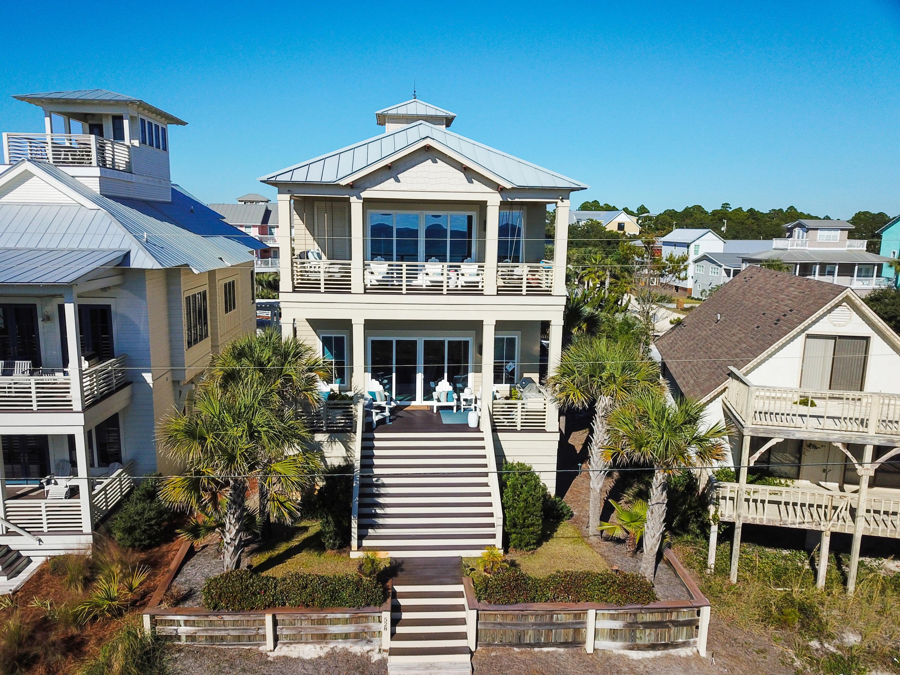 Now you can have it all: lifestyle, luxury, location with this Coastal retreat sited between the Gulf of Mexico and the Coastal Dune Lake, Eastern Lake. Offering incredible craftsmanship with modern amenities, this 5-bedroom, 4.5-bathroom estate with sweeping water views from all three levels. Stunning stone stacked fireplace and pecky cypress ceilings sets the tone for this masterful design and highlights the 4,021 sq ft open floor plan.
The great room opens to the rear patio, steps from the sugar sand and is the perfect balance of casual and elegance - ideal for entertaining large crowds or an intimate dinner party. The sleek Chef's kitchen will satisfy everyone with professional grade appliances complimented by the marble countertops atop an oversized center island and custom backsplash. The private and first floor master bedroom is the perfect retreat after a day of paddle boarding or kayaking on the Coastal Lake, offering a large walk in closet with a spa like master bathroom with over-sized shower.

Taking the elevator to the second and third floors, guest suites with private or shared baths await guests ready to rest after a day shopping in Rosemary Beach or biking down 30A. The second living area complete with a full kitchen and private balcony overlooking the emerald waters and over-sized bunk room for endless sleepovers make this a true coastal retreat. An outdoor shower, wind-rated doors & windows, and two-car garage complete the home. This sought-after Seagrove Beach home offers the ideal 30-A lifestyle in a neighborhood with no homeowners association & healthy rental projections for investors or second homeowners.