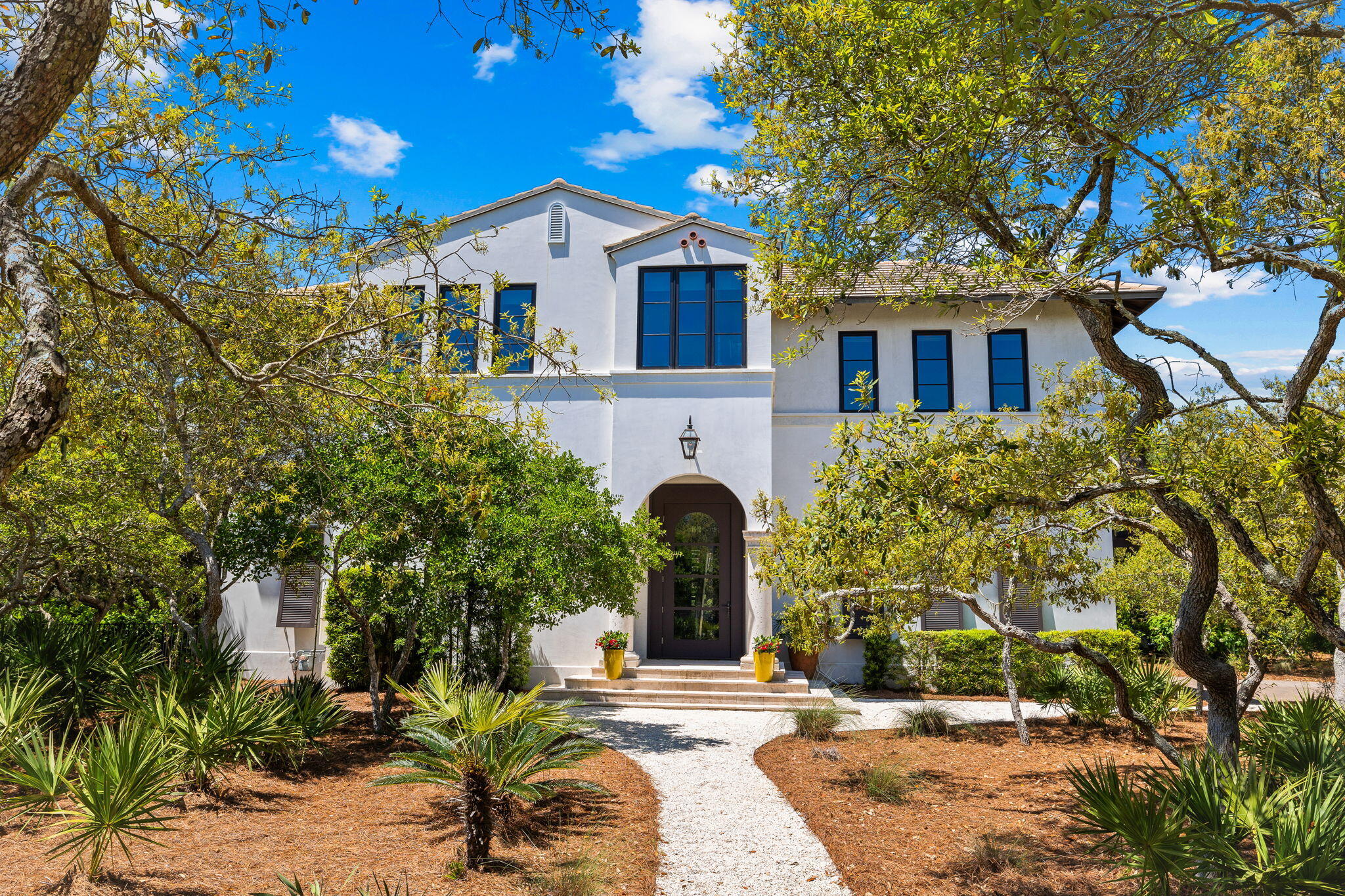 Welcome to beautiful 102 Sienna Court prominently located in Redfish Lane in Grayton Beach featuring a heated pool, three car garage and a dramatic art studio sited on a gracious half acre treed lot. Designed by renowned architect, Bill Sabella, and constructed by Arkon Group, 102 Sienna Court is solidly built of concrete and a testament to excellence throughout. This stunning custom home nestled among live oaks and indigenous vegetation presents a rare opportunity to experience timeless living in the enclave of Redfish Lane.  The architectural and interior design seamlessly blend with its natural surroundings, abundant natural light and reflect the owner and designer's ability to create a peaceful livable home amidst the backdrop of nature's beauty. This residence boasts hand-waxed natural oak flooring, polished concrete floors on the first level, custom-crafted artisan built-in furniture, ample sleek custom cabinetry and built in shelves throughout, a gas fireplace framed by built ins and striking floating staircase. The stunning living rooms' architectural beam design, hand-milled moldings, and marble slab countertops in the kitchen further contribute to the home's luxurious ambiance.  The chef's kitchen with high end appliances, ample countertops, and a series of windows beautifully marries the living room and dining room.  The dining room lets on to a balcony ideal for entertaining and grilling. A living room south facing balcony creates additional outdoor living space.  The romantic primary bedroom and luxurious bath, laundry room and office are conveniently located on the second-floor main living area. The first floor comprises the entry foyer, bunk room and guest suites. The art studio and a large porch with colonnade overlooks the sparkling heated salt water pool and enclosed lawn. As one explores the brick-paved streets, one is surrounded by the beauty of mature landscaping, providing coveted natural privacy.  Redfish Lane, located on Redfish Lake directly south of 30A is a "well-kept secret" comprised of only 18 graciously sized homesites cocooned by state forests and bordered by a coastal dune lake, offering a tranquil retreat into nature as well as a community boat dock. Little Redfish is close to eateries, or one can hop on the 30A bike path and explore the shopping, dining and entertainment of the nearby coastal towns. We invite you to make an appointment today to discover the beauty of living in Redfish Lane at 102 Sienna Court.