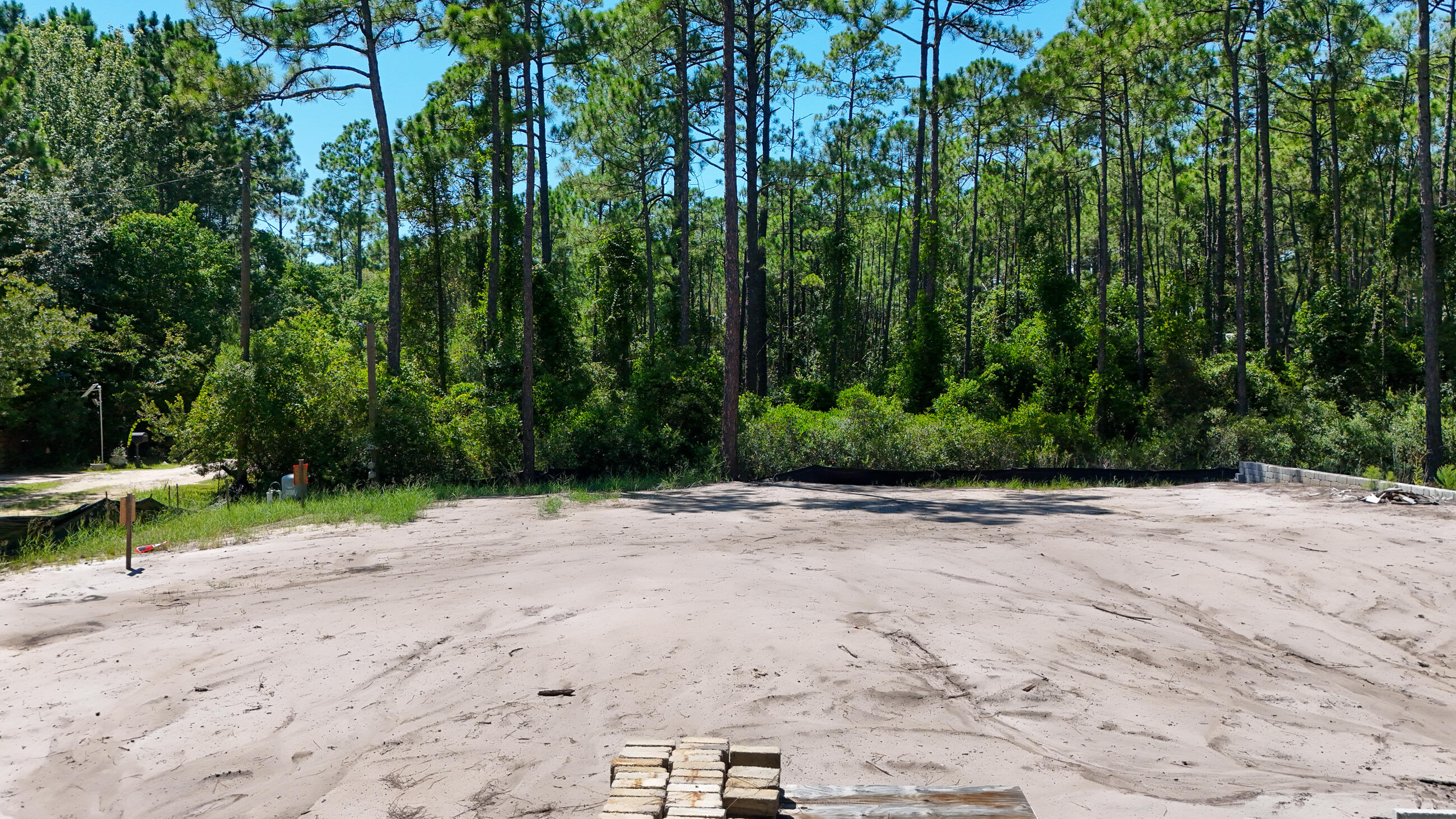 Build your dream coastal retreat less than a mile from the Gulf.  This private homesite is truly turnkey, with building plans already in permitting and everything prepared for your new build.  This lot has been fully backfilled, mitigation completed, septic designed and approved, water well installed and a retaining wall in place.  Temporary electric is connected, survey and plans available, and there's NO HOA and NO FLOOD INSURANCE REQUIRED.  Tucked away on a private road, this rare opportunity offers the convenience of a ready-to- build site with the charm of coastal living.
