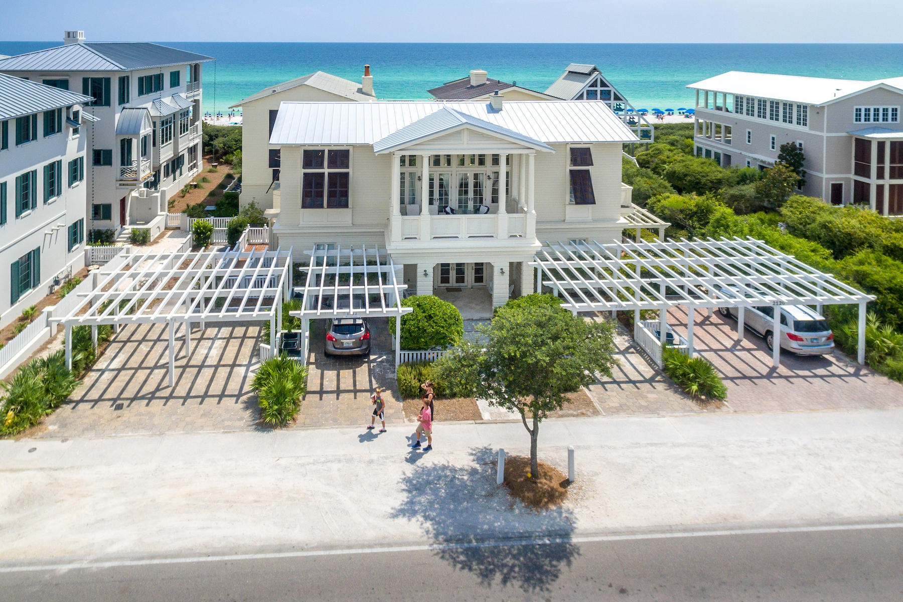 Located in the town of Seaside and within a few feet of the Gulf of Mexico, Stay A Little Longer is a beautiful beachside getaway on County Road 30-A. Featuring an elegant, comfortable and roomy floor plan, Stay A Little Longer has an ideal location with 4 bedrooms and 4-1/2 baths and a roof top deck with gulf views. This home is a perfect Seaside retreat.
Large, open windows lead the way through this two-story home. Coupled with high ceilings, 10 to 14 feet throughout, the home brings the comfort of the Gulf of Mexico indoors with generous views, light, and a sense of freedom. Downstairs, three of the home's four bedrooms include roomy closets and each have private bathrooms. A comfortable media/playroom in the center of the first floor opens to a covered porch. A utility room with washer, dryer and a utility sink provides a convenient place to put towels and swimsuits after a day at the beach. Upstairs, the gourmet kitchen includes sensible storage features including an appliance garage and a roomy pantry. GE Profile appliances, Jenn-Air gas cook top and a stainless farmhouse sink are a few of the gourmet touches. The kitchen opens into a comfortable, spacious dining area. An elegant living room with walls of windows open to the Gulf of Mexico bring the glow of the rising and setting sun and the emerald waters of the sea into the heart of the home. Custom built cabinetry surround a fireplace. A second-floor porch, accesses the home's Gulf side rooftop deck and crowns this beach side getaway. Enjoy afternoon refreshments and an unparalleled sunset, reach up and touch the stars, or start the day with an astounding sunrise from this private spot. Back inside, the home's windows on the north watch over the town from yet another spacious porch. The master bedroom and bath with two vanities, separate shower and whirlpool tub finish the second floor with a sense of privacy. Stay A Little Longer is filled with extra touches; an all-wood interior, separate heating and cooling units on each floor, a 120-gallon water heater, recessed lighting, a security system, and a full-home audio speaker system. The home's elegant interior design laced with contemporary themes complements the panache of Stay A Little Longer. The beautiful furnishings were selected for comfort and to enhance the interior design. Outside, find plenty of storage space for beach gear and an outdoor shower for rinsing off after a visit to the beach. Drive up to Stay A Little Longer and park beneath one of two matching private parking pergolas. Leave the gear in the car and head straight to the beach. The West Ruskin Beach Pavilion walkover is just a few steps west of the home. If Seaside's Town Center is your preference, simply stroll a few steps and catch a movie or concert and a bite to eat. Stay A Little Longer is ideally located very close to Seaside's favorite gathering spots, restaurants and shops.