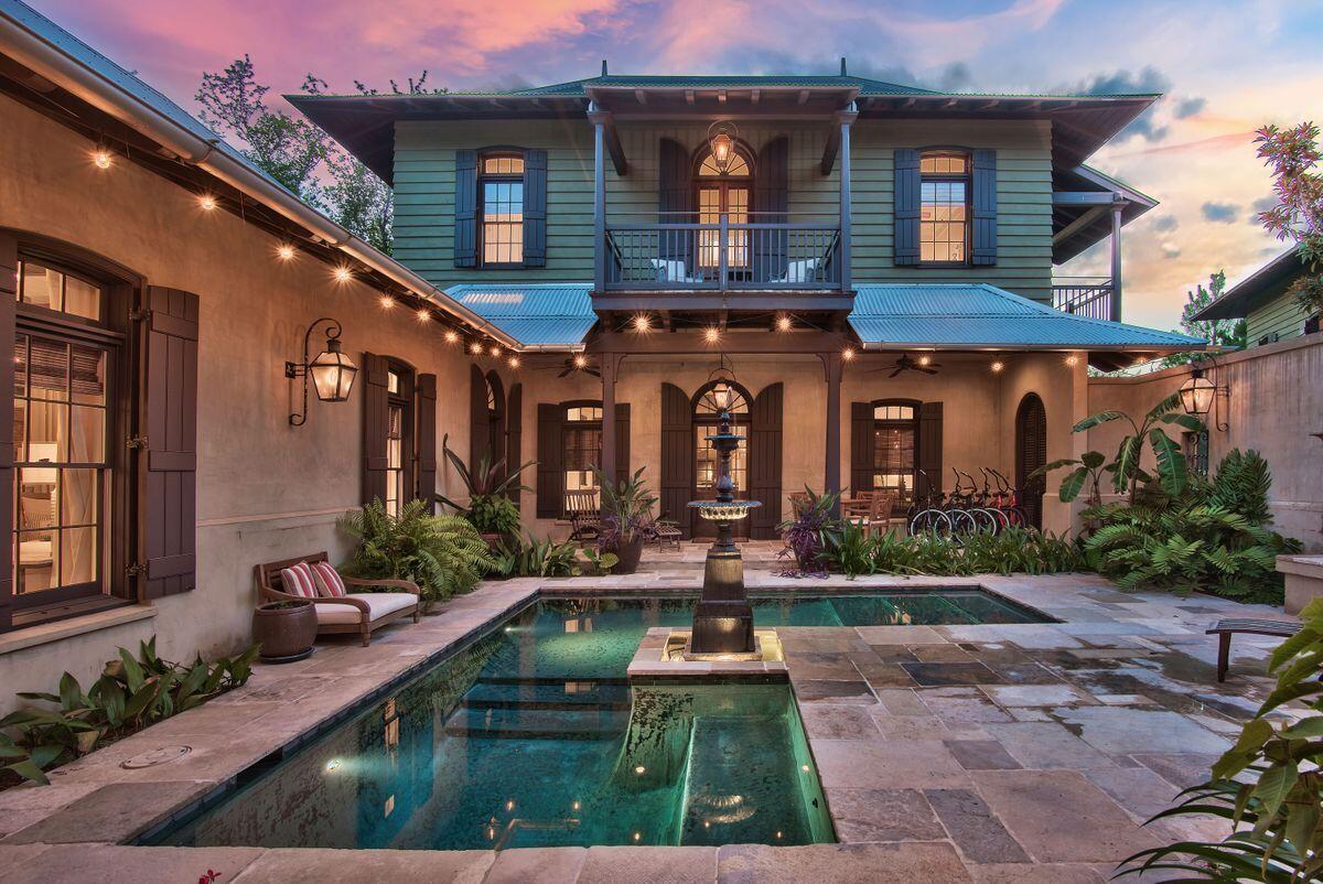 Stunning Colonial home on spacious homesite featured in Veranda Magazine, this extraordinary British Colonial style home was
thoughtfully designed by Charrette Design Group. Situated on one of the largest, most
private homesites in Rosemary Beach this 4,584 sq.ft. complex is brimming with bespoke architectural features. Antique French limestone floors, custom mahogany woodwork and antiqued plaster walls lend the feeling of ''Old World'' charm. Beneath the darkwood beams in the living room, put your feet up in front of the cosy Isokern fireplace with its custom mantel. Natural elements and stylish transoms create an elegant yet casual touch throughout the property. On the main floor, a custom gourmet kitchen boasts Wolf and Subzero appliances, a granite-topped island, breakfast bar and full size wine cooler. It's a well appointed space, whether you're entertaining on a grand scale or just making pancakes for two. Walk out through mahogany French doors onto the shady veranda where lounge chairs invite you to relax and listen to the tinkling fountain. The serene courtyard setting draws the eye to the L-shaped black-bottom pool and outdoor fireplace. Low maintenance flagstones enhance this peaceful area of quiet contemplation, lit by flickering gas lanterns after dark. Sharing this exceptional space with visiting family and friends is a pleasure. This spacious home has a guest wing offering privacy on the main and second levels. A separate sitting area with two of the three guest bedrooms have balconies creating a pleasant environment to sit and read while overlooking the lush courtyard and pool. The master suite has its own wing with a private balcony and bright sitting area. In addition, there's a guest cottage separated from the main house by the walled courtyard which creates a private sanctuary. Spaciously designed over three floors, the cottage easily sleeps 9 with two guest suites and two bunk beds. Guests can enjoy their own independence with a gourmet kitchen, dining area and laundry. This prime accommodation could also be used for an independent family member, house manager or to generate income as a vacation home or long-term rental. Behind solid wooden gates there's ample parking for both the main house and the cottage. The unspoiled sandy beach, upscale dining and entertainment at Rosemary Beach are just a short stroll from the door, making this unique residence an absolute 'must see'.