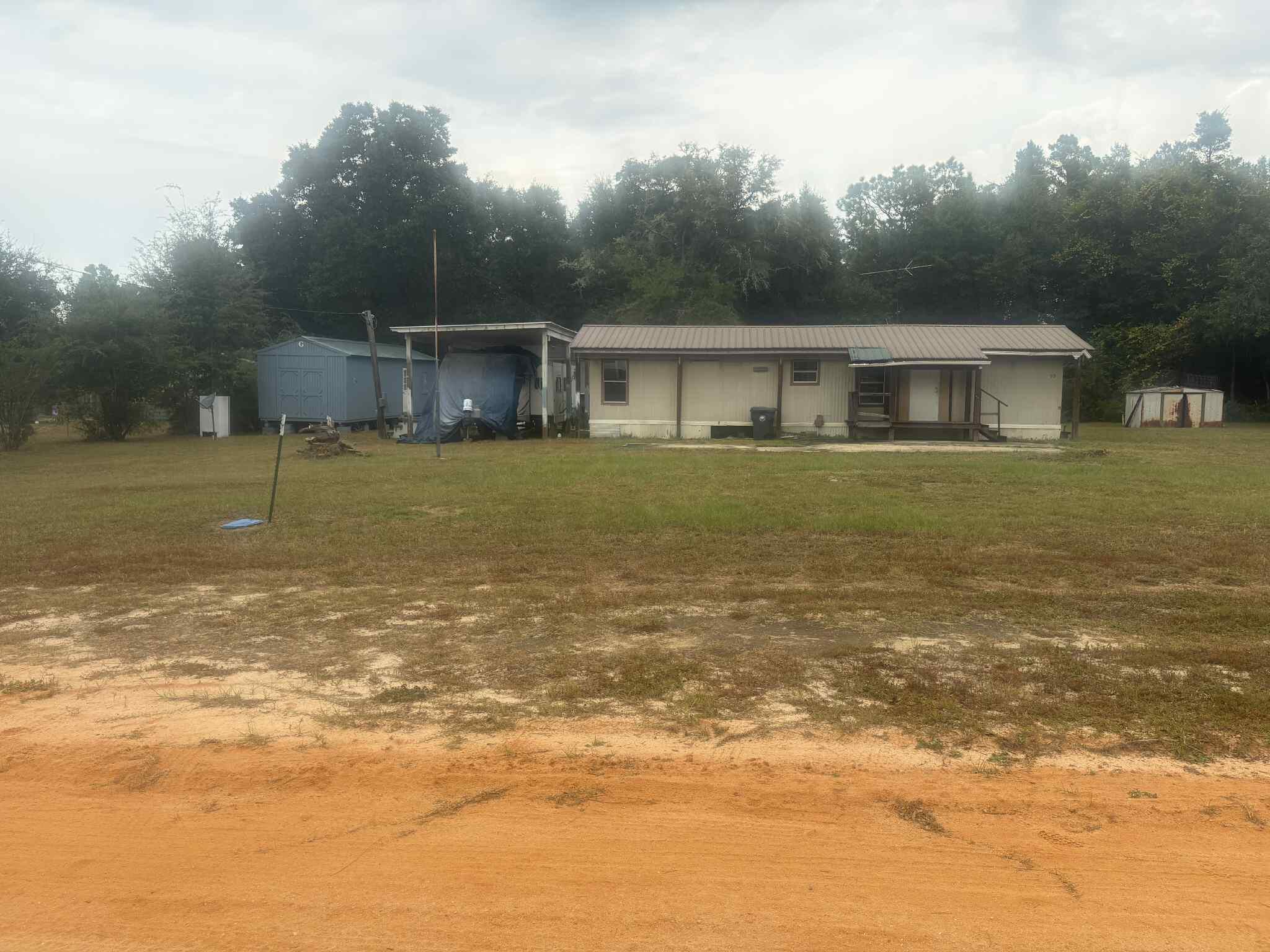 This property boasts a great deal, consisting of 2 lots and 3 storage units, with a well, city water, and septic tank. An RV hook up is provided. Moreover, one of the storage units has been framed up but not completed to use as a tiny home. Offering a potential source of extra income.