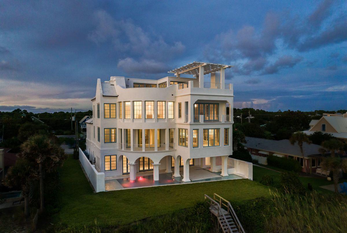 Newly constructed ''Mont Blanc'' exemplifies a well-traveled coastal retreat featuring iconic architectural styling prominently positioned to offer an unparalleled Gulf Front lifestyle along the pristine white sand beaches of Seagrove, Florida. Pushing the boundaries of both architectural design and fortified construction, this idyllic legacy home pairs utmost quality and artistic inspiration into a refined finished that is unrivaled in Northwest Florida. The progressive nature of this renowned beach retreat was highly curated by a team of top talent including construction by Scott Barnes Development, design and finish selections by Erika Powell of Urban Grace Interiors and architectural rendering by Archiscapes & TS Adams Studio. Ideally located in the heart of Seagrove Beach, this legacy home was designed as a safe haven situated on one of the most picturesque beaches in the United States featuring unimpeded views over the emerald green waters and crystal white shoreline of the Gulf of Mexico. Hand-crafted design elements ignite to create a refined coastal experience through bespoke aesthetic finishes inspired by the white-washed cycladic architecture of the Greek Islands. The front elevation is anchored by a beautiful courtyard entryway featuring sculptural architectural details as well as a tranquil water feature and lush mediteranean foliage. The private courtyard entry is flanked by three oversized garage stalls which offer premium parking as well as ample space for additional storage. Upon entry, the resplendent natural lighting is immediately realized as it cascades off tumbled lime washed stone walls that took over 18 months of construction to reach fruition. The impressive four-story vertical footprint is highlighted by a sprawling grand foyer staircase which is cast in white venetian plaster and beautifully anchors this majestic home. The colorful emerald green and crystal blue hues of the Gulf of Mexico parlay into a vibrant juxtaposition from the white-washed interior & exterior architectural facade that can be enjoyed from each level of this magnificent property. Mont Blanc presides over 30' above sea level and offers immediate panoramic views from the first floor living area highlighted by an expansive eurowall  that offers an exceptional indoor-outdoor living concept pairing the first floor living space with the resort style private pool deck. The rear pool deck is perfectly poised to take full advantage of gulf front living with a beautiful resort style pool and expansive covered patio overlooking the white sand beach complete with in-pool dining as well as space for a full outdoor kitchen. The first level also offers a full king suite complete with ensuite bathroom and walk-in shower as well as a separate laundry area, pool bathroom, commercial ice maker and additional storage. The second floor is prime for entertaining offering a spacious living area and 180 degree views over the Gulf of Mexico with a cozy gas fireplace as well as an adjacent chef's kitchen & adjoining scullery complete with finely appointed Wolf & Subzero appliances. The second level also offers a half bathroom for guests as well as two large king suites, each yielding an ensuite bathroom as well as a pinterest-style bunk room with private ensuite. The master level occupies the southeastern portion of the third floor and is a true sanctuary characterized by a distinct spa-like master bathroom complete with heated seating in the steam shower, a private massage & body scrub table and a rotund wall of windows perfectly capturing panoramic gulf views with a western sunset orientation. The master closet is oversized and offers custom cabinetry & storage as well as its own laundry station, wet bar, sauna and fitness room. The third level also offers an additional bedroom suite as well as a third laundry station for guests to utilize. The fourth story transports guests to an ethereal space designed with an unobstructed line of sight soaking in endless water views and offering a custom built bar area and wine cave with direct access to the top floor veranda. The crowning achievement of Mont Blanc is not just it's stark architectural appeal but also the exceptional engineering that allows this home to be one of the most heavily amenitized properties on 30A. The top floor deck is finished with mature ipe decking which surrounds the lavish sun shelf and rooftop plunge pool thoughtfully positioned to enjoy year round sunsets from the masterful western orientation. Other notable features include a private beach walkover, custom marble and hardwood flooring throughout the home, hand hewn oak beams and eucalyptus wood accents as well as fortified concrete construction. Mont Blanc epitomizes 30A luxury living and offers a truly unprecedented lifestyle with close proximity to surrounding new urbanism communities including Seaside & Watercolor as well as all of the world class shopping, dining and entertainment that South Walton county has to offer.