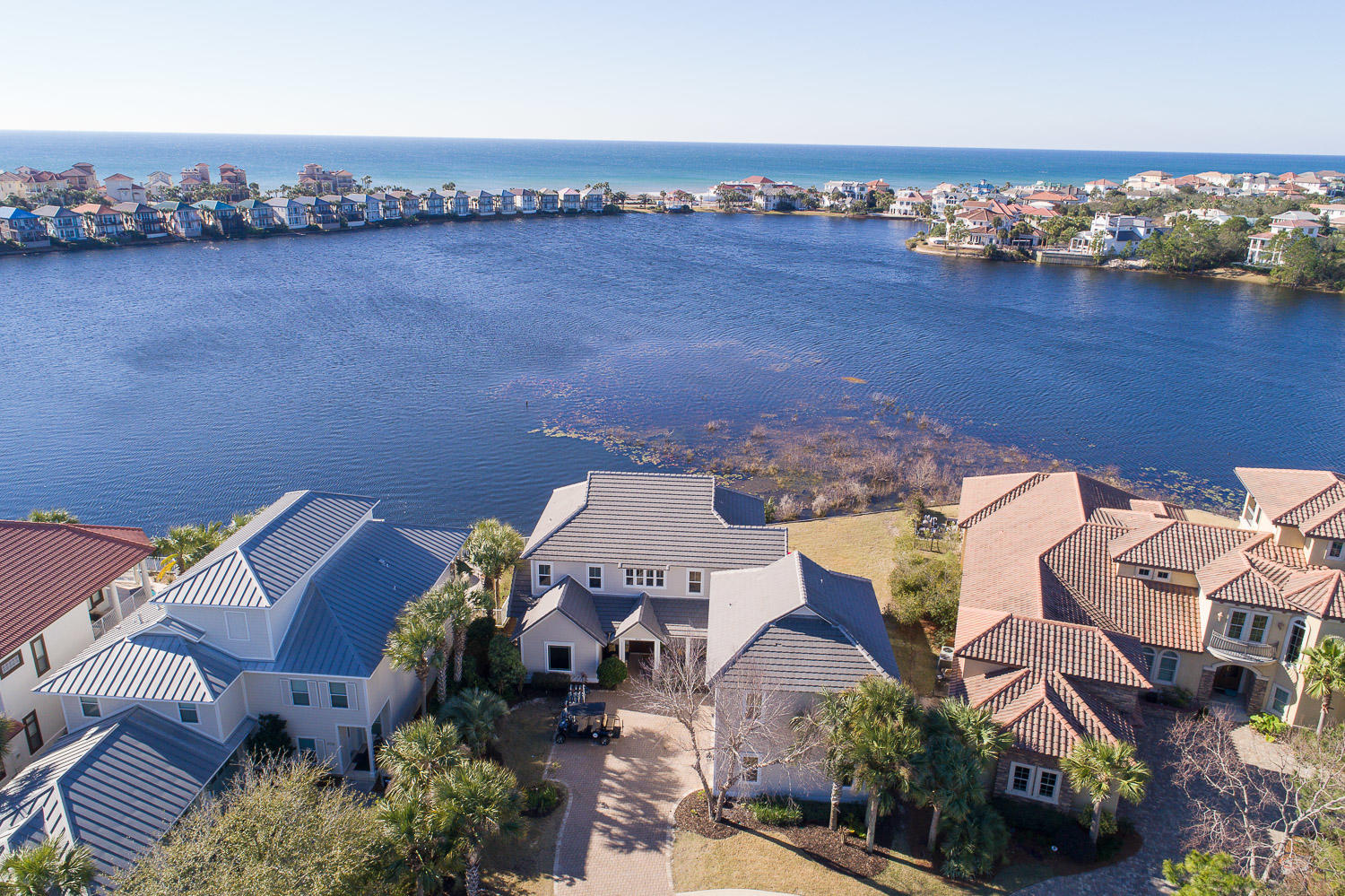 This completely renovated custom built lakefront home with Guest house and gulf views has 7 bedrooms, 5.5 baths, two full kitchens, three laundry areas, and is located on a quiet cul-de-sac in the exclusive gated community of Destiny East. Double sized lot with 110' of lake frontage provides privacy. The main house consists of 5 bedrooms & 3.5 baths with a separate 1000 square foot Carriage House with 2 bedrooms & 2 baths and  private entrance. The house was designed to capture lake views from almost every room with expansive outdoor living space and room for a large pool. Recent upgrades include; new kitchen, new appliances, new flooring, new bunk room, two new 3 ton a/c, exterior and interior painted, brand new porch/decking with outdoor kitchen, new Renai hot water heater, new lighting, and more. Gross rental projections exceed 160k! In addition, commercial grade appliances, Pella high impact windows with hurricane film for added protection and efficiency, custom cabinetry, surround sound, outdoor shower, over-sized three car garage (one which has been converted to a rec room), mahogany doors, gas lanterns, and more. Rental projections in the $165k to $180k range when the installation of a pool is complete. This will make a great family retreat, or rental property as there are very few homes like this in the area.