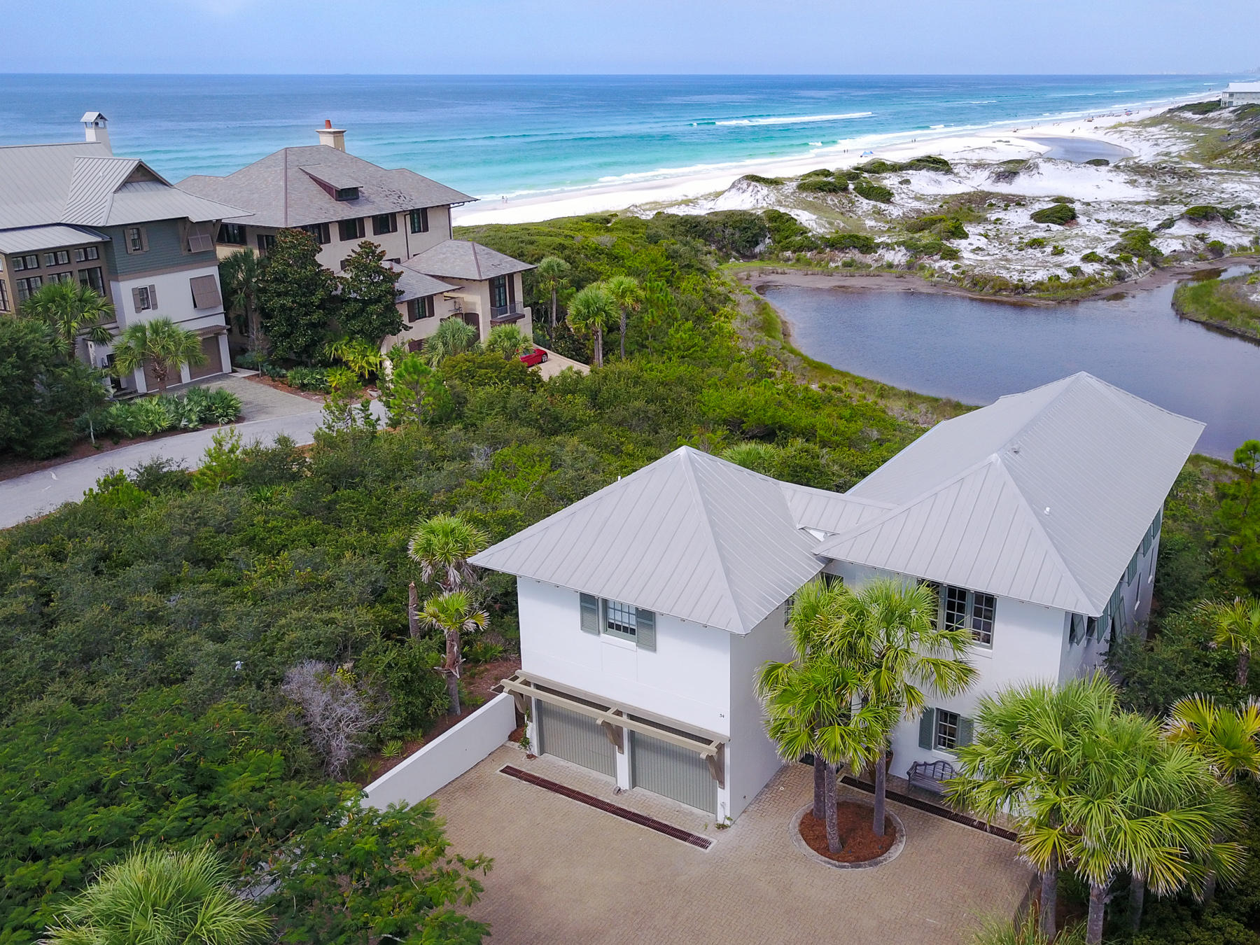 Step into the entryway of this tranquil, private courtyard overlooking the white sand of a rare coastal dune lake and spectacular views of the Gulf of Mexico. Nearly every room of this 2,314 Sq. Ft. home offers incredible vistas that you can only get from the Emerald Coast. This seaside home has 3 bedrooms, 3.5 bathrooms and a bunk room for visitors and guests. A spacious 2-car garage and a large private driveway provide plenty of room for hosting guests and entertaining. Lavish finishes and amenities like wide plank hard wood flooring, granite counter tops, steam tile showers, GE stainless steel appliances and high, wood beamed ceilings are found throughout this home. The main level features an open living and dinning space with tall doors and windows that fill the room with natural light and stunning views. An expansive master suite offers his and hers walk-in closets, double vanity, a walk-out balcony, and jet tub.
 
Nestled in the private community of The Retreat, 54 Tortolla is just a short distance to the community beach access and gulf front pool. Located on Scenic Highway 30A, this community is near all of the shopping and dinning that 30A has to offer.