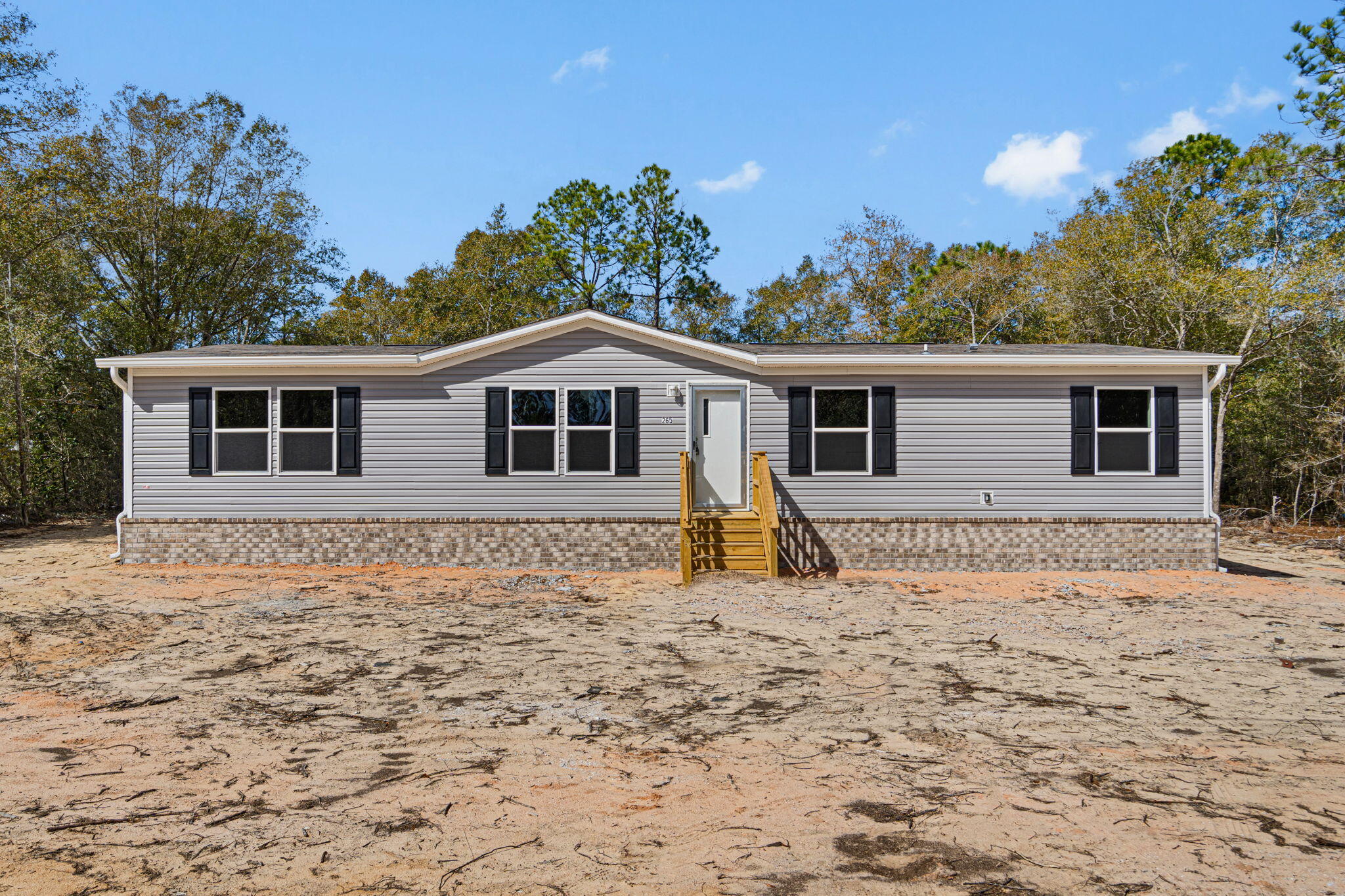 Discover this stunning brand-new manufactured home and enjoy being its first owner! Exterior highlights include upgraded brick skirting for added durability and curb appeal, plus a spacious back deck ideal for outdoor entertaining. Located on approximately 0.38, this home offers a spacious open-concept layout with split bedrooms for comfort and privacy.
The kitchen features a deep stainless-steel sink, smooth-top stove, dishwasher, and a full wall of cabinetry surrounding the refrigerator for excellent storage. A large center island provides extra prep space and seating. This home offers 3 bedrooms, 2 bathrooms, and dining space to suit your needs. The primary suite includes a walk-in closet and double vanity. 
Conveniently located just minutes from historic downtown DeFuniak Springs.