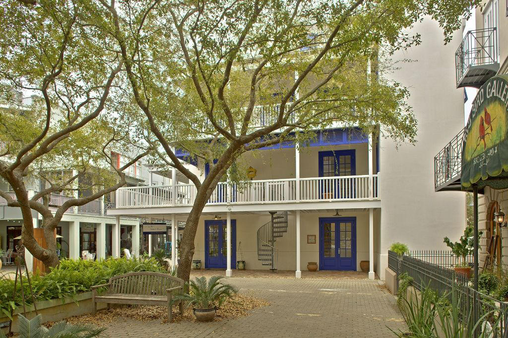 Nestled between Seaside's Central Square and Ruskin Park sits Early Morning Hours. This unique home in a unique neighborhood overlooks the Park and the magnificent Seaside Chapel and has been featured in the book 30A Style. Built for a family, this is a true home. The home shares its' first floor with one of Seaside's finest boutiques. This retail space provides year round income. Starting from the top of its' 4 stories is a comfortable tower room accessed by both sculptural stairs and an elevatorwith plenty of room to house your reading collection (or kids' bunk beds). It opens onto a roof deck with views of the Gulf, Seaside's glorious Chapel, Ruskin Park and all of Seaside's rooftops. It offers a perfect place to relax in the sun, watch the early morning sunrise o exquisite Gulf sunsets. The main living level is located on the 3rd floor.  A large 40' x 22' space opens onto a 12' x 20' deck overlooking the Ruskin Place Artist Colony and Park.  The kitchen with beautiful maple cabinets and large granite island shares one side of this level with a TV area and dining alcove.  The rest of the floor, with a custom fireplace equipped for gas, offers a luxurious living area.  A convenient powder room completes this floor.  Four sets of French doors open onto the deck and the east and west sides of the house feature rows of windows making this a light filled airy space of style and comfort. The 2nd floor of the home comprises 2 master suites connected by a long hall which currently offers a perfect space for a family photo gallery and also houses a hidden laundry area.  Both suites are large, with ample closet space and baths, and give their occupants privacy and comfort.  The entire second floor opens onto a spacious wraparound porch that offers leafy views of the park.  A custom circular stairwell allows easy access to the park level and adds a distinct charm. On the 1st floor level you enter the gracious home by a set of French doors.  They open into a hall and entryway where a formal stairwell with custom polished aluminum rails invites you to advance up the stairs.  Adjacent to the stairs is an elevator that takes you to all other levels of the home.  The first floor of the home also provides another full bath and an ample storage room.  A back door takes you to a driveway and your parking area.  The first floor of the home is shared with a 750 sq. ft. commercial space than has been leased continuously since the home has been built. This home, carefully thought through by its' owners and their architect is an architectural gem.  This is a must see if you are looking for a meticulously cared for Seaside home that is both urbane and beachy.