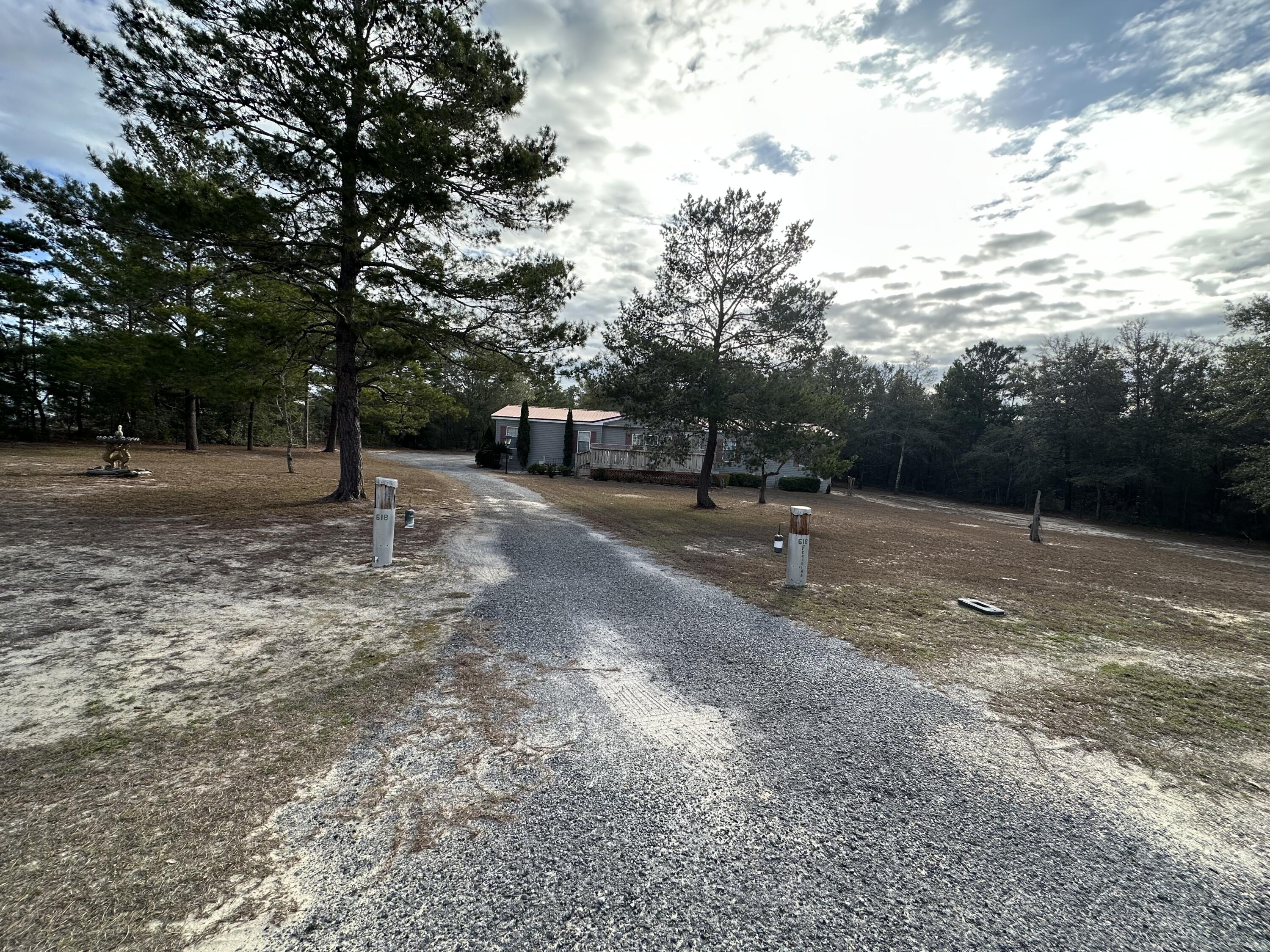 This beautiful property is located just north of the City of DeFuniak springs. This property blends the convince of the city, with the freedoms afforded with county living. This 3-bedroom, 2-bath home sits on nearly a full acre of land that has been well maintained. Spacious rooms and well laid out floor plan provides plenty of comfortable living space. The property features a detached carport and large shop that totals nearly 1,200 sq feet! Inside the shop you will find water hooked up, electricity, and a working bathroom. The carport area also allows for enough room to park two vehicles, with an additional area, big enough to fit a lawnmower/4wheeler/ or small boat. The backside of the property is fenced off, so your fur babies would have a place to run around.