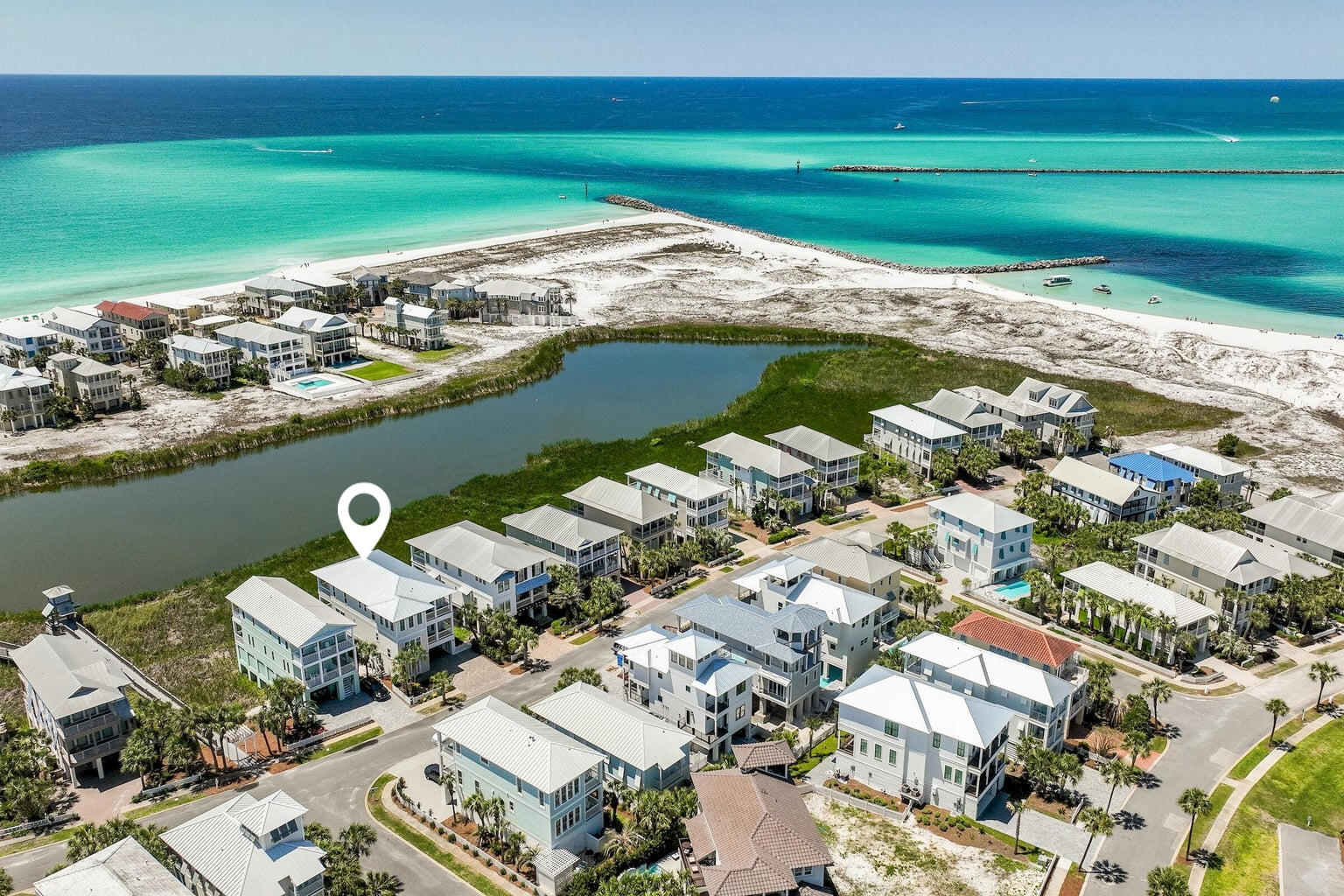 Exceptional views and attention to detail define this coastal modern retreat. Overlooking coastal the coastal dune lake, Lake Christina, this home affords extraordinary views of the lake, Destin's East Pass and the Gulf of Mexico. It's well appointed and has been meticulously thought out from design to conception with its two gulf side master suites, two guest suites and additional bunkrooom with four berths which make this home an ideal retreat for large families. In total there are five and a half baths; giving each bedroom including the bunks, their own bath. Interior finishes are impressive with notable features such as tongue & groove ship lap siding, vaulted beamed ceilings, private elevator; along with wood and tile floors throughout. The first floor..... The first floor features an open living concept with kitchen, dining and living all open to one another and each enjoying the lake, pass, and gulf views. The kitchen offers custom cabinetry, quartz  countertops, stainless steel appliances including a double oven as well as an oversized pantry with ample storage. Adjoining the kitchen is the generously-scaled dining and living areas which flow out onto the expansive rear deck that spans the entire width of the home allowing for easy indoor/outdoor living. Also on the first floor is a private guest suite with its own bath and private balcony. Journey upstairs and you will discover two finely appointed gulf side master suites; each with vaulted ceilings, private baths and tremendous water views. Both suites afford their inhabitants relaxation, seclusion and covered balcony perfectly framed by gulf & lake views. The east master features a spa-like ensuite bathroom complete with a large soaking tub, dual vanities and a walk-in shower, while the west master features an ensuite bathroom with oversized walk-in shower and dual vanities. The second floor also includes an additional bedroom suite with private bath, plus a custom-built bunk room with its own private bath. Destin Pointe is a private, gated island community located in the heart of Destin's harbor district. It features 24 hour security, 3,000' of deeded beach access, two lakes, shuttle service to and from the beach, two pools, two tennis courts, access to the East Pass with snorkeling and fishing as well as close proximity to the world class restaurants, boating, shopping and entertainment Destin has to offer!