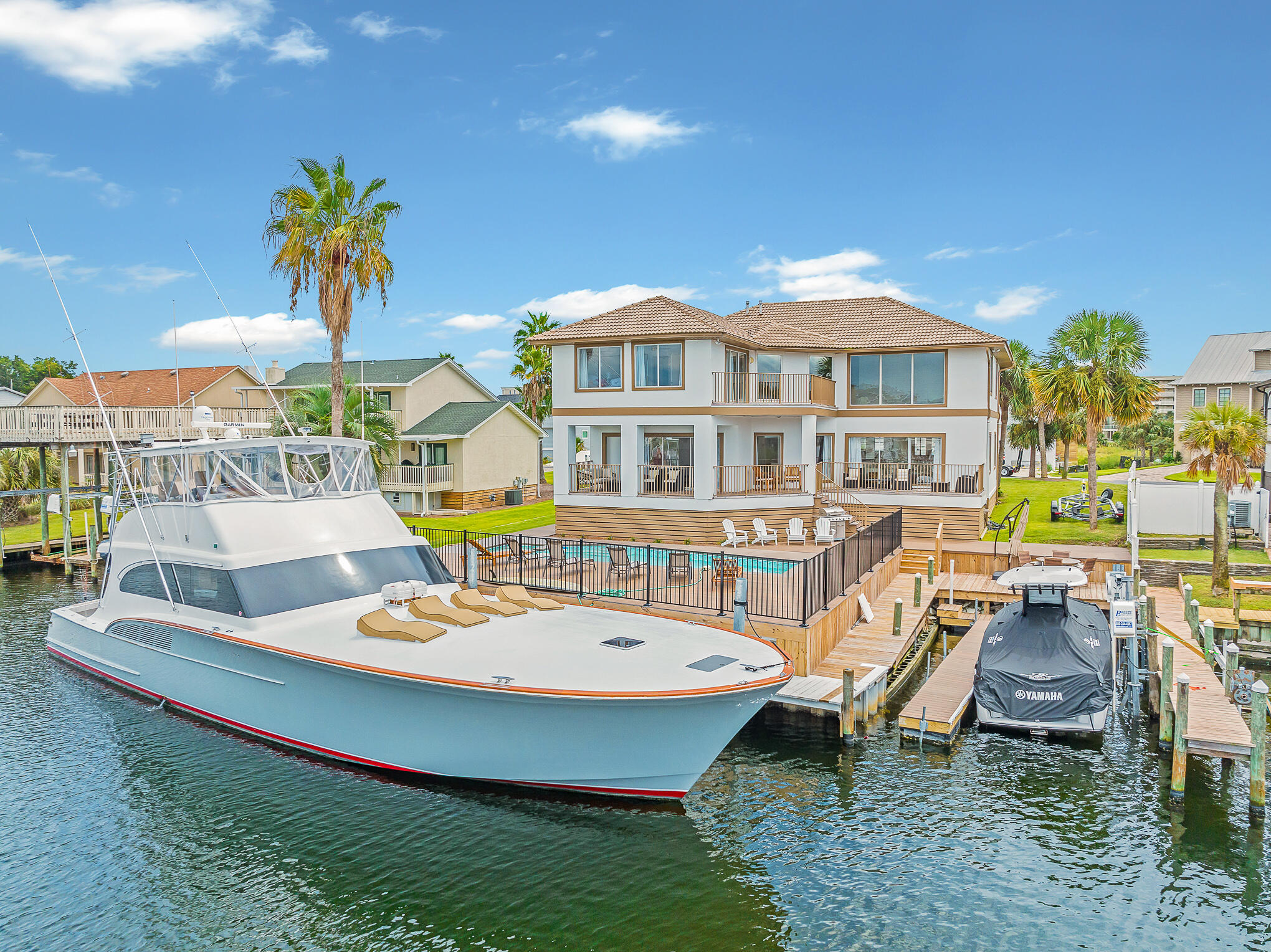 A true boater's paradise, 505 Vera Cruz welcomes both the avid angler as well as the weekend cruiser. Currently accommodating a 67' sport fisher on the outside slip plus an additional center console in the interior slip, this property has ample room for everything. The home has recently underwent an extensive renovation throughout including the addition of 2 extra bedrooms. The interior space invites you in with it's soaring ceiling height and vast windows, perfect for absorbing the water views. Reclaimed heart of pine flooring blends with coastal white walls and a well appointed furnishings package to round off the shabby chic concept. Enjoy outdoor living with the plethora of decking and heated pool with built in hot tub. The canal at Vera Cruz is one of the largest in the harbor, making it easier when it comes to navigating and mooring a vessel. This canal offers premium access into the Destin Harbor and out the East Pass into the Gulf of Mexico, while offering shelter from direct winds and boat wake. Some other notable features include but are not limited to: cul-de-sac location, 2 car garage with additional tackle room, additional pavered parking pad, spacious mudroom/laundry adjacent to garage with extra refrigerators, wet bar, main level bedroom, and Ipe decking. Holiday Isle is renowned as one of the most ideal locations in Destin and along the Emerald Coast providing beautiful beach access and all that the Destin Harbor has to offer.