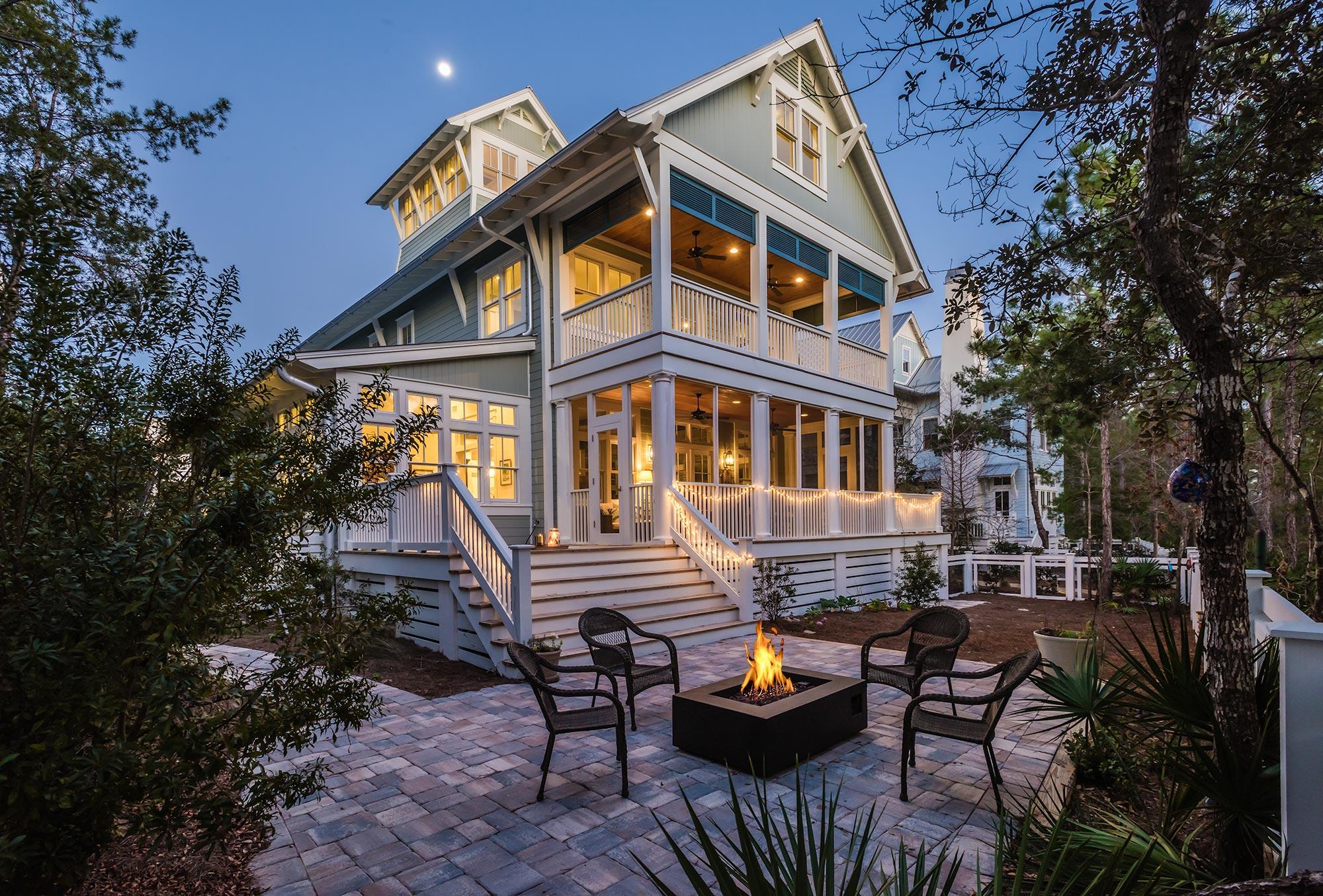 This four-story lakefront home greets you with the glow of gas lanterns, a spacious covered front porch with stately blue board and batten shutters and an accentuated shiplap ceiling that adds warmth to the space. This WaterColor home offers a coveted main floor master suite and a bonus bunk room with fun and functional living space on each level. A cozy seating area arranged for conversations and a front porch swing create the perfect place to unwind after a day at the beach. Large windows with transoms flood the welcoming foyer wrapped in shiplap with natural light. The soaring ceilings pull the eye upwards and an exposed brick accent wall draws you into the space. The warm walnut floors lead you to the heart of this 4,433 square foot home, where you will find an expansive coastal kitchen with a large center island, elegant designer cabinetry, an expedient pantry and breakfast bar seating for four. The Thermador fridge blends effortlessly into the space, and the double ovens and six burner gas range make entertaining in this light and bright beach house a breeze. The open concept great room flows into the dining, which features a cypress wrapped beamed ceiling with an over-sized dining table that offers seating for eight. The open and airy living room is an entertainer's dream boasting large windows with transoms, a gas fireplace and two doors leading out on to an open back deck and pergola. The well-lit sun porch, located off of the dining, features a sitting room and office with a soaring vaulted ceiling. Double doors open to an expansive screened-in back porch that offers a beautifully appointed outdoor living area and a large dining table where guests can enjoy alfresco dining year-round with stunning views of each and every sunset and Western Lake. The private, heated splash pool and back deck overlook a large backyard, which features a paver patio with a gas fire pit that backs up to preservation land and Western Lake. The main floor master suite, provides spacious accommodations that offer a luxurious master bath featuring dual vanities, a shower with bench seating and a separate soaking tub. The master suite is also equipped with a roomy walk-in closet and direct access to the back deck and pergola. On the second level, a secondary master suite can be found with a dedicated bath and a large walk-in closet. A guest suite with a private bath can be found adjacent and down the hall is an additional expansive living room. A spacious covered porch with an outdoor living area and a swing bed offers spectacular marsh views of Western Lake. A bonus bunk room with two sets of bunks and a fourth guest bedroom share a separate bath with a shower/tub combo and a pocket door. The third floor of the home features a roomy shiplap loft with vaulted ceilings and a large game room for the kids and kids at heart. Also offering an expedient half bath, this level carries you up to the fourth-story tower boasting lots of windows and stunning 360 degree views of WaterColor's Camp District and picturesque sunsets. An expedient half bath and a conveniently situated laundry and mud room can be found on the main level. The home's carport also features a spacious workshop with a workbench and tons of added storage space. This WaterColor lakehouse is a must-see home located in the heart of phase II!