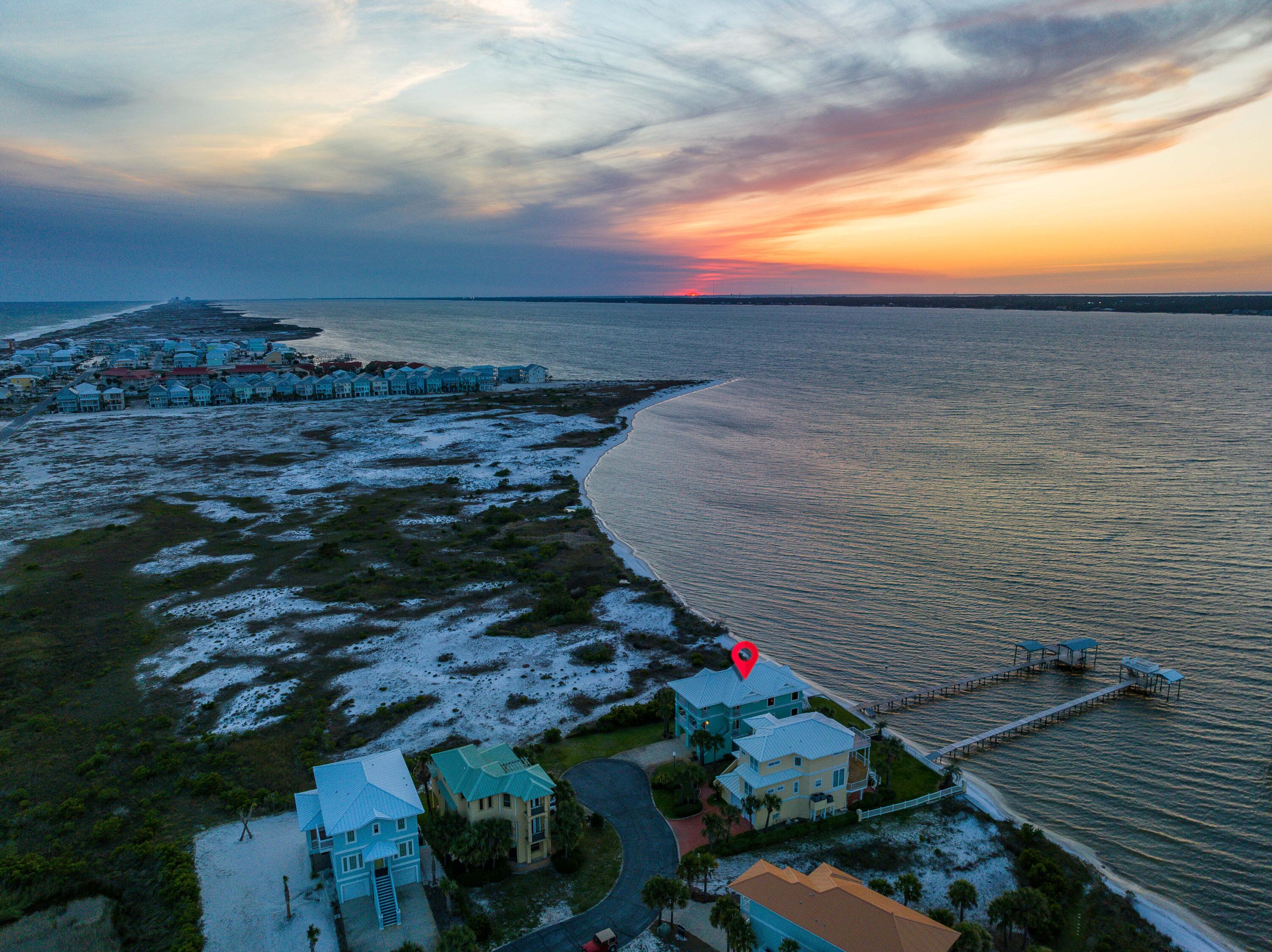 One-of-a-kind Soundfront Eden embodies the Quintessential Florida Lifestyle on Navarre Beach. Florida's Most Relaxing Place. Premiering unparalleled views, this 4 bed 3 bath home borders County Conservation land to the West ensuring Undisturbed Water Views and Pristine Sunsets.You and guests can enjoy every day on the water in your own backyard with a private beach, private dock, boat lift, boathouse, & mooring ball.Heated outdoor shower is perfect for rinsing off after water-filled day.Open-concept kitchen, living, and dining areas are thoughtfully designed to take advantage of the Sound views and incredible sunsets.Soft close cabinets and drawers are added bonus, making entertaining a breeze. Multiple balconies offer outdoor spaces to entertain, relax & absorb the tranquil atmosphere. The impressive Soundfront master suite offers panoramic views of the water, a private balcony, and a Spa-like en-suite bathroom complete with a walk-in closet. New hardwood floors have been installed on the stairway and the entire 3rd Floor where you'll find 3 bedrooms. 

Meticulously maintained, this home features Impact Window and Doors, standing seam Metal Roof, 2 new AC units installed just 6 months ago and freshly painted exterior just 2 years ago.

The oversized garage provides ample space for your cars, jetskis, and golf cart. Plus plenty of extra storage space for all your toys and tools.
Security is a top priority, and this home comes equipped with a home security system for added peace of mind.

The highly coveted gated community of Caribbean Isle offers a community swimming pool and tennis courts. Experience the best of the Navarre Beach lifestyle with access to the Navarre Beach Fishing Pier, miles of bike/walking trails, and the Gulf Islands National Seashore's natural beauty.
(7612 Key W Drive is a rare oasis that provides the perfect blend of luxurious waterfront living and convenience. A perfect place for your permanent residence, second home, or investment property. Don't let your chance to own this modern Eden slip past!
