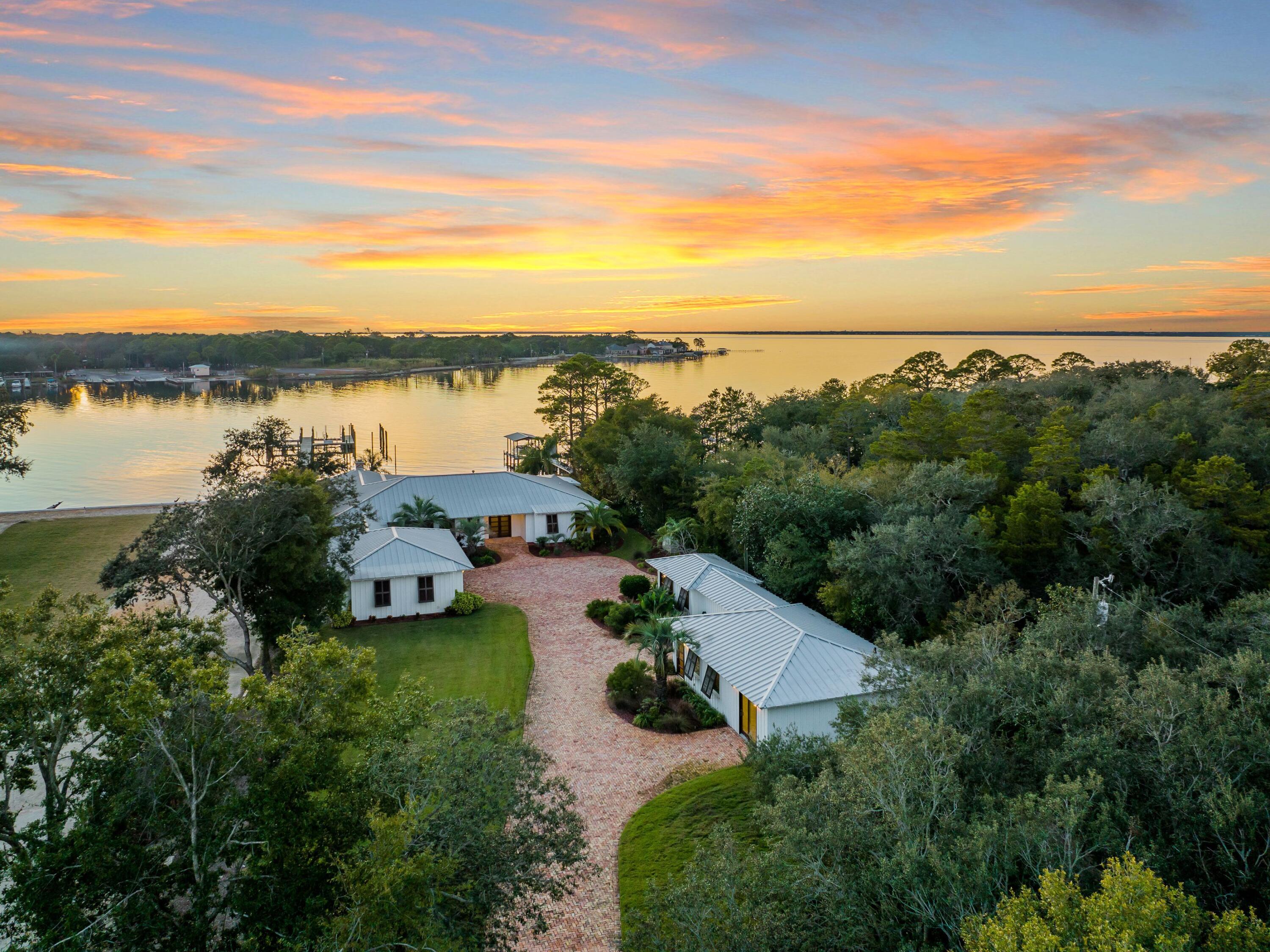 Experience unparalleled waterfront living in this stately home that boasts its own private beach, deepwater dock and guest house with two bedrooms and bathrooms. A perfect marriage of indoor and outdoor living that's both private and conveniently located near the best of everything in Destin, this retreat capitalizes on remarkable views across Joe's Bayou to the Choctawhatchee Bay. An impressive brick driveway leads to an oversized garage and the home, situated amid lush landscaping, which has been thoughtfully remodeled. No expense was spared in this five-bedroom, six-and-a-half bath retreat, including pecky cypress ceilings, stunning wood flooring and open living spaces for the best of Florida coastal living. The heart of the home boasts custom cabinetry and Wolf and Viking appliances that take the cooking experience to the next level. A breakfast bar features seating for 12. Wine lovers will appreciate the generously-sized climate-controlled wine cellar. The living room boasts a fireplace and views of the summer kitchen and water beyond. Take a stroll down to the deepwater boat slip, where you'll enjoy a convenient boathouse, perfect for storing toys and gear for water sports, and private beach. This home's outdoor amenities are the true pièce de résistance of this property, including a saltwater pool and spa with water views; a well-appointed outdoor kitchen with sink, grill, refrigerator, double Big Green Egg grills and both boiling and frying stations. When it's time to wind down for the night, relax in the Bluetooth-equipped owner's suite, which features a ThermaSol steam shower. Low-maintenance Trex decking, outdoor lighting and a whole-home generator offer additional conveniences.  Bayou Drive is located in an area of Destin known for its tranquility away from the beach crowds, but with quick access to the best dining, shopping and entertainment on the Emerald Coast.