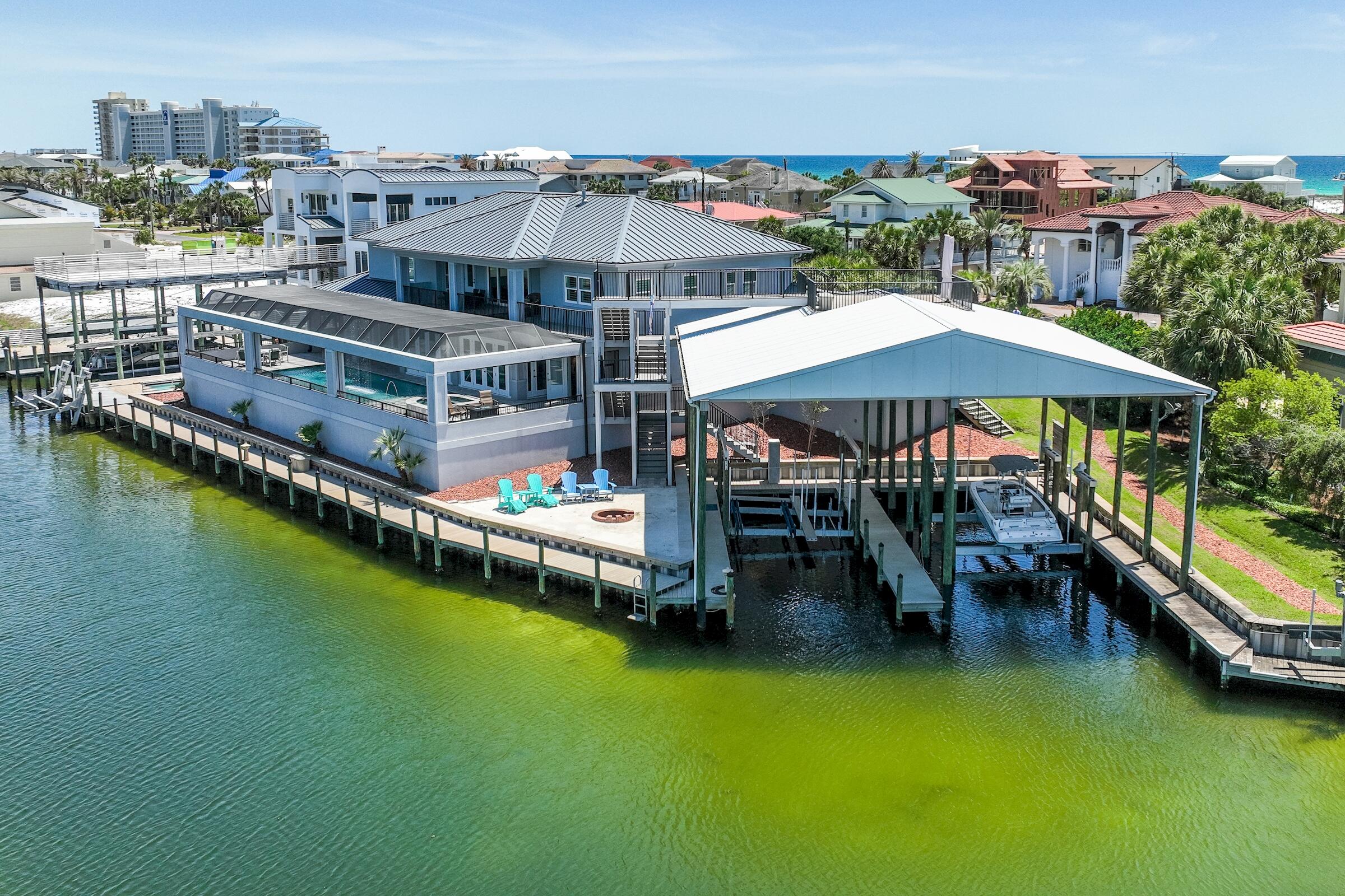 Premier Waterfront gem on Holiday Isle! This harbor canal front home truly is a boater'
s delight. It boasts over 217 ft on the water, with 3 different deep water slips and dockage. It will accommodate very large boats and even jet skis. This newer custom home estate was meticulously built and designed with all the best upgrades and attention to detail. The estate is located on a quiet cul-de-sac, perfect for a person who wants privacy, peace and quiet. With gorgeous exterior and interior detail, finishes compliment the richness of the residence that offers amazing amenities, magnificent waterfront views and breath taking sunsets. Luxury appointments one would expect to come with this private enclave include: 3 large boat deepwater slips,  Jetski lifts, elevator, Generac generator, play room, tv media room, 3 car garage, golf cart garage, large sundeck, second floor kitchen area, 2000 sq ft of covered porches, every bedroom is a master bedroom, rollup pool screens for open views and air flow, Amazing pool with fountains, rain curtain and lighting that changes color. Private beach area with fire pit. Security system with cameras and so much more. come see it, you will be blown away!