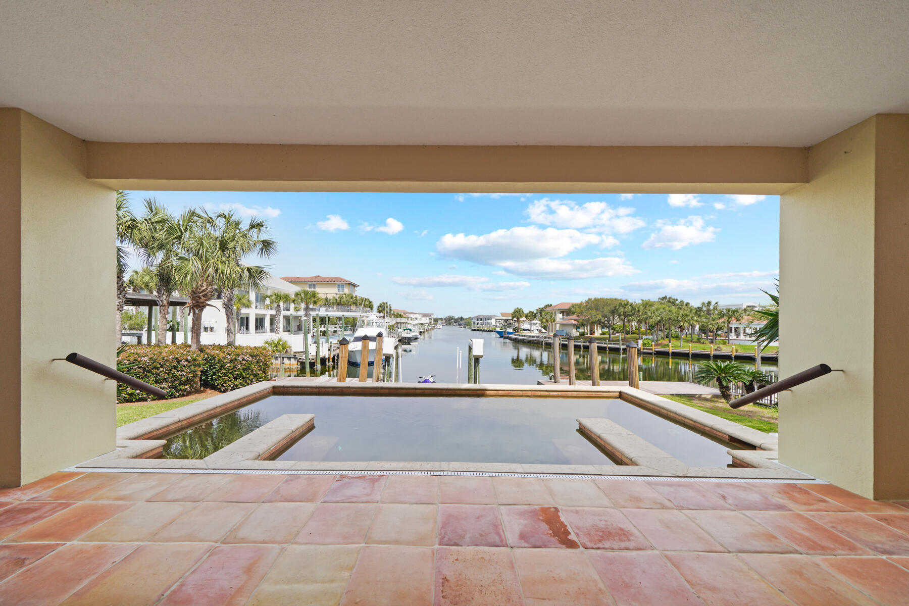 Prime waterfront with convenient access to the beach literally across the street..This location has amazing gulf & harbor views unlike any on Holiday Isle.  Inspired by the architecture in Costa Rica, this very custom home show cases authentic Spanish tiles adorning the main living spaces, each tile a unique piece of art. The concrete construction adds to peace of mind against the elements. The open-air floor plan effortlessly transitions between indoor and outdoor living space. Perfect for entertaining with ample parking and bedrooms are all ensuite.The upstairs living area can be accessed by stairs or an elevator.  The Primary bedroom on the top floor has a large private balcony as well as a large walk in closet and a separate office space. This is the spot!