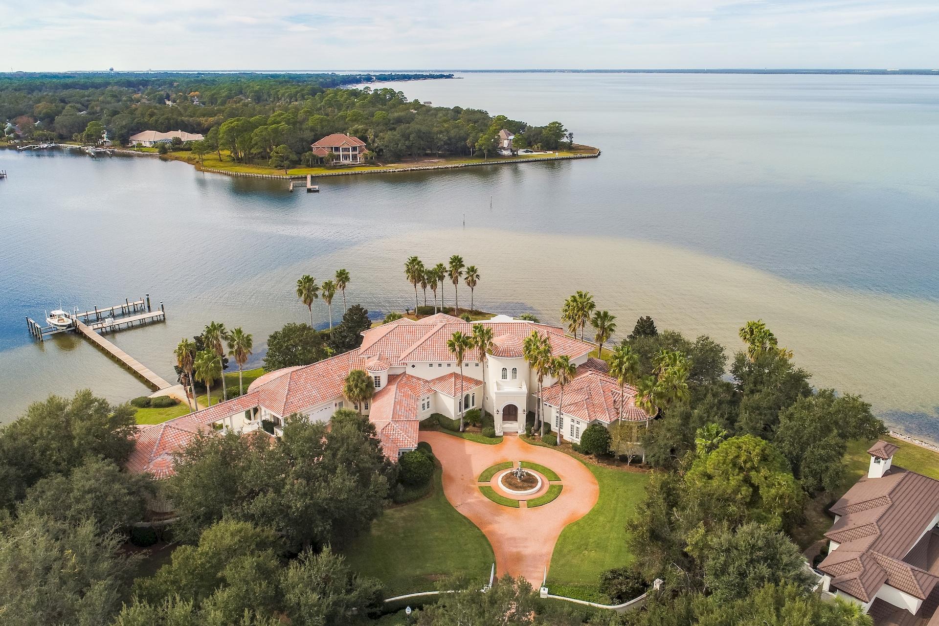 Spectacular gated estate situated on the finest lot in all of Destin and the entire Emerald Coast offering 526 feet of water frontage including the rare combination of panoramic open bay frontage and deep water at the end of your private boat dock on the bayou. Reminiscent of the grand estates of Palm Beach, designed with classic features for comfortable coastal living and gracious entertaining in mind. Impressive gated entrance, graced with mature palm trees and beautifully landscaped, with a circular drive and center water feature fountain, motor court with plenty of parking space. Beautiful double hand forged wrought iron doors open into the foyer and two story rotunda offering the first of many water views. In fact, nearly every room has a view of the water! From the rotunda step down into the great room, with a cozy fireplace and three sets of French doors leading to the lanai.  To the left of the rotunda is the formal dining room, an adjoining butler's pantry, a gallery with a large wet bar area, a sunny breakfast area, large kitchen with a huge breakfast bar, granite counters, center island, abundant counter space and custom cabinetry, upgraded appliances, walk-in pantry, the gathering room with a fireplace and build-in bookcases, billiard's area and den, rear foyer and stairwell.  To the right of the rotunda is the master wing, with a handsome library with floor to ceiling custom bookcases, a spacious master bedroom with a sitting area, and the master bath you've dreamed of...with an exercise room, dual vanities, two large custom walk-in closets, a laundry center, large jetted tub, large circular walk-through shower, dual private water closets.  On the second level is the Captains Quarters...a large leisure area with a media area, large bar area, game area and a large balcony to watch the sun set.  There's a second master suite and two additional guests suites, all with very generously sized bedrooms and private baths.  Living the Destin lifestyle is all about being outdoors....and everyone will love the screened outdoor living space with grilling area, the sparkling pool and hot tub, numerous porches, patios and balconies.  There's also a separate guest house, with a large open living area, dining area and kitchen with full sized appliances, a large waterfront bedroom, full bath.  There's an attached two-car garage, a detached two-car garage and a separate golf cart gararge.  Additional features include raised ceilings, crown molding, recessed lighting, upgraded appliances, gorgeous custom window treatments and so much more!  This is a masterpiece on the most perfect lot that you will ever find!  It's a must see for the discriminating buyer!  As always, all dimensions important to the buyer should be verified.
