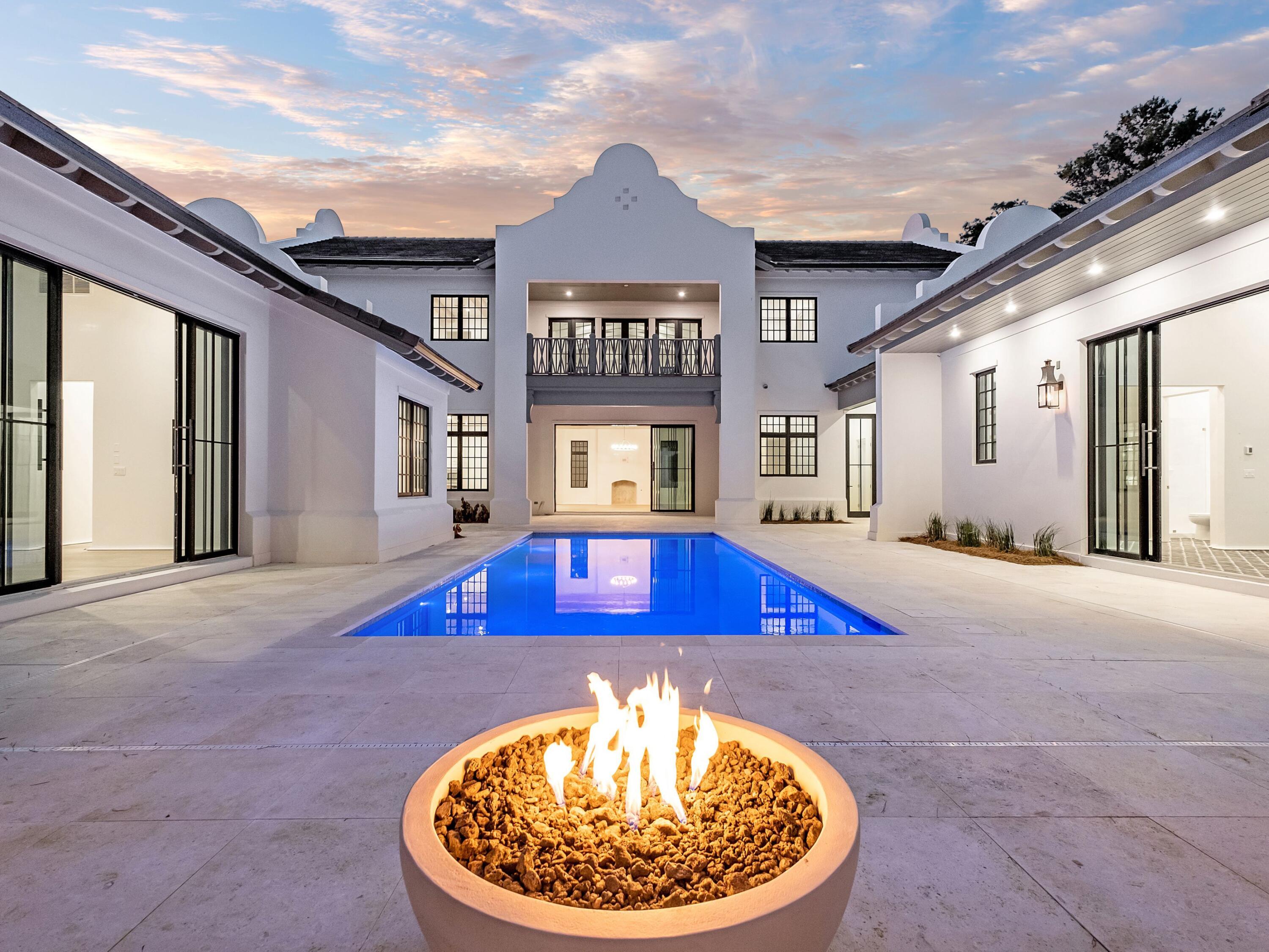 Coastal luxury adorns this Coastal Elements and Greg Jazayeri architectural masterpiece with appointments by Suzy Accola and Q Tile that is bounded by subtle brick paved streets and the natural privacy only offered by mature landscaping years in the making. This retreat is finely accented with a deep heritage in curating only the finest finishes, including venetian plaster, custom hand-crafted tiles, rustic beam design, hand milled moldings, and custom crafted artisan cabinetry. Situated behind the gates of Redfish Lane that stays true to form in a setting that wraps around the natural abode of Little Redfish Lake with mature live oak trees and dense foliage. This bespoke home has been designed to offer a simple elegant look and contemporary feel, with 4 years in the making, we are pleased to bring this unique designer home to market.

24 Sienna is the pinnacle for family legacy along 30A, constructed of reinforced form poured solid concrete to withstand the generations of time. From the start, the understated and privately gated entry to the neighborhood is subtle and inviting but serves to transition you to 30A's old-Florida charm with slender brick paved streets garnished by a lush overhead canopy that envelops the streets with natural shade. With the rich character of the natural setting, the clean contemporary lines and captivating architectural accents are placed into the landscape as if they have been there for generations. Walking up to the home, its impression is grace and strength with ambiance by the pass-through entry way with towering hurricane glass doors that afront a reclaimed white-oak vaulted ceiling and look out over the finely curated private courtyard oasis that becomes the focal point for the layout of the home. Clean symmetry is showcased in the contrasting large multi paneled windows and sliding doors that covet the seamless indoor-outdoor flow of the home. The first floor is finished in clean venetian plaster for a timeless appearance with bull-nose casework for a seamless integration of structural accents. The gourmet kitchen completes the open style living arrangement with built-in cabinet finish appliances that flow to the oversized eat in cypress finished island. The connected living room is dressed with reclaimed white oak cased beams that interface with the elegant venetian plaster to contrast the clean finishes of new with the reclaimed rustic nature of old. Finalizing the ambiance in relaxed entertaining is a custom solid masonry herringbone fireplace that looks out onto the wrap around private courtyard creating a luxurious oasis. Drifting through the main floor each area is meticulously designed for grace and feel and all lookout over the private outdoor area to offer relaxed flow from any location. The first floor master bedroom continues the theme of craftsman level finishes with its own vaulted ceiling with reclaimed beams and towering entry to the courtyard and outdoor fire pit. From outside, the home is completed with a grand outdoor kitchen and prep station, an outdoor loggia, fire pit, and lounge area sure to please everyone in the family. Dressed across the courtyard and detached but still part of the first floor is a complete guest house with its own feel of urban grace with a vaulted ceiling and solid hardwood cabinetry that is handmade with inset facework. The tile work throughout is curated of solid marble or handmade tiles to give each rest area a sense of timeless identity. From the start, the sophistication of 24 Sienna is subtly announced throughout and is curated with the finest finishes.

24 Sienna is located in the non-rental community of Redfish Lane subdivision which is a succinctly private planned development that is only available to 18 distinct homesites. This is one of the final builds to finalize the sophisticated nature of the quiet, forest lined arrangement of Little Redfish Lake. The home boasts 5,095 square feet of painstaking design and finish work completed with 6 bedrooms and 5.5 bathrooms and is ready to be the final legacy of your 30A masterpiece.