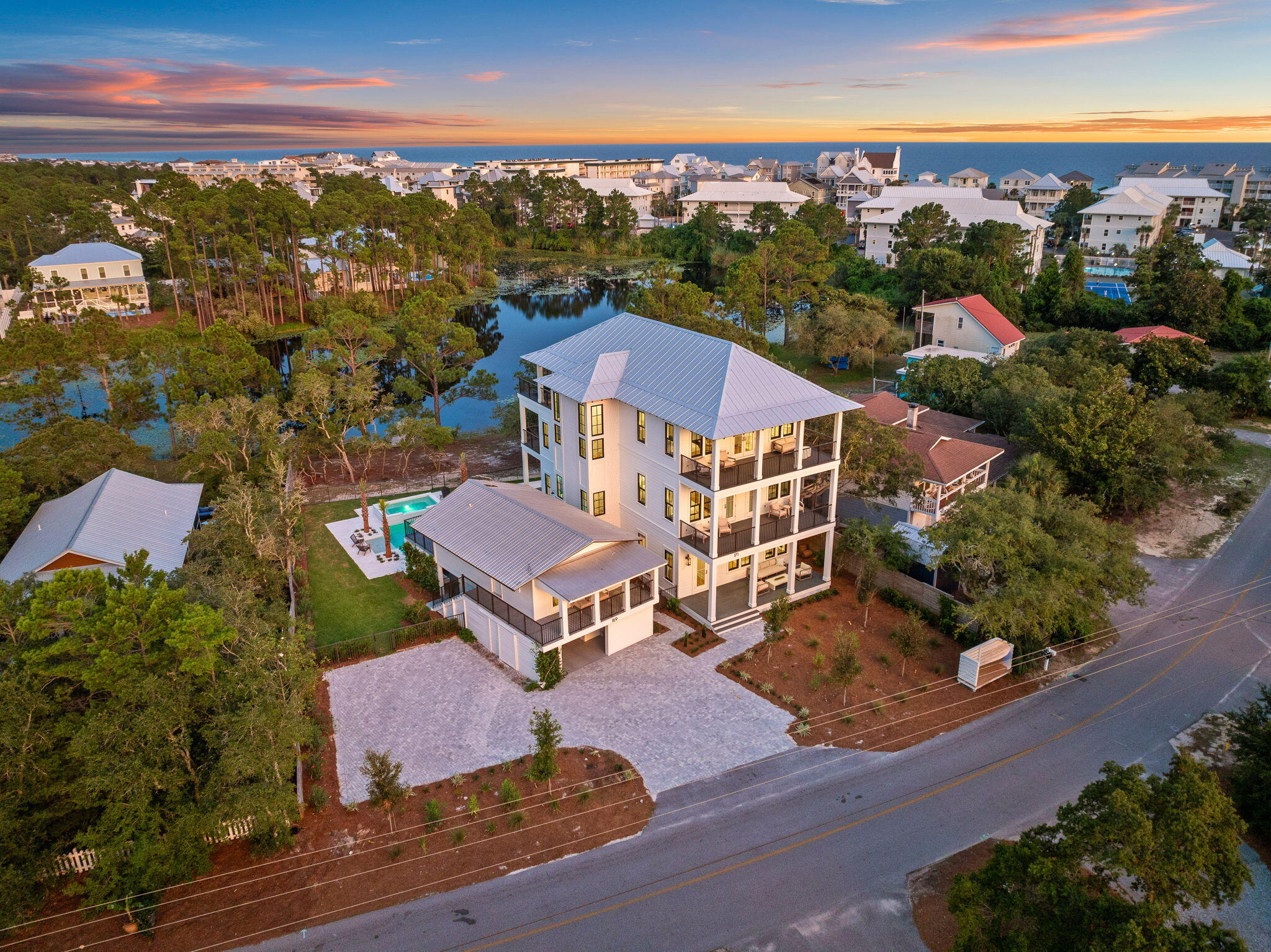 Perfectly positioned in Seagrove Beach, this compelling new construction opportunity sprawls along 75' of Tresca Lake frontage framed by the picturesque landscape and idyllic Gulf views. Designed by the acclaimed Gregory D Jazayeri, the floor-plan encompasses over 5,000 square feet of expertly planned living space spanning three levels interconnected by both stairs and a full-service elevator. The expansive window walls and articulation of exterior lines expose an especial modern flair while holding true to the coastal design.
 
Upon entering the first floor you are greeted by the main living area, dining room, and Chef's kitchen. Enjoy direct access to the outdoor oasis with oversized pool, hot tub, and private dock. A bedroom suite completes the first level. The second floor is home to a secondary main suite, additional bedroom, and bunk room, all of which are equipped with private ensuites. The main suite on the second level features private porch access, a large walk-in closet, and a tranquil ensuite boasting both a soaking tub and custom tiled shower.

Nestled on the third floor, the entertainment area and rooftop deck showcase the breathtaking views. An additional bedroom suite is also found on the upper level.

Providing a true retreat for guests, the self-sufficient coach house encompasses an additional three bedrooms along with living area and kitchen.

Views of the majestic coastal dune lake, white sugar sand beaches, and turquoise hued waters can be appreciated throughout the 2,000+ square feet of porch areas offering a seamless and true continuation of living space throughout.

Seagrove Beach is ideally centered within minutes of the iconic town centers and world class dining and entertainment venues found along 30A. Impressive rental income potential coupled with the ample amenities and features often only found in primary residences make this a unique opportunity for investors and full-time residents alike. Inquire today and discover the luxurious coastal lifestyle that awaits.