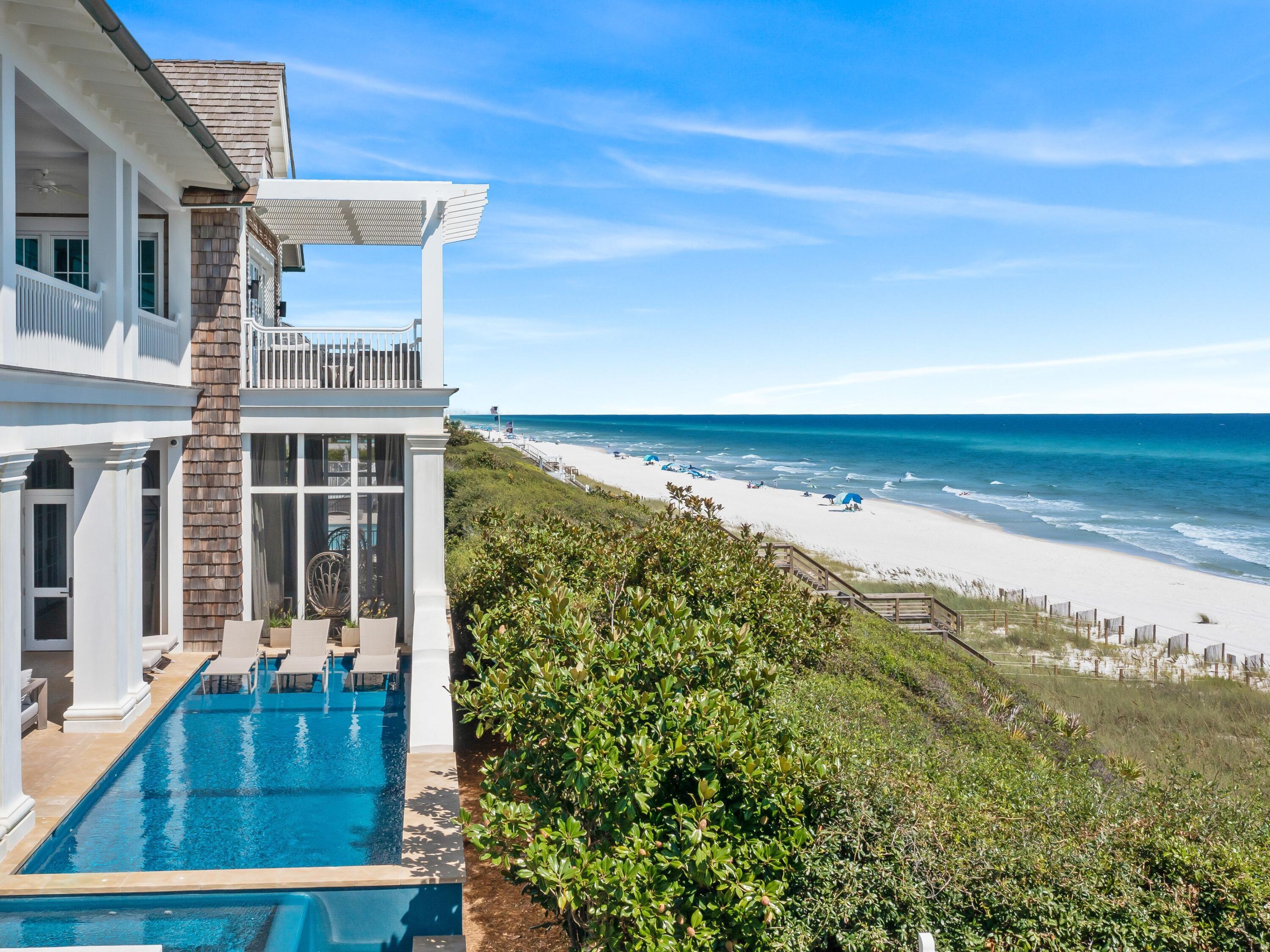 Just steps from the crystalline waters of the Gulf of Mexico, this remarkable residence perched above the dunes demonstrates perfect harmony between modern elegance and old-world charm. Every aspect of this home, created by Geoff Chick, strikes notes that reflect its picturesque surroundings — from its sturdy all-concrete construction to cedar shake siding that dovetails with nature. Beyond the gate, the well-trained eye will notice the decommissioned brick paver drive imported from the streets of Charleston, S.C., leading to a two-car garage and a commanding second-floor entryway. As you step inside, prepare to discover a plethora of thoughtful features that elevate the living experience and cater to your every need. Open-concept living, dining and cooking spaces are accented by sparkling gulf views. Reharvested ceiling beams sourced from Ohio in this space showcase sustainable elegance and shell stone flooring adds a timeless charm. A custom dining table and chandelier set the stage for exquisite culinary experiences, adjacent to the kitchen with scullery, featuring solid Taj Mahal quartzite counters and shelving, is equipped with premium Sub-Zero appliances, a Viking range and a metal island with integrated sink and bar seating. Custom Waterworks fixtures add a touch of opulence, while unskinned plaster walls, custom lighting and modern flat-front cabinetry exemplify exquisite attention to detail. Two bedrooms on this floor represent the thematic interior styling of Nashville's Chad James Group, with noteworthy features including automatic blinds, tailor-made rugs and custom grasscloth wallpaper that adds depth and character. Ensuite baths offer custom, paneled linen closets, handpainted Mackenzie-Childs accents and matte quartzite countertops. 

Throughout the home, you'll find writing desks and computer nooks that offer serene hideaways for productivity. Multiple areas of the home were fitted for a family's furry companions, from the dedicated dog room with Dutch door to the hidden dog gate in the stair post to a dog-washing station complete with a quartz sink. Even the gulf-front pool was created with pup-friendly features in mind, such as a shallow shelf for relaxing in the sun. A spa with waterfall feature gives the entire family a place to unwind, near a screened porch with outdoor kitchen.

The second floor is home to a standalone suite over the garage, reminiscent of a charming carriage house, with a full ensuite bath, storage/sitting area, and bunk beds, offering a private retreat for guests. A second gulf-front living area with tile ceiling creates a space for relaxation and entertainment. Two gulf-front bedrooms offer breathtaking views along with walk-in closets, private baths and serene gulf-front porches. The master suite is a sanctuary of refined elegance with plaster walls; silk, stitched wallpaper; a vaulted ceiling; and, a private gulf-front balcony. The master bath is a haven of serenity, featuring a marble bathtub, separate shower, dual marble vanities, Waterworks fixtures and suspended mirrors, all meticulously crafted to create an oasis of relaxation. 

Every detail of this home has been thoughtfully curated including a tankless hot water system, multiple laundry areas, a private elevator, whole-home automation from Control4, whole-home audio, and more than 2,000 square feet of climate-controlled storage including space for beach gear just steps from the private Trex boardwalk to the pristine beach below. Five-step baseboards and doors, as well as four-panel wainscoting throughout add touches of sophistication and grandeur to every space. The home is a testament to American ingenuity, emphasizing quality craftsmanship at every turn.

Embrace coastal grandeur and indulge in the refined elegance that awaits within these walls, perfectly positioned in the coveted Camp Creek Point neighborhood, minutes from Scenic Highway 30A's myriad shopping and dining destinations.