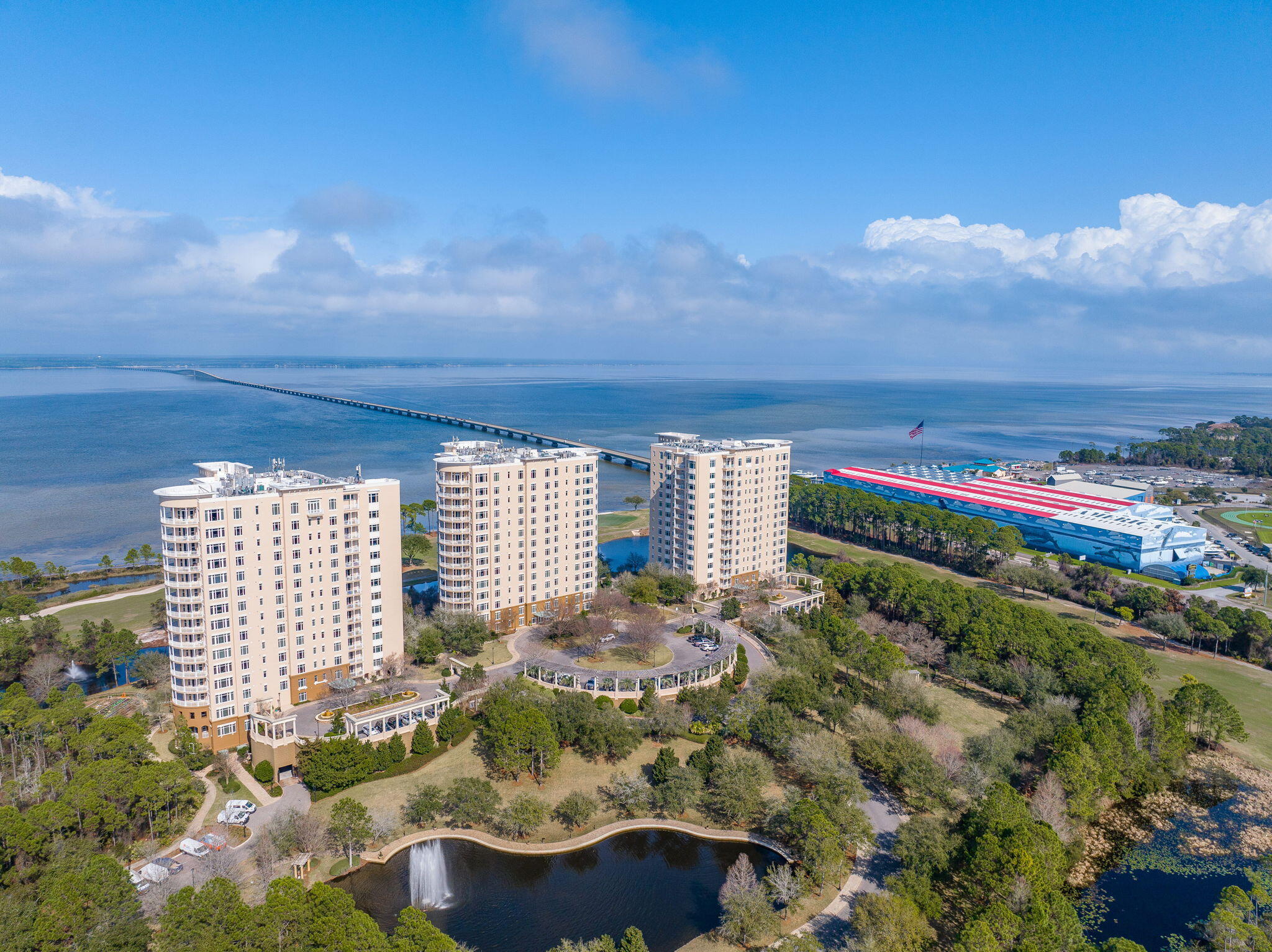 This impeccably designed residence offers three spacious bedrooms and an abundant open living area, beautifully furnished with designer pieces that enhance both comfort and style. A striking mahogany double-door entry with opaque glass sets a dramatic tone upon arrival, leading into living spaces finished with wood-look plank tile and extensive windows that frame breathtaking panoramic views of the Choctawhatchee Bay.  The chef's kitchen is a true showpiece, featuring gorgeous floor-to-ceiling cabinetry, a brick-inspired tiled backsplash, granite countertops, and high-end Viking appliances, including a wine cooler. Two fabulous, oversized kitchen islands create exceptional flow for entertaining and everyday living.  A long, elegant hallway is accented with custom built-in bookshelves, while the guest half bath is elevated with sleek, sophisticated wallpaper. Each bedroom is finished with cozy plush carpet, and the primary suite offers a private retreat complete with professionally designed closets and an opulent spa-like bath featuring a spacious soaking tub and a separate walk-in shower.  Additional interior highlights include a large laundry room, a bonus room ideal for flexible use, and fabulous designer fixtures throughout. Outdoor living is equally impressive, with a wraparound balcony that dramatically expands your space. The balcony is fully equipped with an outdoor grill, refrigerator, and sink, perfect for cooking, dining, and enjoying the coastal breeze and stunning bay views.  Resort-style amenities complete this exceptional offering, including a two-tier pool and hot tub, fitness center, spa and sauna, dog park, hobby and game rooms, guest suites, and two deeded covered parking spacesdelivering luxury, convenience, and lifestyle all in one remarkable residence.  The Kelly Plantation neighborhood encompasses miles of walking trails, rubico and hard tennis courts, pickleball, basketball, ponds, a community gathering center, a gym, a huge pool and gated security at both entrances.