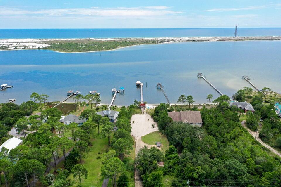 This marsh-free, wetlands-free, unencumbered 1+ acre waterfront property is comprised of approximately 100-feet of beautiful white sandy beach on the Santa Rosa Sound and 107-feet of street front land. It is an impressive 432-feet long on the east side and 418-feet on the west side (different lengths due to shoreline profile). The parcel is plenty large enough for an expansive main house and separate smaller house. The sewer tap fee has long been paid and the sewer line has already been run from the tap to the main house site, as has the main water line and natural gas line. A functioning lawn pump on an existing private well supplies a multi-zone pop-up sprinkler system. There is a long, wide cement driveway, with a turnaround, that runs from Parish Blvd. to potential main house and separate smaller house sites. Also included is a 320-foot dock with an enclosed boathouse and partially covered south end - for shady comfort and rain/sun protection while relaxing, fishing, etc. The dock's relatively deep-water south end also features a 50-foot yacht slip, covered boatlift and 2 covered wave runner lifts, as well as a covered fish-cleaning counter and sink. There is also an attractive, well-built octagon-shaped covered gazebo connected to the beach-end of this spectacular dock.
This property is located in one of the absolute most picturesque areas of the beautiful Santa Rosa Sound. The postcard-like backdrop of the Sound-front view includes a never-to-be developed, Air Force-owned barrier island covered in sand dunes made of sugar-white sand separated by aromatic native pine trees. This naturally beautiful, virtually undisturbed barrier island separates the emerald waters of the Gulf of Mexico from the calmer, pristine waters of the Santa Rosa Sound. Just imagine a rare natural waterfront view of the Sound and barrier island that will never be contaminated by high-rise condominiums.
The location of this large waterfront property on Parish Blvd. takes you away from the hustle and bustle of noisy U.S. Highway 98. This quiet location away from Hwy 98, combined with the fact that the vessel navigation channel is located on the opposite side of the Santa Rosa Sound, makes for one of the most tranquil and majestic waterfront settings in south Okaloosa County, if not all of Northwest Florida. This is the perfect property to buy and build your forever dream home. There is an ever-diminishing, finite amount of waterfront properties available in Okaloosa County and an even more finite number of waterfront properties of this caliber. Notably, Parish Point, a waterfront subdivision first developed around the year 1980, is one of the last waterfront subdivisions in south Okaloosa County, if not the last, to feature 100-foot-wide waterfront lots on the Santa Rosa Sound. Don't miss out on this golden opportunity to own a piece of Northwest Florida heaven!