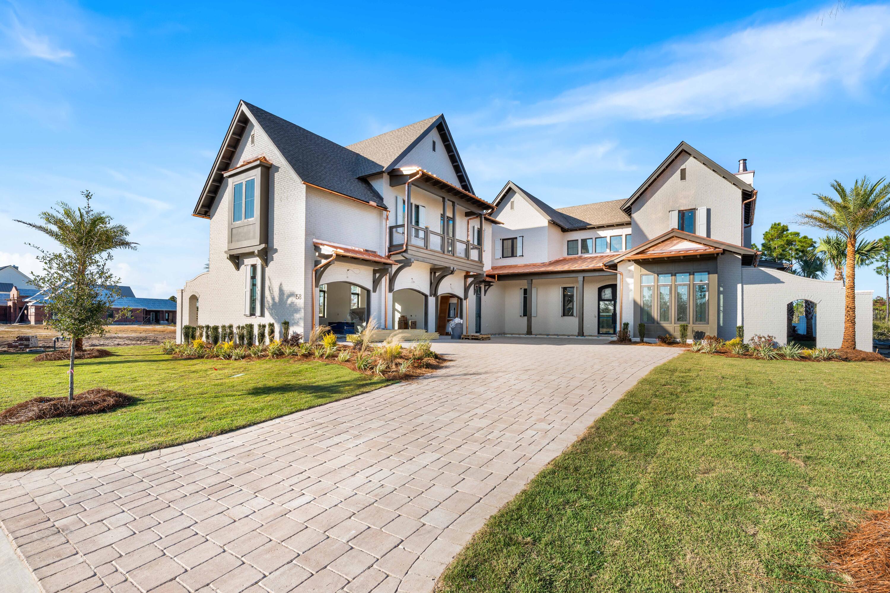 Experience the pinnacle of coastal elegance with this exceptional new construction home on Sandcord Drive. Currently in the finishing stages, this thoughtfully designed 5-bedroom, 5-bathroom, 2-half-bathroom residence showcases exquisite craftsmanship and sophisticated details throughout.

The first floor features soaring coffered ceilings and seamless flow to outdoor living areas, while the second floor provides private retreats with a covered balcony overlooking the backyard oasis. A detached carriage house offers flexible guest quarters or additional living space. Expansive covered porches, including screened areas with tongue-and-groove ceilings, extend the living space outdoors. This exceptional home features two primary suites offering unparalleled comfort and privacy, along with three additional generously-sized bedrooms. With five full bathrooms and two powder rooms, the home provides exceptional convenience for family and guests alike.

The stunning white painted brick exterior features custom copper gutters and downspouts complemented by dramatic black-framed windows and an arched entryway. Inside, coffered ceilings with crown molding grace the main living areas, while statement lighting including cascading beaded chandeliers adds elegance throughout. An elegant curved staircase with wood treads and metal railings connects the floors. The chef's kitchen showcases an expansive island, premium quartz countertops, and designer tile backsplash.

The backyard oasis centers around a custom pool with integrated spa featuring modern tile detailing. Multiple covered porches include an outdoor fireplace perfect for year-round entertaining, while a dedicated pool bath adds convenience. A private putting green caters to golf enthusiasts. Professional landscaping with palms and native plantings frames paver driveway and walkways throughout the property.

Located in the highly sought-after Watersound Camp Creek community, this home represents the perfect marriage of timeless design and modern coastal living. With completion anticipated soon, this is a rare opportunity to own a brand-new luxury residence in one of 30A's most desirable neighborhoods.